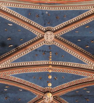 Zdjęcie nr 87: Kościół położony na południe od rynku, na placu otoczonym kamiennym murem z dwiema bramkami od zachodu i północy oraz bramką od południa. Kościół jednonawowy, dwuprzęsłowy, z węższym, niższym dwuprzęsłowym prezbiterium zamkniętym pięciobocznie. Do prezbiterium przylegają dwa aneksy, od północy dawna zakrystia (obecnie kaplica świętych Męczennic), zamknięta od wschodu dwubocznie, mająca w narożu z korpusem wieżyczkę schodową, a od południa zakrystia nowa, na planie prostokąta. Do nawy przylegają dwie kaplice: od północy kaplica Lubomirskich, założona na rzucie kwadratu, nakryta kopułą, a od południa kaplica Branickich, także na rzucie kwadratu z kopułą. Przy korpusie od zachodu piętrowa kruchta, pierwotnie otwarta w przyziemiu od północy, zachodu i południa ostrołukowymi arkadami. Arkada tęczy ostrołukowa. Sklepienie prezbiterium, zakrystii i obu kondygnacjach kruchty krzyżowo-żebrowe, w korpusie, pierwotnie trójprzęsłowym, pierwotnie sklepienie o polach trójkątnych z trójpromieniem, wsparte na dwóch dziesięciobocznych filarach, obecnie kolebkowo z lunetami. Żebra w prezbiterium i zakrystii o profilu żłobkowym, w kruchcie - gruszkowym. W prezbiterium służki cylindryczne, nadwieszone na oplecionych liśćmi wspornikach oraz rzeźbione zworniki z przedstawieniem Głowy Chrystusa i motywami roślinnymi. Ściany rozczłonkowane wykonanymi w czarnego marmuru arkadami, zamkniętymi łukiem półkolistymi. Okna ostrołukowe , obustronnie rozglifione z krzyżowym laskowaniem, w ścianie północnym prezbiterium ślepe. Kościół opięty przyporami. Elewacje na cokole, z profilowanymi gzymsami cokołowymi, kapnikowym i koronującym. Szczyty zwieńczone kwiatonami, z których zachodnie z krzyżem. Portale kamienne, ostrołukowe: zachodni profilowany, z ażurowym maswerkiem; drugi w prezbiterium do zakrystii, profilowany; trzeci do wieżyczki schodowej.