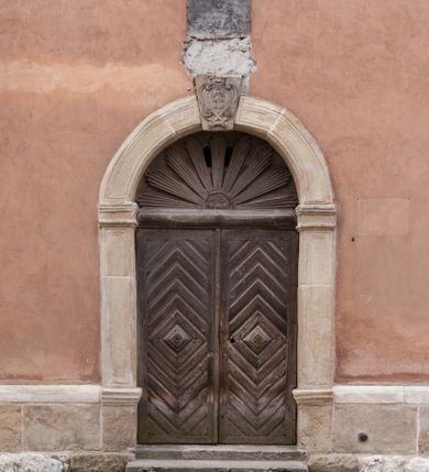 Zdjęcie nr 97: Kościół położony na południe od rynku, na placu otoczonym kamiennym murem z dwiema bramkami od zachodu i północy oraz bramką od południa. Kościół jednonawowy, dwuprzęsłowy, z węższym, niższym dwuprzęsłowym prezbiterium zamkniętym pięciobocznie. Do prezbiterium przylegają dwa aneksy, od północy dawna zakrystia (obecnie kaplica świętych Męczennic), zamknięta od wschodu dwubocznie, mająca w narożu z korpusem wieżyczkę schodową, a od południa zakrystia nowa, na planie prostokąta. Do nawy przylegają dwie kaplice: od północy kaplica Lubomirskich, założona na rzucie kwadratu, nakryta kopułą, a od południa kaplica Branickich, także na rzucie kwadratu z kopułą. Przy korpusie od zachodu piętrowa kruchta, pierwotnie otwarta w przyziemiu od północy, zachodu i południa ostrołukowymi arkadami. Arkada tęczy ostrołukowa. Sklepienie prezbiterium, zakrystii i obu kondygnacjach kruchty krzyżowo-żebrowe, w korpusie, pierwotnie trójprzęsłowym, pierwotnie sklepienie o polach trójkątnych z trójpromieniem, wsparte na dwóch dziesięciobocznych filarach, obecnie kolebkowo z lunetami. Żebra w prezbiterium i zakrystii o profilu żłobkowym, w kruchcie - gruszkowym. W prezbiterium służki cylindryczne, nadwieszone na oplecionych liśćmi wspornikach oraz rzeźbione zworniki z przedstawieniem Głowy Chrystusa i motywami roślinnymi. Ściany rozczłonkowane wykonanymi w czarnego marmuru arkadami, zamkniętymi łukiem półkolistymi. Okna ostrołukowe , obustronnie rozglifione z krzyżowym laskowaniem, w ścianie północnym prezbiterium ślepe. Kościół opięty przyporami. Elewacje na cokole, z profilowanymi gzymsami cokołowymi, kapnikowym i koronującym. Szczyty zwieńczone kwiatonami, z których zachodnie z krzyżem. Portale kamienne, ostrołukowe: zachodni profilowany, z ażurowym maswerkiem; drugi w prezbiterium do zakrystii, profilowany; trzeci do wieżyczki schodowej.