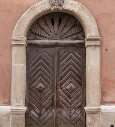 Zdjęcie nr 100: Kościół położony na południe od rynku, na placu otoczonym kamiennym murem z dwiema bramkami od zachodu i północy oraz bramką od południa. Kościół jednonawowy, dwuprzęsłowy, z węższym, niższym dwuprzęsłowym prezbiterium zamkniętym pięciobocznie. Do prezbiterium przylegają dwa aneksy, od północy dawna zakrystia (obecnie kaplica świętych Męczennic), zamknięta od wschodu dwubocznie, mająca w narożu z korpusem wieżyczkę schodową, a od południa zakrystia nowa, na planie prostokąta. Do nawy przylegają dwie kaplice: od północy kaplica Lubomirskich, założona na rzucie kwadratu, nakryta kopułą, a od południa kaplica Branickich, także na rzucie kwadratu z kopułą. Przy korpusie od zachodu piętrowa kruchta, pierwotnie otwarta w przyziemiu od północy, zachodu i południa ostrołukowymi arkadami. Arkada tęczy ostrołukowa. Sklepienie prezbiterium, zakrystii i obu kondygnacjach kruchty krzyżowo-żebrowe, w korpusie, pierwotnie trójprzęsłowym, pierwotnie sklepienie o polach trójkątnych z trójpromieniem, wsparte na dwóch dziesięciobocznych filarach, obecnie kolebkowo z lunetami. Żebra w prezbiterium i zakrystii o profilu żłobkowym, w kruchcie - gruszkowym. W prezbiterium służki cylindryczne, nadwieszone na oplecionych liśćmi wspornikach oraz rzeźbione zworniki z przedstawieniem Głowy Chrystusa i motywami roślinnymi. Ściany rozczłonkowane wykonanymi w czarnego marmuru arkadami, zamkniętymi łukiem półkolistymi. Okna ostrołukowe , obustronnie rozglifione z krzyżowym laskowaniem, w ścianie północnym prezbiterium ślepe. Kościół opięty przyporami. Elewacje na cokole, z profilowanymi gzymsami cokołowymi, kapnikowym i koronującym. Szczyty zwieńczone kwiatonami, z których zachodnie z krzyżem. Portale kamienne, ostrołukowe: zachodni profilowany, z ażurowym maswerkiem; drugi w prezbiterium do zakrystii, profilowany; trzeci do wieżyczki schodowej.