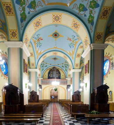 Zdjęcie nr 12: Kościół orientowany, murowany, trójnawowy, halowy, na rzucie prostokąta z wydłużonym, skierowanym na północ prezbiterium z dobudowaną zakrystią i skarbcem. Prezbiterium dwuprzęsłowe, węższe i niższe od korpusu, zamknięte prosto, z arkadową wnęką od strony wnętrza. Na łuku tęczowym napis „SERCE JEZUSA KRÓLOJ NAM”. Nawa główna oraz boczne trójprzęsłowe, rozdzielone masywnymi opilastrowanymi filarami; artykulacja ścian kontynuuje podziały sklepienia, którego szerokie gurty przechodzą w pilastry. Sklepienie prezbiterium oraz naw żagielkowe, przedzielone gurtami. Od południa chór muzyczny mieszczący się między pierwszymi filarami i powyżej kruchty wejściowej. W prezbiterium cztery okna w kształcie stojącego prostokąta zamknięte łukiem półkolistym oraz po dwa mniejsze, ale powtarzające ich kształt w skarbcu i zakrystii. W nawach bocznych po trzy okna wyznaczające środek każdego przęsła, naprzemiennie o opisanym kształcie oraz okulusy; w fasadzie powyżej wejścia okulus, wieża przepruta z każdej strony prostokątnym oknem zamkniętym półkoliście. Główne wejście od wschodu, po jednym od północy, południa, do zakrystii, do skarbca oraz między wymienionymi pomieszczeniami a prezbiterium. Ściany i sklepienia kościoła pokrywa polichromia skomponowana z dekoracji floralnych i floralno-geometrycznych oraz umieszczonych w jej obrębie symboli m.in. ewangelistów. Fasada wieżowa, trójosiowa, jednoprzęsłowa, z widocznym wątkiem kamiennym w dolnej i otynkowana w górnej części. Środkowa oś wyższa; podziały pionowe przeprowadzono za pomocą pilastrów, kondygnacje zamknięto gzymsem poziomym w osiach bocznych oraz wyniesionym i wyłamanym w środkowej. W osi środkowej portal w kształcie stojącego prostokąta zamkniętego łukiem półkolistym w szerokim rozglifieniu, a powyżej okulus. Zamykający kondygnacje trójkątny przyczółek dekorowany od dołu fryzem arkadkowym ułożonym schodkowo, ujmującym półokrągłą, konchową wnękę z figurą Matki Boskiej z Lourdes. W osiach bocznych większe wnęki powtarzające kształt opisanej, wypełnione figurami św. Cyryla i Metodego. Powyżej widoczna wieża, której kondygnacja jest przepruta oknami i zwieńczona gzymsem wyłamanym na osiach; w trójkątnych polach ślepe okulusy. Elewacje boczne z ciosu kamiennego przeprute jedynie oknami i portalami, zamknięte gzymsem o fryzie  wypełnionym prostokątnymi wnękami i gzymsie z ząbkowaniem. Nawy oraz prezbiterium przykrywają dachy dwuspadowe, zakrystię oraz skarbiec pulpitowe, wieżę namiotowy z fartuchem zwieńczony kulą z krzyżem. 
Do najciekawszych elementów wyposażenia należy neośredniowieczny ołtarz główny oraz rokokowa ambona z antyamboną. Najstarszym zabytkiem w posiadaniu kościoła św. Wojciecha jest tzw. „czarna Madonna” – umieszczona w późniejszym feretronie niewielka figurka Matki Boskiej z Dzieciątkiem pochodząca z XIV wieku. 
