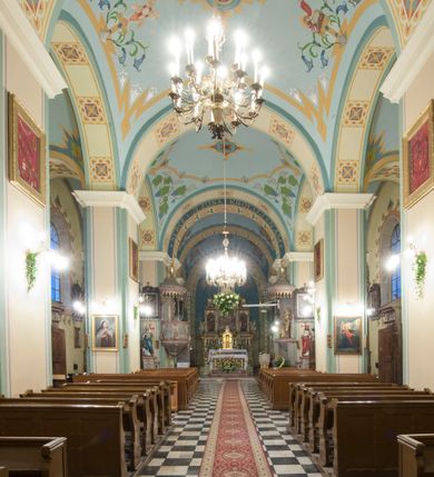 Zdjęcie nr 9: Kościół orientowany, murowany, trójnawowy, halowy, na rzucie prostokąta z wydłużonym, skierowanym na północ prezbiterium z dobudowaną zakrystią i skarbcem. Prezbiterium dwuprzęsłowe, węższe i niższe od korpusu, zamknięte prosto, z arkadową wnęką od strony wnętrza. Na łuku tęczowym napis „SERCE JEZUSA KRÓLOJ NAM”. Nawa główna oraz boczne trójprzęsłowe, rozdzielone masywnymi opilastrowanymi filarami; artykulacja ścian kontynuuje podziały sklepienia, którego szerokie gurty przechodzą w pilastry. Sklepienie prezbiterium oraz naw żagielkowe, przedzielone gurtami. Od południa chór muzyczny mieszczący się między pierwszymi filarami i powyżej kruchty wejściowej. W prezbiterium cztery okna w kształcie stojącego prostokąta zamknięte łukiem półkolistym oraz po dwa mniejsze, ale powtarzające ich kształt w skarbcu i zakrystii. W nawach bocznych po trzy okna wyznaczające środek każdego przęsła, naprzemiennie o opisanym kształcie oraz okulusy; w fasadzie powyżej wejścia okulus, wieża przepruta z każdej strony prostokątnym oknem zamkniętym półkoliście. Główne wejście od wschodu, po jednym od północy, południa, do zakrystii, do skarbca oraz między wymienionymi pomieszczeniami a prezbiterium. Ściany i sklepienia kościoła pokrywa polichromia skomponowana z dekoracji floralnych i floralno-geometrycznych oraz umieszczonych w jej obrębie symboli m.in. ewangelistów. Fasada wieżowa, trójosiowa, jednoprzęsłowa, z widocznym wątkiem kamiennym w dolnej i otynkowana w górnej części. Środkowa oś wyższa; podziały pionowe przeprowadzono za pomocą pilastrów, kondygnacje zamknięto gzymsem poziomym w osiach bocznych oraz wyniesionym i wyłamanym w środkowej. W osi środkowej portal w kształcie stojącego prostokąta zamkniętego łukiem półkolistym w szerokim rozglifieniu, a powyżej okulus. Zamykający kondygnacje trójkątny przyczółek dekorowany od dołu fryzem arkadkowym ułożonym schodkowo, ujmującym półokrągłą, konchową wnękę z figurą Matki Boskiej z Lourdes. W osiach bocznych większe wnęki powtarzające kształt opisanej, wypełnione figurami św. Cyryla i Metodego. Powyżej widoczna wieża, której kondygnacja jest przepruta oknami i zwieńczona gzymsem wyłamanym na osiach; w trójkątnych polach ślepe okulusy. Elewacje boczne z ciosu kamiennego przeprute jedynie oknami i portalami, zamknięte gzymsem o fryzie  wypełnionym prostokątnymi wnękami i gzymsie z ząbkowaniem. Nawy oraz prezbiterium przykrywają dachy dwuspadowe, zakrystię oraz skarbiec pulpitowe, wieżę namiotowy z fartuchem zwieńczony kulą z krzyżem. 
Do najciekawszych elementów wyposażenia należy neośredniowieczny ołtarz główny oraz rokokowa ambona z antyamboną. Najstarszym zabytkiem w posiadaniu kościoła św. Wojciecha jest tzw. „czarna Madonna” – umieszczona w późniejszym feretronie niewielka figurka Matki Boskiej z Dzieciątkiem pochodząca z XIV wieku. 
