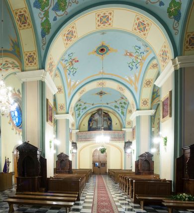 Zdjęcie nr 11: Kościół orientowany, murowany, trójnawowy, halowy, na rzucie prostokąta z wydłużonym, skierowanym na północ prezbiterium z dobudowaną zakrystią i skarbcem. Prezbiterium dwuprzęsłowe, węższe i niższe od korpusu, zamknięte prosto, z arkadową wnęką od strony wnętrza. Na łuku tęczowym napis „SERCE JEZUSA KRÓLOJ NAM”. Nawa główna oraz boczne trójprzęsłowe, rozdzielone masywnymi opilastrowanymi filarami; artykulacja ścian kontynuuje podziały sklepienia, którego szerokie gurty przechodzą w pilastry. Sklepienie prezbiterium oraz naw żagielkowe, przedzielone gurtami. Od południa chór muzyczny mieszczący się między pierwszymi filarami i powyżej kruchty wejściowej. W prezbiterium cztery okna w kształcie stojącego prostokąta zamknięte łukiem półkolistym oraz po dwa mniejsze, ale powtarzające ich kształt w skarbcu i zakrystii. W nawach bocznych po trzy okna wyznaczające środek każdego przęsła, naprzemiennie o opisanym kształcie oraz okulusy; w fasadzie powyżej wejścia okulus, wieża przepruta z każdej strony prostokątnym oknem zamkniętym półkoliście. Główne wejście od wschodu, po jednym od północy, południa, do zakrystii, do skarbca oraz między wymienionymi pomieszczeniami a prezbiterium. Ściany i sklepienia kościoła pokrywa polichromia skomponowana z dekoracji floralnych i floralno-geometrycznych oraz umieszczonych w jej obrębie symboli m.in. ewangelistów. Fasada wieżowa, trójosiowa, jednoprzęsłowa, z widocznym wątkiem kamiennym w dolnej i otynkowana w górnej części. Środkowa oś wyższa; podziały pionowe przeprowadzono za pomocą pilastrów, kondygnacje zamknięto gzymsem poziomym w osiach bocznych oraz wyniesionym i wyłamanym w środkowej. W osi środkowej portal w kształcie stojącego prostokąta zamkniętego łukiem półkolistym w szerokim rozglifieniu, a powyżej okulus. Zamykający kondygnacje trójkątny przyczółek dekorowany od dołu fryzem arkadkowym ułożonym schodkowo, ujmującym półokrągłą, konchową wnękę z figurą Matki Boskiej z Lourdes. W osiach bocznych większe wnęki powtarzające kształt opisanej, wypełnione figurami św. Cyryla i Metodego. Powyżej widoczna wieża, której kondygnacja jest przepruta oknami i zwieńczona gzymsem wyłamanym na osiach; w trójkątnych polach ślepe okulusy. Elewacje boczne z ciosu kamiennego przeprute jedynie oknami i portalami, zamknięte gzymsem o fryzie  wypełnionym prostokątnymi wnękami i gzymsie z ząbkowaniem. Nawy oraz prezbiterium przykrywają dachy dwuspadowe, zakrystię oraz skarbiec pulpitowe, wieżę namiotowy z fartuchem zwieńczony kulą z krzyżem. 
Do najciekawszych elementów wyposażenia należy neośredniowieczny ołtarz główny oraz rokokowa ambona z antyamboną. Najstarszym zabytkiem w posiadaniu kościoła św. Wojciecha jest tzw. „czarna Madonna” – umieszczona w późniejszym feretronie niewielka figurka Matki Boskiej z Dzieciątkiem pochodząca z XIV wieku. 
