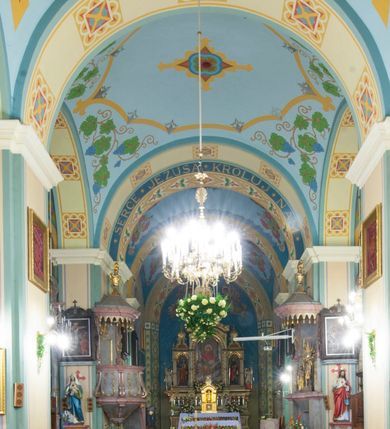 Zdjęcie nr 10: Kościół orientowany, murowany, trójnawowy, halowy, na rzucie prostokąta z wydłużonym, skierowanym na północ prezbiterium z dobudowaną zakrystią i skarbcem. Prezbiterium dwuprzęsłowe, węższe i niższe od korpusu, zamknięte prosto, z arkadową wnęką od strony wnętrza. Na łuku tęczowym napis „SERCE JEZUSA KRÓLOJ NAM”. Nawa główna oraz boczne trójprzęsłowe, rozdzielone masywnymi opilastrowanymi filarami; artykulacja ścian kontynuuje podziały sklepienia, którego szerokie gurty przechodzą w pilastry. Sklepienie prezbiterium oraz naw żagielkowe, przedzielone gurtami. Od południa chór muzyczny mieszczący się między pierwszymi filarami i powyżej kruchty wejściowej. W prezbiterium cztery okna w kształcie stojącego prostokąta zamknięte łukiem półkolistym oraz po dwa mniejsze, ale powtarzające ich kształt w skarbcu i zakrystii. W nawach bocznych po trzy okna wyznaczające środek każdego przęsła, naprzemiennie o opisanym kształcie oraz okulusy; w fasadzie powyżej wejścia okulus, wieża przepruta z każdej strony prostokątnym oknem zamkniętym półkoliście. Główne wejście od wschodu, po jednym od północy, południa, do zakrystii, do skarbca oraz między wymienionymi pomieszczeniami a prezbiterium. Ściany i sklepienia kościoła pokrywa polichromia skomponowana z dekoracji floralnych i floralno-geometrycznych oraz umieszczonych w jej obrębie symboli m.in. ewangelistów. Fasada wieżowa, trójosiowa, jednoprzęsłowa, z widocznym wątkiem kamiennym w dolnej i otynkowana w górnej części. Środkowa oś wyższa; podziały pionowe przeprowadzono za pomocą pilastrów, kondygnacje zamknięto gzymsem poziomym w osiach bocznych oraz wyniesionym i wyłamanym w środkowej. W osi środkowej portal w kształcie stojącego prostokąta zamkniętego łukiem półkolistym w szerokim rozglifieniu, a powyżej okulus. Zamykający kondygnacje trójkątny przyczółek dekorowany od dołu fryzem arkadkowym ułożonym schodkowo, ujmującym półokrągłą, konchową wnękę z figurą Matki Boskiej z Lourdes. W osiach bocznych większe wnęki powtarzające kształt opisanej, wypełnione figurami św. Cyryla i Metodego. Powyżej widoczna wieża, której kondygnacja jest przepruta oknami i zwieńczona gzymsem wyłamanym na osiach; w trójkątnych polach ślepe okulusy. Elewacje boczne z ciosu kamiennego przeprute jedynie oknami i portalami, zamknięte gzymsem o fryzie  wypełnionym prostokątnymi wnękami i gzymsie z ząbkowaniem. Nawy oraz prezbiterium przykrywają dachy dwuspadowe, zakrystię oraz skarbiec pulpitowe, wieżę namiotowy z fartuchem zwieńczony kulą z krzyżem. 
Do najciekawszych elementów wyposażenia należy neośredniowieczny ołtarz główny oraz rokokowa ambona z antyamboną. Najstarszym zabytkiem w posiadaniu kościoła św. Wojciecha jest tzw. „czarna Madonna” – umieszczona w późniejszym feretronie niewielka figurka Matki Boskiej z Dzieciątkiem pochodząca z XIV wieku. 
