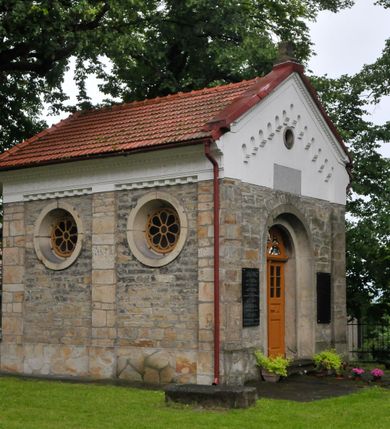 Zdjęcie nr 5: Kościół orientowany, murowany, trójnawowy, halowy, na rzucie prostokąta z wydłużonym, skierowanym na północ prezbiterium z dobudowaną zakrystią i skarbcem. Prezbiterium dwuprzęsłowe, węższe i niższe od korpusu, zamknięte prosto, z arkadową wnęką od strony wnętrza. Na łuku tęczowym napis „SERCE JEZUSA KRÓLOJ NAM”. Nawa główna oraz boczne trójprzęsłowe, rozdzielone masywnymi opilastrowanymi filarami; artykulacja ścian kontynuuje podziały sklepienia, którego szerokie gurty przechodzą w pilastry. Sklepienie prezbiterium oraz naw żagielkowe, przedzielone gurtami. Od południa chór muzyczny mieszczący się między pierwszymi filarami i powyżej kruchty wejściowej. W prezbiterium cztery okna w kształcie stojącego prostokąta zamknięte łukiem półkolistym oraz po dwa mniejsze, ale powtarzające ich kształt w skarbcu i zakrystii. W nawach bocznych po trzy okna wyznaczające środek każdego przęsła, naprzemiennie o opisanym kształcie oraz okulusy; w fasadzie powyżej wejścia okulus, wieża przepruta z każdej strony prostokątnym oknem zamkniętym półkoliście. Główne wejście od wschodu, po jednym od północy, południa, do zakrystii, do skarbca oraz między wymienionymi pomieszczeniami a prezbiterium. Ściany i sklepienia kościoła pokrywa polichromia skomponowana z dekoracji floralnych i floralno-geometrycznych oraz umieszczonych w jej obrębie symboli m.in. ewangelistów. Fasada wieżowa, trójosiowa, jednoprzęsłowa, z widocznym wątkiem kamiennym w dolnej i otynkowana w górnej części. Środkowa oś wyższa; podziały pionowe przeprowadzono za pomocą pilastrów, kondygnacje zamknięto gzymsem poziomym w osiach bocznych oraz wyniesionym i wyłamanym w środkowej. W osi środkowej portal w kształcie stojącego prostokąta zamkniętego łukiem półkolistym w szerokim rozglifieniu, a powyżej okulus. Zamykający kondygnacje trójkątny przyczółek dekorowany od dołu fryzem arkadkowym ułożonym schodkowo, ujmującym półokrągłą, konchową wnękę z figurą Matki Boskiej z Lourdes. W osiach bocznych większe wnęki powtarzające kształt opisanej, wypełnione figurami św. Cyryla i Metodego. Powyżej widoczna wieża, której kondygnacja jest przepruta oknami i zwieńczona gzymsem wyłamanym na osiach; w trójkątnych polach ślepe okulusy. Elewacje boczne z ciosu kamiennego przeprute jedynie oknami i portalami, zamknięte gzymsem o fryzie  wypełnionym prostokątnymi wnękami i gzymsie z ząbkowaniem. Nawy oraz prezbiterium przykrywają dachy dwuspadowe, zakrystię oraz skarbiec pulpitowe, wieżę namiotowy z fartuchem zwieńczony kulą z krzyżem. 
Do najciekawszych elementów wyposażenia należy neośredniowieczny ołtarz główny oraz rokokowa ambona z antyamboną. Najstarszym zabytkiem w posiadaniu kościoła św. Wojciecha jest tzw. „czarna Madonna” – umieszczona w późniejszym feretronie niewielka figurka Matki Boskiej z Dzieciątkiem pochodząca z XIV wieku. 
