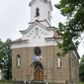 Zdjęcie nr 1: Kościół orientowany, murowany, trójnawowy, halowy, na rzucie prostokąta z wydłużonym, skierowanym na północ prezbiterium z dobudowaną zakrystią i skarbcem. Prezbiterium dwuprzęsłowe, węższe i niższe od korpusu, zamknięte prosto, z arkadową wnęką od strony wnętrza. Na łuku tęczowym napis „SERCE JEZUSA KRÓLOJ NAM”. Nawa główna oraz boczne trójprzęsłowe, rozdzielone masywnymi opilastrowanymi filarami; artykulacja ścian kontynuuje podziały sklepienia, którego szerokie gurty przechodzą w pilastry. Sklepienie prezbiterium oraz naw żagielkowe, przedzielone gurtami. Od południa chór muzyczny mieszczący się między pierwszymi filarami i powyżej kruchty wejściowej. W prezbiterium cztery okna w kształcie stojącego prostokąta zamknięte łukiem półkolistym oraz po dwa mniejsze, ale powtarzające ich kształt w skarbcu i zakrystii. W nawach bocznych po trzy okna wyznaczające środek każdego przęsła, naprzemiennie o opisanym kształcie oraz okulusy; w fasadzie powyżej wejścia okulus, wieża przepruta z każdej strony prostokątnym oknem zamkniętym półkoliście. Główne wejście od wschodu, po jednym od północy, południa, do zakrystii, do skarbca oraz między wymienionymi pomieszczeniami a prezbiterium. Ściany i sklepienia kościoła pokrywa polichromia skomponowana z dekoracji floralnych i floralno-geometrycznych oraz umieszczonych w jej obrębie symboli m.in. ewangelistów. Fasada wieżowa, trójosiowa, jednoprzęsłowa, z widocznym wątkiem kamiennym w dolnej i otynkowana w górnej części. Środkowa oś wyższa; podziały pionowe przeprowadzono za pomocą pilastrów, kondygnacje zamknięto gzymsem poziomym w osiach bocznych oraz wyniesionym i wyłamanym w środkowej. W osi środkowej portal w kształcie stojącego prostokąta zamkniętego łukiem półkolistym w szerokim rozglifieniu, a powyżej okulus. Zamykający kondygnacje trójkątny przyczółek dekorowany od dołu fryzem arkadkowym ułożonym schodkowo, ujmującym półokrągłą, konchową wnękę z figurą Matki Boskiej z Lourdes. W osiach bocznych większe wnęki powtarzające kształt opisanej, wypełnione figurami św. Cyryla i Metodego. Powyżej widoczna wieża, której kondygnacja jest przepruta oknami i zwieńczona gzymsem wyłamanym na osiach; w trójkątnych polach ślepe okulusy. Elewacje boczne z ciosu kamiennego przeprute jedynie oknami i portalami, zamknięte gzymsem o fryzie  wypełnionym prostokątnymi wnękami i gzymsie z ząbkowaniem. Nawy oraz prezbiterium przykrywają dachy dwuspadowe, zakrystię oraz skarbiec pulpitowe, wieżę namiotowy z fartuchem zwieńczony kulą z krzyżem. 
Do najciekawszych elementów wyposażenia należy neośredniowieczny ołtarz główny oraz rokokowa ambona z antyamboną. Najstarszym zabytkiem w posiadaniu kościoła św. Wojciecha jest tzw. „czarna Madonna” – umieszczona w późniejszym feretronie niewielka figurka Matki Boskiej z Dzieciątkiem pochodząca z XIV wieku. 
