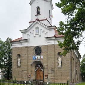 Zdjęcie nr 1: Kościół orientowany, murowany, trójnawowy, halowy, na rzucie prostokąta z wydłużonym, skierowanym na północ prezbiterium z dobudowaną zakrystią i skarbcem. Prezbiterium dwuprzęsłowe, węższe i niższe od korpusu, zamknięte prosto, z arkadową wnęką od strony wnętrza. Na łuku tęczowym napis „SERCE JEZUSA KRÓLOJ NAM”. Nawa główna oraz boczne trójprzęsłowe, rozdzielone masywnymi opilastrowanymi filarami; artykulacja ścian kontynuuje podziały sklepienia, którego szerokie gurty przechodzą w pilastry. Sklepienie prezbiterium oraz naw żagielkowe, przedzielone gurtami. Od południa chór muzyczny mieszczący się między pierwszymi filarami i powyżej kruchty wejściowej. W prezbiterium cztery okna w kształcie stojącego prostokąta zamknięte łukiem półkolistym oraz po dwa mniejsze, ale powtarzające ich kształt w skarbcu i zakrystii. W nawach bocznych po trzy okna wyznaczające środek każdego przęsła, naprzemiennie o opisanym kształcie oraz okulusy; w fasadzie powyżej wejścia okulus, wieża przepruta z każdej strony prostokątnym oknem zamkniętym półkoliście. Główne wejście od wschodu, po jednym od północy, południa, do zakrystii, do skarbca oraz między wymienionymi pomieszczeniami a prezbiterium. Ściany i sklepienia kościoła pokrywa polichromia skomponowana z dekoracji floralnych i floralno-geometrycznych oraz umieszczonych w jej obrębie symboli m.in. ewangelistów. Fasada wieżowa, trójosiowa, jednoprzęsłowa, z widocznym wątkiem kamiennym w dolnej i otynkowana w górnej części. Środkowa oś wyższa; podziały pionowe przeprowadzono za pomocą pilastrów, kondygnacje zamknięto gzymsem poziomym w osiach bocznych oraz wyniesionym i wyłamanym w środkowej. W osi środkowej portal w kształcie stojącego prostokąta zamkniętego łukiem półkolistym w szerokim rozglifieniu, a powyżej okulus. Zamykający kondygnacje trójkątny przyczółek dekorowany od dołu fryzem arkadkowym ułożonym schodkowo, ujmującym półokrągłą, konchową wnękę z figurą Matki Boskiej z Lourdes. W osiach bocznych większe wnęki powtarzające kształt opisanej, wypełnione figurami św. Cyryla i Metodego. Powyżej widoczna wieża, której kondygnacja jest przepruta oknami i zwieńczona gzymsem wyłamanym na osiach; w trójkątnych polach ślepe okulusy. Elewacje boczne z ciosu kamiennego przeprute jedynie oknami i portalami, zamknięte gzymsem o fryzie  wypełnionym prostokątnymi wnękami i gzymsie z ząbkowaniem. Nawy oraz prezbiterium przykrywają dachy dwuspadowe, zakrystię oraz skarbiec pulpitowe, wieżę namiotowy z fartuchem zwieńczony kulą z krzyżem. 
Do najciekawszych elementów wyposażenia należy neośredniowieczny ołtarz główny oraz rokokowa ambona z antyamboną. Najstarszym zabytkiem w posiadaniu kościoła św. Wojciecha jest tzw. „czarna Madonna” – umieszczona w późniejszym feretronie niewielka figurka Matki Boskiej z Dzieciątkiem pochodząca z XIV wieku. 
