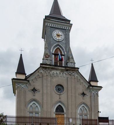 Zdjęcie nr 4: Kościół murowany, tynkowany, jednonawowy. Prezbiterium prostokątne, zamknięte prosto, z obu stron przy nawie prostokątne, piętrowe lokalności (zakrystia i skarbiec, empory). Nawa szersza od prezbiterium, na rzucie prostokąta, od frontu przylega wieża na planie kwadratu z dwoma aneksami po bokach. Prezbiterium dwuprzęsłowe, podzielone wewnątrz pilastrami, sklepione żagielkowo na gurtach. Empory flankowane parami półkolumienek, z oknami w formie leżącego prostokąta zamkniętego łukiem odcinkowym, nad lewą herb Odrowąż z inicjałami „JG”. Nawa nakryta pozornym, spłaszczonym sklepieniem kolebkowym. Otwór tęczowy w formie półkolistej arkady wspartej na pilastrach, z belką o fantazyjnym kształcie. Chór muzyczny dwukondygnacyjny, wsparty na dwóch filarach i dwóch półfilarach, pomiędzy którymi arkady ostrołukowe, kondygnacja zamknięta profilowanym gzymsem. Druga kondygnacja z trzema arkadami, w środkowej organ z wklęsło-wypukłą, ażurową balustradą. Posadzka z płyt ceramicznych. 
Fasada trójosiowa, dwukondygnacyjna. Pierwsza kondygnacja wydzielona pilastrami dekorowanymi blendami, zwieńczona profilowanym gzymsem z fryzem arkadkowym. Nad pilastrami osi bocznych dwie stylizowane wieżyczki, zakończone krzyżami. 
Na każdej osi ostrołukowe arkady, w środkowej wejście, dwie boczne wypełnione stylizowanymi blendami; nad nimi otwory okienne. Na osi środkowej, w drugiej kondygnacji wieża, ujęta w narożach czterema wieżyczkami, ścianki flankowane lizenami, zakończona profilowanym gzymsem z kostkowaniem. Na ściankach z czterech stron tarcze zegarowe oraz otwory dzwonne w formie ostrołukowych arkad w opaskach tynkowych. Wieża nakryta dachem ostrosłupowym. 
Elewacje gładkie, tynkowane zakończone profilowanym gzymsem. Wyodrębnione aneksy elewacji bocznych ujęte grubymi lizenami, z ostrołukowymi arkadami w polu, ujętymi opaskami tynkowymi. Od strony fasady w partiach aneksów bocznych wejścia do kościoła, od strony prezbiterium ostrołukowe okienka. Na każdej elewacji bocznej po trzy okna w formie stojącego prostokąta zamkniętego łukiem półkolistym, o szerokich rozglifieniach, po dwa w nawie i jednym w prezbiterium. Elewacja zamykająca prezbiterium trójosiowa, wydzielona lizenami, z głębokimi wnękami w formie stojącego prostokąta zamkniętego łukiem półkolistym, z namalowanym wizerunkiem Ukrzyżowanego Chrystusa i dwóch łotrów na krzyżach. Elewacja zakończona profilowanym gzymsem, z daszkiem pulpitowym oraz trójkątnym szczytem z czterema cokołami. Nawa i prezbiterium nakryte osobnymi  dachami dwuspadowymi. Na połączeniu nawy i aneksów przy prezbiterium wieżyczka na sygnaturkę z latarnią, nakryta dachem ostrosłupowym. 


