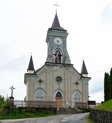 Zdjęcie nr 2: Kościół murowany, tynkowany, jednonawowy. Prezbiterium prostokątne, zamknięte prosto, z obu stron przy nawie prostokątne, piętrowe lokalności (zakrystia i skarbiec, empory). Nawa szersza od prezbiterium, na rzucie prostokąta, od frontu przylega wieża na planie kwadratu z dwoma aneksami po bokach. Prezbiterium dwuprzęsłowe, podzielone wewnątrz pilastrami, sklepione żagielkowo na gurtach. Empory flankowane parami półkolumienek, z oknami w formie leżącego prostokąta zamkniętego łukiem odcinkowym, nad lewą herb Odrowąż z inicjałami „JG”. Nawa nakryta pozornym, spłaszczonym sklepieniem kolebkowym. Otwór tęczowy w formie półkolistej arkady wspartej na pilastrach, z belką o fantazyjnym kształcie. Chór muzyczny dwukondygnacyjny, wsparty na dwóch filarach i dwóch półfilarach, pomiędzy którymi arkady ostrołukowe, kondygnacja zamknięta profilowanym gzymsem. Druga kondygnacja z trzema arkadami, w środkowej organ z wklęsło-wypukłą, ażurową balustradą. Posadzka z płyt ceramicznych. 
Fasada trójosiowa, dwukondygnacyjna. Pierwsza kondygnacja wydzielona pilastrami dekorowanymi blendami, zwieńczona profilowanym gzymsem z fryzem arkadkowym. Nad pilastrami osi bocznych dwie stylizowane wieżyczki, zakończone krzyżami. 
Na każdej osi ostrołukowe arkady, w środkowej wejście, dwie boczne wypełnione stylizowanymi blendami; nad nimi otwory okienne. Na osi środkowej, w drugiej kondygnacji wieża, ujęta w narożach czterema wieżyczkami, ścianki flankowane lizenami, zakończona profilowanym gzymsem z kostkowaniem. Na ściankach z czterech stron tarcze zegarowe oraz otwory dzwonne w formie ostrołukowych arkad w opaskach tynkowych. Wieża nakryta dachem ostrosłupowym. 
Elewacje gładkie, tynkowane zakończone profilowanym gzymsem. Wyodrębnione aneksy elewacji bocznych ujęte grubymi lizenami, z ostrołukowymi arkadami w polu, ujętymi opaskami tynkowymi. Od strony fasady w partiach aneksów bocznych wejścia do kościoła, od strony prezbiterium ostrołukowe okienka. Na każdej elewacji bocznej po trzy okna w formie stojącego prostokąta zamkniętego łukiem półkolistym, o szerokich rozglifieniach, po dwa w nawie i jednym w prezbiterium. Elewacja zamykająca prezbiterium trójosiowa, wydzielona lizenami, z głębokimi wnękami w formie stojącego prostokąta zamkniętego łukiem półkolistym, z namalowanym wizerunkiem Ukrzyżowanego Chrystusa i dwóch łotrów na krzyżach. Elewacja zakończona profilowanym gzymsem, z daszkiem pulpitowym oraz trójkątnym szczytem z czterema cokołami. Nawa i prezbiterium nakryte osobnymi  dachami dwuspadowymi. Na połączeniu nawy i aneksów przy prezbiterium wieżyczka na sygnaturkę z latarnią, nakryta dachem ostrosłupowym. 


