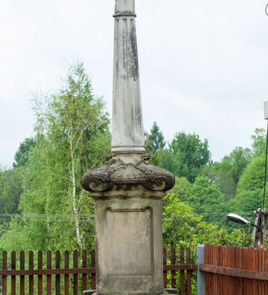 Zdjęcie nr 21: Kościół murowany, tynkowany, jednonawowy. Prezbiterium prostokątne, zamknięte prosto, z obu stron przy nawie prostokątne, piętrowe lokalności (zakrystia i skarbiec, empory). Nawa szersza od prezbiterium, na rzucie prostokąta, od frontu przylega wieża na planie kwadratu z dwoma aneksami po bokach. Prezbiterium dwuprzęsłowe, podzielone wewnątrz pilastrami, sklepione żagielkowo na gurtach. Empory flankowane parami półkolumienek, z oknami w formie leżącego prostokąta zamkniętego łukiem odcinkowym, nad lewą herb Odrowąż z inicjałami „JG”. Nawa nakryta pozornym, spłaszczonym sklepieniem kolebkowym. Otwór tęczowy w formie półkolistej arkady wspartej na pilastrach, z belką o fantazyjnym kształcie. Chór muzyczny dwukondygnacyjny, wsparty na dwóch filarach i dwóch półfilarach, pomiędzy którymi arkady ostrołukowe, kondygnacja zamknięta profilowanym gzymsem. Druga kondygnacja z trzema arkadami, w środkowej organ z wklęsło-wypukłą, ażurową balustradą. Posadzka z płyt ceramicznych. 
Fasada trójosiowa, dwukondygnacyjna. Pierwsza kondygnacja wydzielona pilastrami dekorowanymi blendami, zwieńczona profilowanym gzymsem z fryzem arkadkowym. Nad pilastrami osi bocznych dwie stylizowane wieżyczki, zakończone krzyżami. 
Na każdej osi ostrołukowe arkady, w środkowej wejście, dwie boczne wypełnione stylizowanymi blendami; nad nimi otwory okienne. Na osi środkowej, w drugiej kondygnacji wieża, ujęta w narożach czterema wieżyczkami, ścianki flankowane lizenami, zakończona profilowanym gzymsem z kostkowaniem. Na ściankach z czterech stron tarcze zegarowe oraz otwory dzwonne w formie ostrołukowych arkad w opaskach tynkowych. Wieża nakryta dachem ostrosłupowym. 
Elewacje gładkie, tynkowane zakończone profilowanym gzymsem. Wyodrębnione aneksy elewacji bocznych ujęte grubymi lizenami, z ostrołukowymi arkadami w polu, ujętymi opaskami tynkowymi. Od strony fasady w partiach aneksów bocznych wejścia do kościoła, od strony prezbiterium ostrołukowe okienka. Na każdej elewacji bocznej po trzy okna w formie stojącego prostokąta zamkniętego łukiem półkolistym, o szerokich rozglifieniach, po dwa w nawie i jednym w prezbiterium. Elewacja zamykająca prezbiterium trójosiowa, wydzielona lizenami, z głębokimi wnękami w formie stojącego prostokąta zamkniętego łukiem półkolistym, z namalowanym wizerunkiem Ukrzyżowanego Chrystusa i dwóch łotrów na krzyżach. Elewacja zakończona profilowanym gzymsem, z daszkiem pulpitowym oraz trójkątnym szczytem z czterema cokołami. Nawa i prezbiterium nakryte osobnymi  dachami dwuspadowymi. Na połączeniu nawy i aneksów przy prezbiterium wieżyczka na sygnaturkę z latarnią, nakryta dachem ostrosłupowym. 


