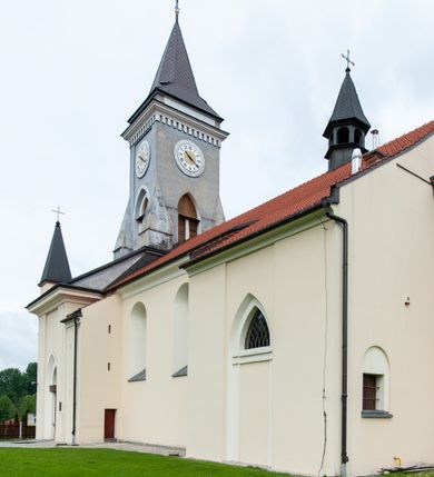 Zdjęcie nr 11: Kościół murowany, tynkowany, jednonawowy. Prezbiterium prostokątne, zamknięte prosto, z obu stron przy nawie prostokątne, piętrowe lokalności (zakrystia i skarbiec, empory). Nawa szersza od prezbiterium, na rzucie prostokąta, od frontu przylega wieża na planie kwadratu z dwoma aneksami po bokach. Prezbiterium dwuprzęsłowe, podzielone wewnątrz pilastrami, sklepione żagielkowo na gurtach. Empory flankowane parami półkolumienek, z oknami w formie leżącego prostokąta zamkniętego łukiem odcinkowym, nad lewą herb Odrowąż z inicjałami „JG”. Nawa nakryta pozornym, spłaszczonym sklepieniem kolebkowym. Otwór tęczowy w formie półkolistej arkady wspartej na pilastrach, z belką o fantazyjnym kształcie. Chór muzyczny dwukondygnacyjny, wsparty na dwóch filarach i dwóch półfilarach, pomiędzy którymi arkady ostrołukowe, kondygnacja zamknięta profilowanym gzymsem. Druga kondygnacja z trzema arkadami, w środkowej organ z wklęsło-wypukłą, ażurową balustradą. Posadzka z płyt ceramicznych. 
Fasada trójosiowa, dwukondygnacyjna. Pierwsza kondygnacja wydzielona pilastrami dekorowanymi blendami, zwieńczona profilowanym gzymsem z fryzem arkadkowym. Nad pilastrami osi bocznych dwie stylizowane wieżyczki, zakończone krzyżami. 
Na każdej osi ostrołukowe arkady, w środkowej wejście, dwie boczne wypełnione stylizowanymi blendami; nad nimi otwory okienne. Na osi środkowej, w drugiej kondygnacji wieża, ujęta w narożach czterema wieżyczkami, ścianki flankowane lizenami, zakończona profilowanym gzymsem z kostkowaniem. Na ściankach z czterech stron tarcze zegarowe oraz otwory dzwonne w formie ostrołukowych arkad w opaskach tynkowych. Wieża nakryta dachem ostrosłupowym. 
Elewacje gładkie, tynkowane zakończone profilowanym gzymsem. Wyodrębnione aneksy elewacji bocznych ujęte grubymi lizenami, z ostrołukowymi arkadami w polu, ujętymi opaskami tynkowymi. Od strony fasady w partiach aneksów bocznych wejścia do kościoła, od strony prezbiterium ostrołukowe okienka. Na każdej elewacji bocznej po trzy okna w formie stojącego prostokąta zamkniętego łukiem półkolistym, o szerokich rozglifieniach, po dwa w nawie i jednym w prezbiterium. Elewacja zamykająca prezbiterium trójosiowa, wydzielona lizenami, z głębokimi wnękami w formie stojącego prostokąta zamkniętego łukiem półkolistym, z namalowanym wizerunkiem Ukrzyżowanego Chrystusa i dwóch łotrów na krzyżach. Elewacja zakończona profilowanym gzymsem, z daszkiem pulpitowym oraz trójkątnym szczytem z czterema cokołami. Nawa i prezbiterium nakryte osobnymi  dachami dwuspadowymi. Na połączeniu nawy i aneksów przy prezbiterium wieżyczka na sygnaturkę z latarnią, nakryta dachem ostrosłupowym. 



