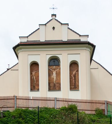 Zdjęcie nr 14: Kościół murowany, tynkowany, jednonawowy. Prezbiterium prostokątne, zamknięte prosto, z obu stron przy nawie prostokątne, piętrowe lokalności (zakrystia i skarbiec, empory). Nawa szersza od prezbiterium, na rzucie prostokąta, od frontu przylega wieża na planie kwadratu z dwoma aneksami po bokach. Prezbiterium dwuprzęsłowe, podzielone wewnątrz pilastrami, sklepione żagielkowo na gurtach. Empory flankowane parami półkolumienek, z oknami w formie leżącego prostokąta zamkniętego łukiem odcinkowym, nad lewą herb Odrowąż z inicjałami „JG”. Nawa nakryta pozornym, spłaszczonym sklepieniem kolebkowym. Otwór tęczowy w formie półkolistej arkady wspartej na pilastrach, z belką o fantazyjnym kształcie. Chór muzyczny dwukondygnacyjny, wsparty na dwóch filarach i dwóch półfilarach, pomiędzy którymi arkady ostrołukowe, kondygnacja zamknięta profilowanym gzymsem. Druga kondygnacja z trzema arkadami, w środkowej organ z wklęsło-wypukłą, ażurową balustradą. Posadzka z płyt ceramicznych. 
Fasada trójosiowa, dwukondygnacyjna. Pierwsza kondygnacja wydzielona pilastrami dekorowanymi blendami, zwieńczona profilowanym gzymsem z fryzem arkadkowym. Nad pilastrami osi bocznych dwie stylizowane wieżyczki, zakończone krzyżami. 
Na każdej osi ostrołukowe arkady, w środkowej wejście, dwie boczne wypełnione stylizowanymi blendami; nad nimi otwory okienne. Na osi środkowej, w drugiej kondygnacji wieża, ujęta w narożach czterema wieżyczkami, ścianki flankowane lizenami, zakończona profilowanym gzymsem z kostkowaniem. Na ściankach z czterech stron tarcze zegarowe oraz otwory dzwonne w formie ostrołukowych arkad w opaskach tynkowych. Wieża nakryta dachem ostrosłupowym. 
Elewacje gładkie, tynkowane zakończone profilowanym gzymsem. Wyodrębnione aneksy elewacji bocznych ujęte grubymi lizenami, z ostrołukowymi arkadami w polu, ujętymi opaskami tynkowymi. Od strony fasady w partiach aneksów bocznych wejścia do kościoła, od strony prezbiterium ostrołukowe okienka. Na każdej elewacji bocznej po trzy okna w formie stojącego prostokąta zamkniętego łukiem półkolistym, o szerokich rozglifieniach, po dwa w nawie i jednym w prezbiterium. Elewacja zamykająca prezbiterium trójosiowa, wydzielona lizenami, z głębokimi wnękami w formie stojącego prostokąta zamkniętego łukiem półkolistym, z namalowanym wizerunkiem Ukrzyżowanego Chrystusa i dwóch łotrów na krzyżach. Elewacja zakończona profilowanym gzymsem, z daszkiem pulpitowym oraz trójkątnym szczytem z czterema cokołami. Nawa i prezbiterium nakryte osobnymi  dachami dwuspadowymi. Na połączeniu nawy i aneksów przy prezbiterium wieżyczka na sygnaturkę z latarnią, nakryta dachem ostrosłupowym. 


