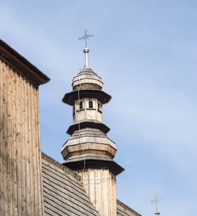 Zdjęcie nr 25: Kościół Nawiedzenia Najświętszej Marii Panny jest usytuowany w centrum wsi, na południe od głównej drogi wiodącej przez Paczółtowice. Teren przykościelny z umiejscowionym w północnej części cmentarzem otacza niewysoki, kamienny i częściowo ceglany mur nakryty dwuspadowym daszkiem. Prowadzą do niego dwa wejścia – usytuowana w północno-zachodnim narożniku muru brama z figurami Matki Boskiej i Chrystusa oraz nieco skromniejsze wejście od strony południowej. W północno-wschodniej części placu przykościelnego znajduje się wolnostojąca dzwonnica założona na planie czworoboku. Natomiast w części południowo-wschodniej umiejscowiona jest kamienna grota mieszcząca figurę Matki Boskiej z Lourdes. Kościół paczółtowicki to niewielkich rozmiarów, orientowana i jednonawowa budowla o konstrukcji drewnianej; kryta gontem. Fundamenty świątyni są murowane i tynkowane, odsadzkę pomiędzy fundamentem i zrębem przykrywa niewielki okap z gontu. Ściany zewnętrzne kościoła oszalowano pionowymi deskami z nabitymi dla wzmocnienia listwami. Zamknięte wielobocznie prezbiterium, przekryte dachem trójpołaciowym przylega do nieco szerszej nawy założonej na rzucie zbliżonym do kwadratu. Nawa nakryta jest dachem dwuspadowym. Prowadzą do niej dwa wejścia: główne, od zachodu, spod wieży i od strony południowej. Okna wychodzą wyłącznie na południe i umieszczone są parami w nawie, z zachowanymi oryginalnymi obramieniami i w prezbiterium, gdzie były zmienione w czasie późniejszym. Przy prezbiterium od strony północnej znajduje się zakrystia na rzucie prostokąta nakryta jednospadowym dachem; dostępna od strony wschodniej. Do nawy od strony południowej przylega niewielka kruchta również na rzucie prostokąta, nakryta dwuspadowym dachem. W elewacji zachodniej znajduje się kwadratowa wieża dzwonna o ścianach lekko pochyłych, w połowie wysokości podzielonych gzymsem. Nakryta jest hełmem o kształcie daszka namiotowego zamkniętego od góry cebulastą kopułką zwieńczoną krzyżem. W zachodniej ścianie wieży znajduje się wejście główne do kościoła przykryte daszkiem dwuspadowym. Na ścianie południowej dwa okna zwieńczone trójkątnymi daszkami. Od strony północnej, zachodniej i południowej po jednym oknie umiejscowionym pod dachem wieży. Ośmioboczna wieżyczka na sygnaturkę nakryta jest rozbudowanym, barokowym hełmem z pseudoglorietą również zwieńczonym krzyżem. Nawa i prezbiterium przekryte  są wspólnym stropem (w nawie z zaskrzynieniami; belki zaskrzynień profilowane). Między nawą a prezbiterium mieści się ściana tęczowa z otworem tęczowym w formie ostrołukowej arkady. Na wysokości trzech czwartych wysokości nawy umieszczona jest poprzeczna belka tęczowa. W zachodniej części nawy znajduje się drewniany chór muzyczny wsparty na profilowanych, drewnianych kolumnach. Odrzwia w nawie od zachodu i południa z nadprożami wyciętymi w ośli grzbiet; okna w nawie z nadokiennikami o takim samym wykroju. Drzwi prowadzące z prezbiterium do zakrystii żelazne z listwami w skośną kratę, z antabą i zamkiem. Posadzka w nawie i prezbiterium marmurowa.
