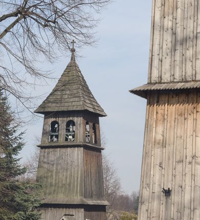 Zdjęcie nr 6: Kościół Nawiedzenia Najświętszej Marii Panny jest usytuowany w centrum wsi, na południe od głównej drogi wiodącej przez Paczółtowice. Teren przykościelny z umiejscowionym w północnej części cmentarzem otacza niewysoki, kamienny i częściowo ceglany mur nakryty dwuspadowym daszkiem. Prowadzą do niego dwa wejścia – usytuowana w północno-zachodnim narożniku muru brama z figurami Matki Boskiej i Chrystusa oraz nieco skromniejsze wejście od strony południowej. W północno-wschodniej części placu przykościelnego znajduje się wolnostojąca dzwonnica założona na planie czworoboku. Natomiast w części południowo-wschodniej umiejscowiona jest kamienna grota mieszcząca figurę Matki Boskiej z Lourdes. Kościół paczółtowicki to niewielkich rozmiarów, orientowana i jednonawowa budowla o konstrukcji drewnianej; kryta gontem. Fundamenty świątyni są murowane i tynkowane, odsadzkę pomiędzy fundamentem i zrębem przykrywa niewielki okap z gontu. Ściany zewnętrzne kościoła oszalowano pionowymi deskami z nabitymi dla wzmocnienia listwami. Zamknięte wielobocznie prezbiterium, przekryte dachem trójpołaciowym przylega do nieco szerszej nawy założonej na rzucie zbliżonym do kwadratu. Nawa nakryta jest dachem dwuspadowym. Prowadzą do niej dwa wejścia: główne, od zachodu, spod wieży i od strony południowej. Okna wychodzą wyłącznie na południe i umieszczone są parami w nawie, z zachowanymi oryginalnymi obramieniami i w prezbiterium, gdzie były zmienione w czasie późniejszym. Przy prezbiterium od strony północnej znajduje się zakrystia na rzucie prostokąta nakryta jednospadowym dachem; dostępna od strony wschodniej. Do nawy od strony południowej przylega niewielka kruchta również na rzucie prostokąta, nakryta dwuspadowym dachem. W elewacji zachodniej znajduje się kwadratowa wieża dzwonna o ścianach lekko pochyłych, w połowie wysokości podzielonych gzymsem. Nakryta jest hełmem o kształcie daszka namiotowego zamkniętego od góry cebulastą kopułką zwieńczoną krzyżem. W zachodniej ścianie wieży znajduje się wejście główne do kościoła przykryte daszkiem dwuspadowym. Na ścianie południowej dwa okna zwieńczone trójkątnymi daszkami. Od strony północnej, zachodniej i południowej po jednym oknie umiejscowionym pod dachem wieży. Ośmioboczna wieżyczka na sygnaturkę nakryta jest rozbudowanym, barokowym hełmem z pseudoglorietą również zwieńczonym krzyżem. Nawa i prezbiterium przekryte  są wspólnym stropem (w nawie z zaskrzynieniami; belki zaskrzynień profilowane). Między nawą a prezbiterium mieści się ściana tęczowa z otworem tęczowym w formie ostrołukowej arkady. Na wysokości trzech czwartych wysokości nawy umieszczona jest poprzeczna belka tęczowa. W zachodniej części nawy znajduje się drewniany chór muzyczny wsparty na profilowanych, drewnianych kolumnach. Odrzwia w nawie od zachodu i południa z nadprożami wyciętymi w ośli grzbiet; okna w nawie z nadokiennikami o takim samym wykroju. Drzwi prowadzące z prezbiterium do zakrystii żelazne z listwami w skośną kratę, z antabą i zamkiem. Posadzka w nawie i prezbiterium marmurowa.
