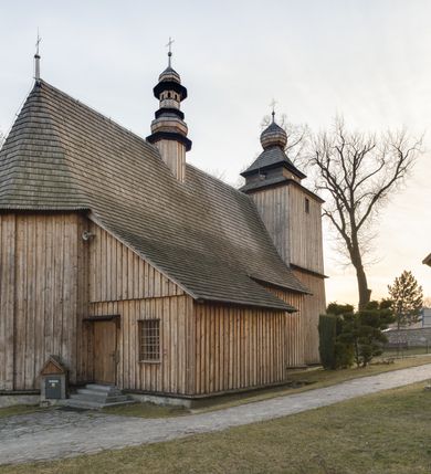 Zdjęcie nr 13: Kościół Nawiedzenia Najświętszej Marii Panny jest usytuowany w centrum wsi, na południe od głównej drogi wiodącej przez Paczółtowice. Teren przykościelny z umiejscowionym w północnej części cmentarzem otacza niewysoki, kamienny i częściowo ceglany mur nakryty dwuspadowym daszkiem. Prowadzą do niego dwa wejścia – usytuowana w północno-zachodnim narożniku muru brama z figurami Matki Boskiej i Chrystusa oraz nieco skromniejsze wejście od strony południowej. W północno-wschodniej części placu przykościelnego znajduje się wolnostojąca dzwonnica założona na planie czworoboku. Natomiast w części południowo-wschodniej umiejscowiona jest kamienna grota mieszcząca figurę Matki Boskiej z Lourdes. Kościół paczółtowicki to niewielkich rozmiarów, orientowana i jednonawowa budowla o konstrukcji drewnianej; kryta gontem. Fundamenty świątyni są murowane i tynkowane, odsadzkę pomiędzy fundamentem i zrębem przykrywa niewielki okap z gontu. Ściany zewnętrzne kościoła oszalowano pionowymi deskami z nabitymi dla wzmocnienia listwami. Zamknięte wielobocznie prezbiterium, przekryte dachem trójpołaciowym przylega do nieco szerszej nawy założonej na rzucie zbliżonym do kwadratu. Nawa nakryta jest dachem dwuspadowym. Prowadzą do niej dwa wejścia: główne, od zachodu, spod wieży i od strony południowej. Okna wychodzą wyłącznie na południe i umieszczone są parami w nawie, z zachowanymi oryginalnymi obramieniami i w prezbiterium, gdzie były zmienione w czasie późniejszym. Przy prezbiterium od strony północnej znajduje się zakrystia na rzucie prostokąta nakryta jednospadowym dachem; dostępna od strony wschodniej. Do nawy od strony południowej przylega niewielka kruchta również na rzucie prostokąta, nakryta dwuspadowym dachem. W elewacji zachodniej znajduje się kwadratowa wieża dzwonna o ścianach lekko pochyłych, w połowie wysokości podzielonych gzymsem. Nakryta jest hełmem o kształcie daszka namiotowego zamkniętego od góry cebulastą kopułką zwieńczoną krzyżem. W zachodniej ścianie wieży znajduje się wejście główne do kościoła przykryte daszkiem dwuspadowym. Na ścianie południowej dwa okna zwieńczone trójkątnymi daszkami. Od strony północnej, zachodniej i południowej po jednym oknie umiejscowionym pod dachem wieży. Ośmioboczna wieżyczka na sygnaturkę nakryta jest rozbudowanym, barokowym hełmem z pseudoglorietą również zwieńczonym krzyżem. Nawa i prezbiterium przekryte  są wspólnym stropem (w nawie z zaskrzynieniami; belki zaskrzynień profilowane). Między nawą a prezbiterium mieści się ściana tęczowa z otworem tęczowym w formie ostrołukowej arkady. Na wysokości trzech czwartych wysokości nawy umieszczona jest poprzeczna belka tęczowa. W zachodniej części nawy znajduje się drewniany chór muzyczny wsparty na profilowanych, drewnianych kolumnach. Odrzwia w nawie od zachodu i południa z nadprożami wyciętymi w ośli grzbiet; okna w nawie z nadokiennikami o takim samym wykroju. Drzwi prowadzące z prezbiterium do zakrystii żelazne z listwami w skośną kratę, z antabą i zamkiem. Posadzka w nawie i prezbiterium marmurowa.

