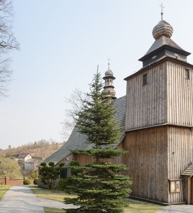 Zdjęcie nr 29: Kościół Nawiedzenia Najświętszej Marii Panny jest usytuowany w centrum wsi, na południe od głównej drogi wiodącej przez Paczółtowice. Teren przykościelny z umiejscowionym w północnej części cmentarzem otacza niewysoki, kamienny i częściowo ceglany mur nakryty dwuspadowym daszkiem. Prowadzą do niego dwa wejścia – usytuowana w północno-zachodnim narożniku muru brama z figurami Matki Boskiej i Chrystusa oraz nieco skromniejsze wejście od strony południowej. W północno-wschodniej części placu przykościelnego znajduje się wolnostojąca dzwonnica założona na planie czworoboku. Natomiast w części południowo-wschodniej umiejscowiona jest kamienna grota mieszcząca figurę Matki Boskiej z Lourdes. Kościół paczółtowicki to niewielkich rozmiarów, orientowana i jednonawowa budowla o konstrukcji drewnianej; kryta gontem. Fundamenty świątyni są murowane i tynkowane, odsadzkę pomiędzy fundamentem i zrębem przykrywa niewielki okap z gontu. Ściany zewnętrzne kościoła oszalowano pionowymi deskami z nabitymi dla wzmocnienia listwami. Zamknięte wielobocznie prezbiterium, przekryte dachem trójpołaciowym przylega do nieco szerszej nawy założonej na rzucie zbliżonym do kwadratu. Nawa nakryta jest dachem dwuspadowym. Prowadzą do niej dwa wejścia: główne, od zachodu, spod wieży i od strony południowej. Okna wychodzą wyłącznie na południe i umieszczone są parami w nawie, z zachowanymi oryginalnymi obramieniami i w prezbiterium, gdzie były zmienione w czasie późniejszym. Przy prezbiterium od strony północnej znajduje się zakrystia na rzucie prostokąta nakryta jednospadowym dachem; dostępna od strony wschodniej. Do nawy od strony południowej przylega niewielka kruchta również na rzucie prostokąta, nakryta dwuspadowym dachem. W elewacji zachodniej znajduje się kwadratowa wieża dzwonna o ścianach lekko pochyłych, w połowie wysokości podzielonych gzymsem. Nakryta jest hełmem o kształcie daszka namiotowego zamkniętego od góry cebulastą kopułką zwieńczoną krzyżem. W zachodniej ścianie wieży znajduje się wejście główne do kościoła przykryte daszkiem dwuspadowym. Na ścianie południowej dwa okna zwieńczone trójkątnymi daszkami. Od strony północnej, zachodniej i południowej po jednym oknie umiejscowionym pod dachem wieży. Ośmioboczna wieżyczka na sygnaturkę nakryta jest rozbudowanym, barokowym hełmem z pseudoglorietą również zwieńczonym krzyżem. Nawa i prezbiterium przekryte  są wspólnym stropem (w nawie z zaskrzynieniami; belki zaskrzynień profilowane). Między nawą a prezbiterium mieści się ściana tęczowa z otworem tęczowym w formie ostrołukowej arkady. Na wysokości trzech czwartych wysokości nawy umieszczona jest poprzeczna belka tęczowa. W zachodniej części nawy znajduje się drewniany chór muzyczny wsparty na profilowanych, drewnianych kolumnach. Odrzwia w nawie od zachodu i południa z nadprożami wyciętymi w ośli grzbiet; okna w nawie z nadokiennikami o takim samym wykroju. Drzwi prowadzące z prezbiterium do zakrystii żelazne z listwami w skośną kratę, z antabą i zamkiem. Posadzka w nawie i prezbiterium marmurowa.
