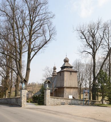 Zdjęcie nr 28: Kościół Nawiedzenia Najświętszej Marii Panny jest usytuowany w centrum wsi, na południe od głównej drogi wiodącej przez Paczółtowice. Teren przykościelny z umiejscowionym w północnej części cmentarzem otacza niewysoki, kamienny i częściowo ceglany mur nakryty dwuspadowym daszkiem. Prowadzą do niego dwa wejścia – usytuowana w północno-zachodnim narożniku muru brama z figurami Matki Boskiej i Chrystusa oraz nieco skromniejsze wejście od strony południowej. W północno-wschodniej części placu przykościelnego znajduje się wolnostojąca dzwonnica założona na planie czworoboku. Natomiast w części południowo-wschodniej umiejscowiona jest kamienna grota mieszcząca figurę Matki Boskiej z Lourdes. Kościół paczółtowicki to niewielkich rozmiarów, orientowana i jednonawowa budowla o konstrukcji drewnianej; kryta gontem. Fundamenty świątyni są murowane i tynkowane, odsadzkę pomiędzy fundamentem i zrębem przykrywa niewielki okap z gontu. Ściany zewnętrzne kościoła oszalowano pionowymi deskami z nabitymi dla wzmocnienia listwami. Zamknięte wielobocznie prezbiterium, przekryte dachem trójpołaciowym przylega do nieco szerszej nawy założonej na rzucie zbliżonym do kwadratu. Nawa nakryta jest dachem dwuspadowym. Prowadzą do niej dwa wejścia: główne, od zachodu, spod wieży i od strony południowej. Okna wychodzą wyłącznie na południe i umieszczone są parami w nawie, z zachowanymi oryginalnymi obramieniami i w prezbiterium, gdzie były zmienione w czasie późniejszym. Przy prezbiterium od strony północnej znajduje się zakrystia na rzucie prostokąta nakryta jednospadowym dachem; dostępna od strony wschodniej. Do nawy od strony południowej przylega niewielka kruchta również na rzucie prostokąta, nakryta dwuspadowym dachem. W elewacji zachodniej znajduje się kwadratowa wieża dzwonna o ścianach lekko pochyłych, w połowie wysokości podzielonych gzymsem. Nakryta jest hełmem o kształcie daszka namiotowego zamkniętego od góry cebulastą kopułką zwieńczoną krzyżem. W zachodniej ścianie wieży znajduje się wejście główne do kościoła przykryte daszkiem dwuspadowym. Na ścianie południowej dwa okna zwieńczone trójkątnymi daszkami. Od strony północnej, zachodniej i południowej po jednym oknie umiejscowionym pod dachem wieży. Ośmioboczna wieżyczka na sygnaturkę nakryta jest rozbudowanym, barokowym hełmem z pseudoglorietą również zwieńczonym krzyżem. Nawa i prezbiterium przekryte  są wspólnym stropem (w nawie z zaskrzynieniami; belki zaskrzynień profilowane). Między nawą a prezbiterium mieści się ściana tęczowa z otworem tęczowym w formie ostrołukowej arkady. Na wysokości trzech czwartych wysokości nawy umieszczona jest poprzeczna belka tęczowa. W zachodniej części nawy znajduje się drewniany chór muzyczny wsparty na profilowanych, drewnianych kolumnach. Odrzwia w nawie od zachodu i południa z nadprożami wyciętymi w ośli grzbiet; okna w nawie z nadokiennikami o takim samym wykroju. Drzwi prowadzące z prezbiterium do zakrystii żelazne z listwami w skośną kratę, z antabą i zamkiem. Posadzka w nawie i prezbiterium marmurowa.
