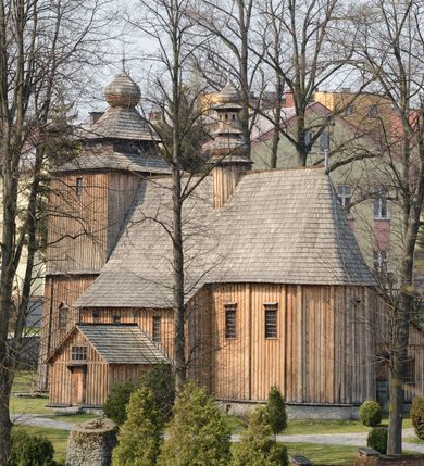 Zdjęcie nr 27: Kościół Nawiedzenia Najświętszej Marii Panny jest usytuowany w centrum wsi, na południe od głównej drogi wiodącej przez Paczółtowice. Teren przykościelny z umiejscowionym w północnej części cmentarzem otacza niewysoki, kamienny i częściowo ceglany mur nakryty dwuspadowym daszkiem. Prowadzą do niego dwa wejścia – usytuowana w północno-zachodnim narożniku muru brama z figurami Matki Boskiej i Chrystusa oraz nieco skromniejsze wejście od strony południowej. W północno-wschodniej części placu przykościelnego znajduje się wolnostojąca dzwonnica założona na planie czworoboku. Natomiast w części południowo-wschodniej umiejscowiona jest kamienna grota mieszcząca figurę Matki Boskiej z Lourdes. Kościół paczółtowicki to niewielkich rozmiarów, orientowana i jednonawowa budowla o konstrukcji drewnianej; kryta gontem. Fundamenty świątyni są murowane i tynkowane, odsadzkę pomiędzy fundamentem i zrębem przykrywa niewielki okap z gontu. Ściany zewnętrzne kościoła oszalowano pionowymi deskami z nabitymi dla wzmocnienia listwami. Zamknięte wielobocznie prezbiterium, przekryte dachem trójpołaciowym przylega do nieco szerszej nawy założonej na rzucie zbliżonym do kwadratu. Nawa nakryta jest dachem dwuspadowym. Prowadzą do niej dwa wejścia: główne, od zachodu, spod wieży i od strony południowej. Okna wychodzą wyłącznie na południe i umieszczone są parami w nawie, z zachowanymi oryginalnymi obramieniami i w prezbiterium, gdzie były zmienione w czasie późniejszym. Przy prezbiterium od strony północnej znajduje się zakrystia na rzucie prostokąta nakryta jednospadowym dachem; dostępna od strony wschodniej. Do nawy od strony południowej przylega niewielka kruchta również na rzucie prostokąta, nakryta dwuspadowym dachem. W elewacji zachodniej znajduje się kwadratowa wieża dzwonna o ścianach lekko pochyłych, w połowie wysokości podzielonych gzymsem. Nakryta jest hełmem o kształcie daszka namiotowego zamkniętego od góry cebulastą kopułką zwieńczoną krzyżem. W zachodniej ścianie wieży znajduje się wejście główne do kościoła przykryte daszkiem dwuspadowym. Na ścianie południowej dwa okna zwieńczone trójkątnymi daszkami. Od strony północnej, zachodniej i południowej po jednym oknie umiejscowionym pod dachem wieży. Ośmioboczna wieżyczka na sygnaturkę nakryta jest rozbudowanym, barokowym hełmem z pseudoglorietą również zwieńczonym krzyżem. Nawa i prezbiterium przekryte  są wspólnym stropem (w nawie z zaskrzynieniami; belki zaskrzynień profilowane). Między nawą a prezbiterium mieści się ściana tęczowa z otworem tęczowym w formie ostrołukowej arkady. Na wysokości trzech czwartych wysokości nawy umieszczona jest poprzeczna belka tęczowa. W zachodniej części nawy znajduje się drewniany chór muzyczny wsparty na profilowanych, drewnianych kolumnach. Odrzwia w nawie od zachodu i południa z nadprożami wyciętymi w ośli grzbiet; okna w nawie z nadokiennikami o takim samym wykroju. Drzwi prowadzące z prezbiterium do zakrystii żelazne z listwami w skośną kratę, z antabą i zamkiem. Posadzka w nawie i prezbiterium marmurowa.
