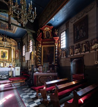 Zdjęcie nr 17: Kościół Nawiedzenia Najświętszej Marii Panny jest usytuowany w centrum wsi, na południe od głównej drogi wiodącej przez Paczółtowice. Teren przykościelny z umiejscowionym w północnej części cmentarzem otacza niewysoki, kamienny i częściowo ceglany mur nakryty dwuspadowym daszkiem. Prowadzą do niego dwa wejścia – usytuowana w północno-zachodnim narożniku muru brama z figurami Matki Boskiej i Chrystusa oraz nieco skromniejsze wejście od strony południowej. W północno-wschodniej części placu przykościelnego znajduje się wolnostojąca dzwonnica założona na planie czworoboku. Natomiast w części południowo-wschodniej umiejscowiona jest kamienna grota mieszcząca figurę Matki Boskiej z Lourdes. Kościół paczółtowicki to niewielkich rozmiarów, orientowana i jednonawowa budowla o konstrukcji drewnianej; kryta gontem. Fundamenty świątyni są murowane i tynkowane, odsadzkę pomiędzy fundamentem i zrębem przykrywa niewielki okap z gontu. Ściany zewnętrzne kościoła oszalowano pionowymi deskami z nabitymi dla wzmocnienia listwami. Zamknięte wielobocznie prezbiterium, przekryte dachem trójpołaciowym przylega do nieco szerszej nawy założonej na rzucie zbliżonym do kwadratu. Nawa nakryta jest dachem dwuspadowym. Prowadzą do niej dwa wejścia: główne, od zachodu, spod wieży i od strony południowej. Okna wychodzą wyłącznie na południe i umieszczone są parami w nawie, z zachowanymi oryginalnymi obramieniami i w prezbiterium, gdzie były zmienione w czasie późniejszym. Przy prezbiterium od strony północnej znajduje się zakrystia na rzucie prostokąta nakryta jednospadowym dachem; dostępna od strony wschodniej. Do nawy od strony południowej przylega niewielka kruchta również na rzucie prostokąta, nakryta dwuspadowym dachem. W elewacji zachodniej znajduje się kwadratowa wieża dzwonna o ścianach lekko pochyłych, w połowie wysokości podzielonych gzymsem. Nakryta jest hełmem o kształcie daszka namiotowego zamkniętego od góry cebulastą kopułką zwieńczoną krzyżem. W zachodniej ścianie wieży znajduje się wejście główne do kościoła przykryte daszkiem dwuspadowym. Na ścianie południowej dwa okna zwieńczone trójkątnymi daszkami. Od strony północnej, zachodniej i południowej po jednym oknie umiejscowionym pod dachem wieży. Ośmioboczna wieżyczka na sygnaturkę nakryta jest rozbudowanym, barokowym hełmem z pseudoglorietą również zwieńczonym krzyżem. Nawa i prezbiterium przekryte  są wspólnym stropem (w nawie z zaskrzynieniami; belki zaskrzynień profilowane). Między nawą a prezbiterium mieści się ściana tęczowa z otworem tęczowym w formie ostrołukowej arkady. Na wysokości trzech czwartych wysokości nawy umieszczona jest poprzeczna belka tęczowa. W zachodniej części nawy znajduje się drewniany chór muzyczny wsparty na profilowanych, drewnianych kolumnach. Odrzwia w nawie od zachodu i południa z nadprożami wyciętymi w ośli grzbiet; okna w nawie z nadokiennikami o takim samym wykroju. Drzwi prowadzące z prezbiterium do zakrystii żelazne z listwami w skośną kratę, z antabą i zamkiem. Posadzka w nawie i prezbiterium marmurowa.
