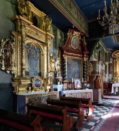 Zdjęcie nr 18: Kościół Nawiedzenia Najświętszej Marii Panny jest usytuowany w centrum wsi, na południe od głównej drogi wiodącej przez Paczółtowice. Teren przykościelny z umiejscowionym w północnej części cmentarzem otacza niewysoki, kamienny i częściowo ceglany mur nakryty dwuspadowym daszkiem. Prowadzą do niego dwa wejścia – usytuowana w północno-zachodnim narożniku muru brama z figurami Matki Boskiej i Chrystusa oraz nieco skromniejsze wejście od strony południowej. W północno-wschodniej części placu przykościelnego znajduje się wolnostojąca dzwonnica założona na planie czworoboku. Natomiast w części południowo-wschodniej umiejscowiona jest kamienna grota mieszcząca figurę Matki Boskiej z Lourdes. Kościół paczółtowicki to niewielkich rozmiarów, orientowana i jednonawowa budowla o konstrukcji drewnianej; kryta gontem. Fundamenty świątyni są murowane i tynkowane, odsadzkę pomiędzy fundamentem i zrębem przykrywa niewielki okap z gontu. Ściany zewnętrzne kościoła oszalowano pionowymi deskami z nabitymi dla wzmocnienia listwami. Zamknięte wielobocznie prezbiterium, przekryte dachem trójpołaciowym przylega do nieco szerszej nawy założonej na rzucie zbliżonym do kwadratu. Nawa nakryta jest dachem dwuspadowym. Prowadzą do niej dwa wejścia: główne, od zachodu, spod wieży i od strony południowej. Okna wychodzą wyłącznie na południe i umieszczone są parami w nawie, z zachowanymi oryginalnymi obramieniami i w prezbiterium, gdzie były zmienione w czasie późniejszym. Przy prezbiterium od strony północnej znajduje się zakrystia na rzucie prostokąta nakryta jednospadowym dachem; dostępna od strony wschodniej. Do nawy od strony południowej przylega niewielka kruchta również na rzucie prostokąta, nakryta dwuspadowym dachem. W elewacji zachodniej znajduje się kwadratowa wieża dzwonna o ścianach lekko pochyłych, w połowie wysokości podzielonych gzymsem. Nakryta jest hełmem o kształcie daszka namiotowego zamkniętego od góry cebulastą kopułką zwieńczoną krzyżem. W zachodniej ścianie wieży znajduje się wejście główne do kościoła przykryte daszkiem dwuspadowym. Na ścianie południowej dwa okna zwieńczone trójkątnymi daszkami. Od strony północnej, zachodniej i południowej po jednym oknie umiejscowionym pod dachem wieży. Ośmioboczna wieżyczka na sygnaturkę nakryta jest rozbudowanym, barokowym hełmem z pseudoglorietą również zwieńczonym krzyżem. Nawa i prezbiterium przekryte  są wspólnym stropem (w nawie z zaskrzynieniami; belki zaskrzynień profilowane). Między nawą a prezbiterium mieści się ściana tęczowa z otworem tęczowym w formie ostrołukowej arkady. Na wysokości trzech czwartych wysokości nawy umieszczona jest poprzeczna belka tęczowa. W zachodniej części nawy znajduje się drewniany chór muzyczny wsparty na profilowanych, drewnianych kolumnach. Odrzwia w nawie od zachodu i południa z nadprożami wyciętymi w ośli grzbiet; okna w nawie z nadokiennikami o takim samym wykroju. Drzwi prowadzące z prezbiterium do zakrystii żelazne z listwami w skośną kratę, z antabą i zamkiem. Posadzka w nawie i prezbiterium marmurowa.
