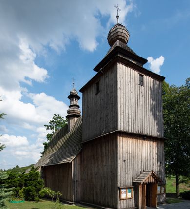 Zdjęcie nr 20: Kościół Nawiedzenia Najświętszej Marii Panny jest usytuowany w centrum wsi, na południe od głównej drogi wiodącej przez Paczółtowice. Teren przykościelny z umiejscowionym w północnej części cmentarzem otacza niewysoki, kamienny i częściowo ceglany mur nakryty dwuspadowym daszkiem. Prowadzą do niego dwa wejścia – usytuowana w północno-zachodnim narożniku muru brama z figurami Matki Boskiej i Chrystusa oraz nieco skromniejsze wejście od strony południowej. W północno-wschodniej części placu przykościelnego znajduje się wolnostojąca dzwonnica założona na planie czworoboku. Natomiast w części południowo-wschodniej umiejscowiona jest kamienna grota mieszcząca figurę Matki Boskiej z Lourdes. Kościół paczółtowicki to niewielkich rozmiarów, orientowana i jednonawowa budowla o konstrukcji drewnianej; kryta gontem. Fundamenty świątyni są murowane i tynkowane, odsadzkę pomiędzy fundamentem i zrębem przykrywa niewielki okap z gontu. Ściany zewnętrzne kościoła oszalowano pionowymi deskami z nabitymi dla wzmocnienia listwami. Zamknięte wielobocznie prezbiterium, przekryte dachem trójpołaciowym przylega do nieco szerszej nawy założonej na rzucie zbliżonym do kwadratu. Nawa nakryta jest dachem dwuspadowym. Prowadzą do niej dwa wejścia: główne, od zachodu, spod wieży i od strony południowej. Okna wychodzą wyłącznie na południe i umieszczone są parami w nawie, z zachowanymi oryginalnymi obramieniami i w prezbiterium, gdzie były zmienione w czasie późniejszym. Przy prezbiterium od strony północnej znajduje się zakrystia na rzucie prostokąta nakryta jednospadowym dachem; dostępna od strony wschodniej. Do nawy od strony południowej przylega niewielka kruchta również na rzucie prostokąta, nakryta dwuspadowym dachem. W elewacji zachodniej znajduje się kwadratowa wieża dzwonna o ścianach lekko pochyłych, w połowie wysokości podzielonych gzymsem. Nakryta jest hełmem o kształcie daszka namiotowego zamkniętego od góry cebulastą kopułką zwieńczoną krzyżem. W zachodniej ścianie wieży znajduje się wejście główne do kościoła przykryte daszkiem dwuspadowym. Na ścianie południowej dwa okna zwieńczone trójkątnymi daszkami. Od strony północnej, zachodniej i południowej po jednym oknie umiejscowionym pod dachem wieży. Ośmioboczna wieżyczka na sygnaturkę nakryta jest rozbudowanym, barokowym hełmem z pseudoglorietą również zwieńczonym krzyżem. Nawa i prezbiterium przekryte  są wspólnym stropem (w nawie z zaskrzynieniami; belki zaskrzynień profilowane). Między nawą a prezbiterium mieści się ściana tęczowa z otworem tęczowym w formie ostrołukowej arkady. Na wysokości trzech czwartych wysokości nawy umieszczona jest poprzeczna belka tęczowa. W zachodniej części nawy znajduje się drewniany chór muzyczny wsparty na profilowanych, drewnianych kolumnach. Odrzwia w nawie od zachodu i południa z nadprożami wyciętymi w ośli grzbiet; okna w nawie z nadokiennikami o takim samym wykroju. Drzwi prowadzące z prezbiterium do zakrystii żelazne z listwami w skośną kratę, z antabą i zamkiem. Posadzka w nawie i prezbiterium marmurowa.
