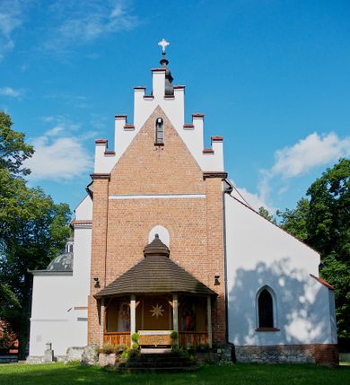 Zdjęcie nr 1: Kościół jest usytuowany w centrum wsi Rudawa, na północ od głównej drogi z Zabierzowa do Chrzanowa. Teren wokół niego jest otoczony wysokim, kamiennym murem z nieregularnych ciosów kamienia, oszkarpowanym, tynkowanym, z wyjątkiem zewnętrznej części muru na zachód od południowej bramki. W murze znajdują się trzy wejścia, od wschodu, południa i zachodu. W części wschodniej muru znajduje się trójosiowa brama wjazdowa, zwieńczona łukiem wklęsło-wypukłym, z trzema przelotami: środkowym wyższym i szerszym, zamkniętym łukiem odcinkowym i bocznymi węższymi i niższymi, zamkniętymi łukiem półkolistym (północne zamurowane). Część środkowa jest flankowana zdwojonymi pilastrami, podtrzymującymi profilowane uskokowe belkowanie z przyczółkiem o profilowanym łuku falistym, zwieńczonym równoramiennym krzyżem. W przyczółku wnęka z figurą św. Floriana. Bramki od strony zachodniej i południowej prostokątne, z przejściem zakończonym płaskim łukiem odcinkowym, z profilowanym gzymsem, zwieńczonym trójkątnym przyczółkiem. Przejścia zamykane drewnianymi ażurowymi i pomalowanymi na ciemnobrązowo jednoskrzydłowymi drzwiami. Poprzez bramkę od zachodu zejście kamiennymi schodami poprowadzonymi wzdłuż muru na dziedziniec plebański, usytuowany poniżej terenu kościelnego. 
W północno-wschodnim narożniku muru niewielka murowana i tynkowana kostnica na planie kwadratu, nakryta dachem namiotowym, łamanym, zakończonym ośmioboczną ślepą latarnią.

Po stronie południowej, poniżej placu kościelnego, do muru przylega murowana, tynkowana, prostokątna i dwukondygnacyjna „zegarowa” wieża bramna nakryta namiotowym dachem z wysoką drewnianą ośmioboczną latarnią o cebulastym hełmie. W wieży znajduje się przejazd wiodący na dziedziniec plebański, z sienią otwartą na przestrzał w dolnej kondygnacji i z lamusem dostępnym od strony placu kościelnego w górnej. 

W południowej części muru, w pobliżu południowo-wschodniego narożnika placu kościelnego, nadbudowana kamienna dzwonnica parawanowa z zawieszonymi czterema dzwonami.  

We wschodniej części placu kościelnego pomiędzy bramką wschodnią a kostnicą znajduje się kamienna ambona, o ośmiobocznej podstawie przechodzącej w szerszy, również ośmioboczny korpus, zakończony kamiennym parapetem, z kamiennymi schodami prowadzącymi na ambonę od strony wschodniej. 

Kościół jest orientowany, prawie w całości zbudowany z cegły, otynkowany z wyjątkiem prezbiterium. Wnętrze kościoła tworzy niewielkie, prostokątne, jednoprzęsłowe prezbiterium zakończone prostą ścianą i nakryte pozornym sklepieniem krzyżowo-żebrowym. Nawa jest szersza, prawie kwadratowa, nakryta drewnianym stropem. Prezbiterium z nawą są połączone szeroką, ostrołukową arkadą w ścianie tęczowej. Od północy do prezbiterium przylega założona na planie prostokąta dwuprzęsłowa zakrystia, nakryta sklepieniem krzyżowym. Wejście do zakrystii zaznaczone gotyckim, kamiennym, sfazowanym portalem zamkniętym łukiem ostrym. Od zachodu do zakrystii przylega niewielkie pomieszczenie gospodarcze, do którego z zakrystii prowadzą ostrołukowe drzwi. Zakrystia oświetlona ostrołukowym oknem w ścianie wschodniej, wypełnionym witrażem z tafelek w kształcie sześciokąta foremnego, ze szkła surowego, tzw. katedralnego. 

Od południa do nawy przylega kaplica o formach renesansowych, dwukondygnacyjna, założona na planie kwadratu. W dolnej kondygnacji sklepiona krzyżowo-żebrowo kruchta otwarta do nawy szeroką, zamkniętą półkoliście arkadą.

Ponad kruchtą kaplica św. Kazimierza, nakryta wspartą na pendentywach kopułą z latarnią. Z kruchty do kaplicy prowadzą kręte kamienne schody umieszczone od zachodu w półkolistej wieżyczce. Prostokątne wejście z krypty na klatkę schodową ujęte kamiennym profilowanym portalem. Kaplica otwarta do nawy szeroką, zamkniętą półkoliście arkadą, o kształcie i wymiarach analogicznych do arkady znajdującej się poniżej. Kaplicę, prócz latarni, oświetla prostokątne okno w ścianie południowej, wypełnione witrażem z tafelek w kształcie gomółek, ze szkła surowego, tzw. katedralnego. Na zachodniej ścianie nawy chór muzyczny, dostępny klatką schodową ukrytą w zewnętrznym aneksie przylegającym do zachodniej elewacji nawy i południowej elewacji wieży-dzwonnicy. 

Nawę i prezbiterium oświetlają umieszczone w południowych ścianach prostokątne, rozglifione okna: jedno w prezbiterium, dwa w nawie. Wszystkie wypełnione witrażami z tafelek w kształcie gomółek, ze szkła surowego, tzw. katedralnego. 

Do kościoła prowadzą dwa wejścia: poprzez arkadę z kruchty południowej oraz szerokie wejście główne prostokątne, zamknięte łukiem odcinkowym, prowadzące do kościoła z obszernej kruchty od strony zachodniej, znajdującej się w murowanym przyziemiu wieży - dzwonnicy. Kruchta, założona na planie kwadratu i nakryta murowanym stropem, doświetlona jest dwoma prostokątnymi oknami umieszczonymi naprzeciw siebie w ścianach północnej i południowej.
 
W zewnętrznej elewacji kościoła widoczny niewysoki kamienny cokół wykonany z nieregularnych ciosów kamienia. Prezbiterium, niższe od nawy, murowane z cegły w układzie wedyjskim, z domieszką układu polskiego. Wschodnie naroża prezbiterium zaakcentowane płaskimi lizenami. We wschodniej ścianie widoczny zarys zamurowanego wydłużonego okna zamkniętego lekko zaostrzonym łukiem, w trójkątnym szczycie znajduje się niewielkie wąskie okienko zakończone łukiem półkolistym. Południowa ściana prezbiterium ozdobiona fryzem z cegieł. Do ściany północnej prezbiterium przylega zakrystia, oszkarpowana, nakryta dachem pulpitowym, z dobudowanym od niej niewielkim aneksem, nakrytym takim samym zadaszeniem. Do wschodniej ściany prezbiterium przylega ogrójec nakryty dachem namiotowym z cebulastym zwieńczeniem, wspartym na sześciu smukłych, profilowanych drewnianych słupach z mieczami, pomiędzy którymi od północy i południa ażurowa drewniana balustrada. 

Nawa oszkarpowana w narożnikach. Elewacje bez podziałów architektonicznych. Od strony południowej do nawy dobudowana dwukondygnacyjna kaplica nakryta kopułą z latarnią, podzielona na dwie kondygnacje. W dolnej kondygnacji od południa wejście do kruchty zaznaczone kamiennym portalem o sfazowanych węgarach i lekko zaostrzonym łuku. Wejście zamykają drewniane dwuskrzydłowe drzwi ozdobione kratownicą z żelaznych listew. Od zachodu do kaplicy przylega półokrągła wieżyczka nakryta daszkiem stożkowym. 

Do zachodniej fasady kościoła dostawiona niska, założona na planie kwadratu trójkondygnacyjna wieża-dzwonnica: w dolnej części murowana, w narożach wzmocniona kamiennymi szkarpami, w górnej drewniana konstrukcji słupowo-ramowej z nadwieszoną izbicą i nakryta dachem półszczytowym. W dolnej, murowanej kondygnacji, na osi kościoła, prostokątne wejście do kruchty zaakcentowane przedsionkiem w kształcie ostrołukowej arkady i czterostopniowymi schodami. Przedsionek nakryty dachem dwuspadowym. Do zachodniej elewacji nawy i południowej elewacji dzwonnicy przylega niewielki, wysoki drewniany aneks, nakryty dachem pulpitowym, mieszczący klatkę schodową prowadzącą na górną kondygnację dzwonnicy i na chór muzyczny w nawie kościoła. Prostokątne wejście w południowej ścianie aneksu, do którego prowadzą pięciostopniowe proste schody. Ponad nimi, na wysokości drugiej kondygnacji dzwonnicy, niewielkie kwadratowe okno. 

Prezbiterium i nawa przykryte stromymi dachami dwuspadowymi, zamkniętymi od wschodu i zachodu szczytami sterczynowymi. Wieżyczka na sygnaturkę ośmioboczna, w dolnej części barokowa, w górnej części nowsza.