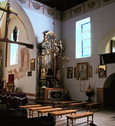 Zdjęcie nr 28: Kościół jest usytuowany w centrum wsi Rudawa, na północ od głównej drogi z Zabierzowa do Chrzanowa. Teren wokół niego jest otoczony wysokim, kamiennym murem z nieregularnych ciosów kamienia, oszkarpowanym, tynkowanym, z wyjątkiem zewnętrznej części muru na zachód od południowej bramki. W murze znajdują się trzy wejścia, od wschodu, południa i zachodu. W części wschodniej muru znajduje się trójosiowa brama wjazdowa, zwieńczona łukiem wklęsło-wypukłym, z trzema przelotami: środkowym wyższym i szerszym, zamkniętym łukiem odcinkowym i bocznymi węższymi i niższymi, zamkniętymi łukiem półkolistym (północne zamurowane). Część środkowa jest flankowana zdwojonymi pilastrami, podtrzymującymi profilowane uskokowe belkowanie z przyczółkiem o profilowanym łuku falistym, zwieńczonym równoramiennym krzyżem. W przyczółku wnęka z figurą św. Floriana. Bramki od strony zachodniej i południowej prostokątne, z przejściem zakończonym płaskim łukiem odcinkowym, z profilowanym gzymsem, zwieńczonym trójkątnym przyczółkiem. Przejścia zamykane drewnianymi ażurowymi i pomalowanymi na ciemnobrązowo jednoskrzydłowymi drzwiami. Poprzez bramkę od zachodu zejście kamiennymi schodami poprowadzonymi wzdłuż muru na dziedziniec plebański, usytuowany poniżej terenu kościelnego. 
W północno-wschodnim narożniku muru niewielka murowana i tynkowana kostnica na planie kwadratu, nakryta dachem namiotowym, łamanym, zakończonym ośmioboczną ślepą latarnią.

Po stronie południowej, poniżej placu kościelnego, do muru przylega murowana, tynkowana, prostokątna i dwukondygnacyjna „zegarowa” wieża bramna nakryta namiotowym dachem z wysoką drewnianą ośmioboczną latarnią o cebulastym hełmie. W wieży znajduje się przejazd wiodący na dziedziniec plebański, z sienią otwartą na przestrzał w dolnej kondygnacji i z lamusem dostępnym od strony placu kościelnego w górnej. 

W południowej części muru, w pobliżu południowo-wschodniego narożnika placu kościelnego, nadbudowana kamienna dzwonnica parawanowa z zawieszonymi czterema dzwonami.  

We wschodniej części placu kościelnego pomiędzy bramką wschodnią a kostnicą znajduje się kamienna ambona, o ośmiobocznej podstawie przechodzącej w szerszy, również ośmioboczny korpus, zakończony kamiennym parapetem, z kamiennymi schodami prowadzącymi na ambonę od strony wschodniej. 

Kościół jest orientowany, prawie w całości zbudowany z cegły, otynkowany z wyjątkiem prezbiterium. Wnętrze kościoła tworzy niewielkie, prostokątne, jednoprzęsłowe prezbiterium zakończone prostą ścianą i nakryte pozornym sklepieniem krzyżowo-żebrowym. Nawa jest szersza, prawie kwadratowa, nakryta drewnianym stropem. Prezbiterium z nawą są połączone szeroką, ostrołukową arkadą w ścianie tęczowej. Od północy do prezbiterium przylega założona na planie prostokąta dwuprzęsłowa zakrystia, nakryta sklepieniem krzyżowym. Wejście do zakrystii zaznaczone gotyckim, kamiennym, sfazowanym portalem zamkniętym łukiem ostrym. Od zachodu do zakrystii przylega niewielkie pomieszczenie gospodarcze, do którego z zakrystii prowadzą ostrołukowe drzwi. Zakrystia oświetlona ostrołukowym oknem w ścianie wschodniej, wypełnionym witrażem z tafelek w kształcie sześciokąta foremnego, ze szkła surowego, tzw. katedralnego. 

Od południa do nawy przylega kaplica o formach renesansowych, dwukondygnacyjna, założona na planie kwadratu. W dolnej kondygnacji sklepiona krzyżowo-żebrowo kruchta otwarta do nawy szeroką, zamkniętą półkoliście arkadą.

Ponad kruchtą kaplica św. Kazimierza, nakryta wspartą na pendentywach kopułą z latarnią. Z kruchty do kaplicy prowadzą kręte kamienne schody umieszczone od zachodu w półkolistej wieżyczce. Prostokątne wejście z krypty na klatkę schodową ujęte kamiennym profilowanym portalem. Kaplica otwarta do nawy szeroką, zamkniętą półkoliście arkadą, o kształcie i wymiarach analogicznych do arkady znajdującej się poniżej. Kaplicę, prócz latarni, oświetla prostokątne okno w ścianie południowej, wypełnione witrażem z tafelek w kształcie gomółek, ze szkła surowego, tzw. katedralnego. Na zachodniej ścianie nawy chór muzyczny, dostępny klatką schodową ukrytą w zewnętrznym aneksie przylegającym do zachodniej elewacji nawy i południowej elewacji wieży-dzwonnicy. 

Nawę i prezbiterium oświetlają umieszczone w południowych ścianach prostokątne, rozglifione okna: jedno w prezbiterium, dwa w nawie. Wszystkie wypełnione witrażami z tafelek w kształcie gomółek, ze szkła surowego, tzw. katedralnego. 

Do kościoła prowadzą dwa wejścia: poprzez arkadę z kruchty południowej oraz szerokie wejście główne prostokątne, zamknięte łukiem odcinkowym, prowadzące do kościoła z obszernej kruchty od strony zachodniej, znajdującej się w murowanym przyziemiu wieży - dzwonnicy. Kruchta, założona na planie kwadratu i nakryta murowanym stropem, doświetlona jest dwoma prostokątnymi oknami umieszczonymi naprzeciw siebie w ścianach północnej i południowej.
 
W zewnętrznej elewacji kościoła widoczny niewysoki kamienny cokół wykonany z nieregularnych ciosów kamienia. Prezbiterium, niższe od nawy, murowane z cegły w układzie wedyjskim, z domieszką układu polskiego. Wschodnie naroża prezbiterium zaakcentowane płaskimi lizenami. We wschodniej ścianie widoczny zarys zamurowanego wydłużonego okna zamkniętego lekko zaostrzonym łukiem, w trójkątnym szczycie znajduje się niewielkie wąskie okienko zakończone łukiem półkolistym. Południowa ściana prezbiterium ozdobiona fryzem z cegieł. Do ściany północnej prezbiterium przylega zakrystia, oszkarpowana, nakryta dachem pulpitowym, z dobudowanym od niej niewielkim aneksem, nakrytym takim samym zadaszeniem. Do wschodniej ściany prezbiterium przylega ogrójec nakryty dachem namiotowym z cebulastym zwieńczeniem, wspartym na sześciu smukłych, profilowanych drewnianych słupach z mieczami, pomiędzy którymi od północy i południa ażurowa drewniana balustrada. 

Nawa oszkarpowana w narożnikach. Elewacje bez podziałów architektonicznych. Od strony południowej do nawy dobudowana dwukondygnacyjna kaplica nakryta kopułą z latarnią, podzielona na dwie kondygnacje. W dolnej kondygnacji od południa wejście do kruchty zaznaczone kamiennym portalem o sfazowanych węgarach i lekko zaostrzonym łuku. Wejście zamykają drewniane dwuskrzydłowe drzwi ozdobione kratownicą z żelaznych listew. Od zachodu do kaplicy przylega półokrągła wieżyczka nakryta daszkiem stożkowym. 

Do zachodniej fasady kościoła dostawiona niska, założona na planie kwadratu trójkondygnacyjna wieża-dzwonnica: w dolnej części murowana, w narożach wzmocniona kamiennymi szkarpami, w górnej drewniana konstrukcji słupowo-ramowej z nadwieszoną izbicą i nakryta dachem półszczytowym. W dolnej, murowanej kondygnacji, na osi kościoła, prostokątne wejście do kruchty zaakcentowane przedsionkiem w kształcie ostrołukowej arkady i czterostopniowymi schodami. Przedsionek nakryty dachem dwuspadowym. Do zachodniej elewacji nawy i południowej elewacji dzwonnicy przylega niewielki, wysoki drewniany aneks, nakryty dachem pulpitowym, mieszczący klatkę schodową prowadzącą na górną kondygnację dzwonnicy i na chór muzyczny w nawie kościoła. Prostokątne wejście w południowej ścianie aneksu, do którego prowadzą pięciostopniowe proste schody. Ponad nimi, na wysokości drugiej kondygnacji dzwonnicy, niewielkie kwadratowe okno. 

Prezbiterium i nawa przykryte stromymi dachami dwuspadowymi, zamkniętymi od wschodu i zachodu szczytami sterczynowymi. Wieżyczka na sygnaturkę ośmioboczna, w dolnej części barokowa, w górnej części nowsza.