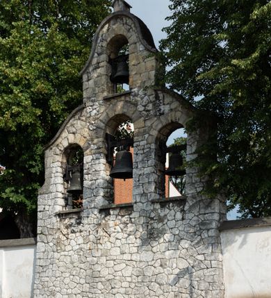 Zdjęcie nr 22: Kościół jest usytuowany w centrum wsi Rudawa, na północ od głównej drogi z Zabierzowa do Chrzanowa. Teren wokół niego jest otoczony wysokim, kamiennym murem z nieregularnych ciosów kamienia, oszkarpowanym, tynkowanym, z wyjątkiem zewnętrznej części muru na zachód od południowej bramki. W murze znajdują się trzy wejścia, od wschodu, południa i zachodu. W części wschodniej muru znajduje się trójosiowa brama wjazdowa, zwieńczona łukiem wklęsło-wypukłym, z trzema przelotami: środkowym wyższym i szerszym, zamkniętym łukiem odcinkowym i bocznymi węższymi i niższymi, zamkniętymi łukiem półkolistym (północne zamurowane). Część środkowa jest flankowana zdwojonymi pilastrami, podtrzymującymi profilowane uskokowe belkowanie z przyczółkiem o profilowanym łuku falistym, zwieńczonym równoramiennym krzyżem. W przyczółku wnęka z figurą św. Floriana. Bramki od strony zachodniej i południowej prostokątne, z przejściem zakończonym płaskim łukiem odcinkowym, z profilowanym gzymsem, zwieńczonym trójkątnym przyczółkiem. Przejścia zamykane drewnianymi ażurowymi i pomalowanymi na ciemnobrązowo jednoskrzydłowymi drzwiami. Poprzez bramkę od zachodu zejście kamiennymi schodami poprowadzonymi wzdłuż muru na dziedziniec plebański, usytuowany poniżej terenu kościelnego. 
W północno-wschodnim narożniku muru niewielka murowana i tynkowana kostnica na planie kwadratu, nakryta dachem namiotowym, łamanym, zakończonym ośmioboczną ślepą latarnią.

Po stronie południowej, poniżej placu kościelnego, do muru przylega murowana, tynkowana, prostokątna i dwukondygnacyjna „zegarowa” wieża bramna nakryta namiotowym dachem z wysoką drewnianą ośmioboczną latarnią o cebulastym hełmie. W wieży znajduje się przejazd wiodący na dziedziniec plebański, z sienią otwartą na przestrzał w dolnej kondygnacji i z lamusem dostępnym od strony placu kościelnego w górnej. 

W południowej części muru, w pobliżu południowo-wschodniego narożnika placu kościelnego, nadbudowana kamienna dzwonnica parawanowa z zawieszonymi czterema dzwonami.  

We wschodniej części placu kościelnego pomiędzy bramką wschodnią a kostnicą znajduje się kamienna ambona, o ośmiobocznej podstawie przechodzącej w szerszy, również ośmioboczny korpus, zakończony kamiennym parapetem, z kamiennymi schodami prowadzącymi na ambonę od strony wschodniej. 

Kościół jest orientowany, prawie w całości zbudowany z cegły, otynkowany z wyjątkiem prezbiterium. Wnętrze kościoła tworzy niewielkie, prostokątne, jednoprzęsłowe prezbiterium zakończone prostą ścianą i nakryte pozornym sklepieniem krzyżowo-żebrowym. Nawa jest szersza, prawie kwadratowa, nakryta drewnianym stropem. Prezbiterium z nawą są połączone szeroką, ostrołukową arkadą w ścianie tęczowej. Od północy do prezbiterium przylega założona na planie prostokąta dwuprzęsłowa zakrystia, nakryta sklepieniem krzyżowym. Wejście do zakrystii zaznaczone gotyckim, kamiennym, sfazowanym portalem zamkniętym łukiem ostrym. Od zachodu do zakrystii przylega niewielkie pomieszczenie gospodarcze, do którego z zakrystii prowadzą ostrołukowe drzwi. Zakrystia oświetlona ostrołukowym oknem w ścianie wschodniej, wypełnionym witrażem z tafelek w kształcie sześciokąta foremnego, ze szkła surowego, tzw. katedralnego. 

Od południa do nawy przylega kaplica o formach renesansowych, dwukondygnacyjna, założona na planie kwadratu. W dolnej kondygnacji sklepiona krzyżowo-żebrowo kruchta otwarta do nawy szeroką, zamkniętą półkoliście arkadą.

Ponad kruchtą kaplica św. Kazimierza, nakryta wspartą na pendentywach kopułą z latarnią. Z kruchty do kaplicy prowadzą kręte kamienne schody umieszczone od zachodu w półkolistej wieżyczce. Prostokątne wejście z krypty na klatkę schodową ujęte kamiennym profilowanym portalem. Kaplica otwarta do nawy szeroką, zamkniętą półkoliście arkadą, o kształcie i wymiarach analogicznych do arkady znajdującej się poniżej. Kaplicę, prócz latarni, oświetla prostokątne okno w ścianie południowej, wypełnione witrażem z tafelek w kształcie gomółek, ze szkła surowego, tzw. katedralnego. Na zachodniej ścianie nawy chór muzyczny, dostępny klatką schodową ukrytą w zewnętrznym aneksie przylegającym do zachodniej elewacji nawy i południowej elewacji wieży-dzwonnicy. 

Nawę i prezbiterium oświetlają umieszczone w południowych ścianach prostokątne, rozglifione okna: jedno w prezbiterium, dwa w nawie. Wszystkie wypełnione witrażami z tafelek w kształcie gomółek, ze szkła surowego, tzw. katedralnego. 

Do kościoła prowadzą dwa wejścia: poprzez arkadę z kruchty południowej oraz szerokie wejście główne prostokątne, zamknięte łukiem odcinkowym, prowadzące do kościoła z obszernej kruchty od strony zachodniej, znajdującej się w murowanym przyziemiu wieży - dzwonnicy. Kruchta, założona na planie kwadratu i nakryta murowanym stropem, doświetlona jest dwoma prostokątnymi oknami umieszczonymi naprzeciw siebie w ścianach północnej i południowej.
 
W zewnętrznej elewacji kościoła widoczny niewysoki kamienny cokół wykonany z nieregularnych ciosów kamienia. Prezbiterium, niższe od nawy, murowane z cegły w układzie wedyjskim, z domieszką układu polskiego. Wschodnie naroża prezbiterium zaakcentowane płaskimi lizenami. We wschodniej ścianie widoczny zarys zamurowanego wydłużonego okna zamkniętego lekko zaostrzonym łukiem, w trójkątnym szczycie znajduje się niewielkie wąskie okienko zakończone łukiem półkolistym. Południowa ściana prezbiterium ozdobiona fryzem z cegieł. Do ściany północnej prezbiterium przylega zakrystia, oszkarpowana, nakryta dachem pulpitowym, z dobudowanym od niej niewielkim aneksem, nakrytym takim samym zadaszeniem. Do wschodniej ściany prezbiterium przylega ogrójec nakryty dachem namiotowym z cebulastym zwieńczeniem, wspartym na sześciu smukłych, profilowanych drewnianych słupach z mieczami, pomiędzy którymi od północy i południa ażurowa drewniana balustrada. 

Nawa oszkarpowana w narożnikach. Elewacje bez podziałów architektonicznych. Od strony południowej do nawy dobudowana dwukondygnacyjna kaplica nakryta kopułą z latarnią, podzielona na dwie kondygnacje. W dolnej kondygnacji od południa wejście do kruchty zaznaczone kamiennym portalem o sfazowanych węgarach i lekko zaostrzonym łuku. Wejście zamykają drewniane dwuskrzydłowe drzwi ozdobione kratownicą z żelaznych listew. Od zachodu do kaplicy przylega półokrągła wieżyczka nakryta daszkiem stożkowym. 

Do zachodniej fasady kościoła dostawiona niska, założona na planie kwadratu trójkondygnacyjna wieża-dzwonnica: w dolnej części murowana, w narożach wzmocniona kamiennymi szkarpami, w górnej drewniana konstrukcji słupowo-ramowej z nadwieszoną izbicą i nakryta dachem półszczytowym. W dolnej, murowanej kondygnacji, na osi kościoła, prostokątne wejście do kruchty zaakcentowane przedsionkiem w kształcie ostrołukowej arkady i czterostopniowymi schodami. Przedsionek nakryty dachem dwuspadowym. Do zachodniej elewacji nawy i południowej elewacji dzwonnicy przylega niewielki, wysoki drewniany aneks, nakryty dachem pulpitowym, mieszczący klatkę schodową prowadzącą na górną kondygnację dzwonnicy i na chór muzyczny w nawie kościoła. Prostokątne wejście w południowej ścianie aneksu, do którego prowadzą pięciostopniowe proste schody. Ponad nimi, na wysokości drugiej kondygnacji dzwonnicy, niewielkie kwadratowe okno. 

Prezbiterium i nawa przykryte stromymi dachami dwuspadowymi, zamkniętymi od wschodu i zachodu szczytami sterczynowymi. Wieżyczka na sygnaturkę ośmioboczna, w dolnej części barokowa, w górnej części nowsza.