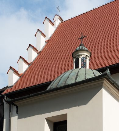 Zdjęcie nr 5: Kościół jest usytuowany w centrum wsi Rudawa, na północ od głównej drogi z Zabierzowa do Chrzanowa. Teren wokół niego jest otoczony wysokim, kamiennym murem z nieregularnych ciosów kamienia, oszkarpowanym, tynkowanym, z wyjątkiem zewnętrznej części muru na zachód od południowej bramki. W murze znajdują się trzy wejścia, od wschodu, południa i zachodu. W części wschodniej muru znajduje się trójosiowa brama wjazdowa, zwieńczona łukiem wklęsło-wypukłym, z trzema przelotami: środkowym wyższym i szerszym, zamkniętym łukiem odcinkowym i bocznymi węższymi i niższymi, zamkniętymi łukiem półkolistym (północne zamurowane). Część środkowa jest flankowana zdwojonymi pilastrami, podtrzymującymi profilowane uskokowe belkowanie z przyczółkiem o profilowanym łuku falistym, zwieńczonym równoramiennym krzyżem. W przyczółku wnęka z figurą św. Floriana. Bramki od strony zachodniej i południowej prostokątne, z przejściem zakończonym płaskim łukiem odcinkowym, z profilowanym gzymsem, zwieńczonym trójkątnym przyczółkiem. Przejścia zamykane drewnianymi ażurowymi i pomalowanymi na ciemnobrązowo jednoskrzydłowymi drzwiami. Poprzez bramkę od zachodu zejście kamiennymi schodami poprowadzonymi wzdłuż muru na dziedziniec plebański, usytuowany poniżej terenu kościelnego. 
W północno-wschodnim narożniku muru niewielka murowana i tynkowana kostnica na planie kwadratu, nakryta dachem namiotowym, łamanym, zakończonym ośmioboczną ślepą latarnią.

Po stronie południowej, poniżej placu kościelnego, do muru przylega murowana, tynkowana, prostokątna i dwukondygnacyjna „zegarowa” wieża bramna nakryta namiotowym dachem z wysoką drewnianą ośmioboczną latarnią o cebulastym hełmie. W wieży znajduje się przejazd wiodący na dziedziniec plebański, z sienią otwartą na przestrzał w dolnej kondygnacji i z lamusem dostępnym od strony placu kościelnego w górnej. 

W południowej części muru, w pobliżu południowo-wschodniego narożnika placu kościelnego, nadbudowana kamienna dzwonnica parawanowa z zawieszonymi czterema dzwonami.  

We wschodniej części placu kościelnego pomiędzy bramką wschodnią a kostnicą znajduje się kamienna ambona, o ośmiobocznej podstawie przechodzącej w szerszy, również ośmioboczny korpus, zakończony kamiennym parapetem, z kamiennymi schodami prowadzącymi na ambonę od strony wschodniej. 

Kościół jest orientowany, prawie w całości zbudowany z cegły, otynkowany z wyjątkiem prezbiterium. Wnętrze kościoła tworzy niewielkie, prostokątne, jednoprzęsłowe prezbiterium zakończone prostą ścianą i nakryte pozornym sklepieniem krzyżowo-żebrowym. Nawa jest szersza, prawie kwadratowa, nakryta drewnianym stropem. Prezbiterium z nawą są połączone szeroką, ostrołukową arkadą w ścianie tęczowej. Od północy do prezbiterium przylega założona na planie prostokąta dwuprzęsłowa zakrystia, nakryta sklepieniem krzyżowym. Wejście do zakrystii zaznaczone gotyckim, kamiennym, sfazowanym portalem zamkniętym łukiem ostrym. Od zachodu do zakrystii przylega niewielkie pomieszczenie gospodarcze, do którego z zakrystii prowadzą ostrołukowe drzwi. Zakrystia oświetlona ostrołukowym oknem w ścianie wschodniej, wypełnionym witrażem z tafelek w kształcie sześciokąta foremnego, ze szkła surowego, tzw. katedralnego. 

Od południa do nawy przylega kaplica o formach renesansowych, dwukondygnacyjna, założona na planie kwadratu. W dolnej kondygnacji sklepiona krzyżowo-żebrowo kruchta otwarta do nawy szeroką, zamkniętą półkoliście arkadą.

Ponad kruchtą kaplica św. Kazimierza, nakryta wspartą na pendentywach kopułą z latarnią. Z kruchty do kaplicy prowadzą kręte kamienne schody umieszczone od zachodu w półkolistej wieżyczce. Prostokątne wejście z krypty na klatkę schodową ujęte kamiennym profilowanym portalem. Kaplica otwarta do nawy szeroką, zamkniętą półkoliście arkadą, o kształcie i wymiarach analogicznych do arkady znajdującej się poniżej. Kaplicę, prócz latarni, oświetla prostokątne okno w ścianie południowej, wypełnione witrażem z tafelek w kształcie gomółek, ze szkła surowego, tzw. katedralnego. Na zachodniej ścianie nawy chór muzyczny, dostępny klatką schodową ukrytą w zewnętrznym aneksie przylegającym do zachodniej elewacji nawy i południowej elewacji wieży-dzwonnicy. 

Nawę i prezbiterium oświetlają umieszczone w południowych ścianach prostokątne, rozglifione okna: jedno w prezbiterium, dwa w nawie. Wszystkie wypełnione witrażami z tafelek w kształcie gomółek, ze szkła surowego, tzw. katedralnego. 

Do kościoła prowadzą dwa wejścia: poprzez arkadę z kruchty południowej oraz szerokie wejście główne prostokątne, zamknięte łukiem odcinkowym, prowadzące do kościoła z obszernej kruchty od strony zachodniej, znajdującej się w murowanym przyziemiu wieży - dzwonnicy. Kruchta, założona na planie kwadratu i nakryta murowanym stropem, doświetlona jest dwoma prostokątnymi oknami umieszczonymi naprzeciw siebie w ścianach północnej i południowej.
 
W zewnętrznej elewacji kościoła widoczny niewysoki kamienny cokół wykonany z nieregularnych ciosów kamienia. Prezbiterium, niższe od nawy, murowane z cegły w układzie wedyjskim, z domieszką układu polskiego. Wschodnie naroża prezbiterium zaakcentowane płaskimi lizenami. We wschodniej ścianie widoczny zarys zamurowanego wydłużonego okna zamkniętego lekko zaostrzonym łukiem, w trójkątnym szczycie znajduje się niewielkie wąskie okienko zakończone łukiem półkolistym. Południowa ściana prezbiterium ozdobiona fryzem z cegieł. Do ściany północnej prezbiterium przylega zakrystia, oszkarpowana, nakryta dachem pulpitowym, z dobudowanym od niej niewielkim aneksem, nakrytym takim samym zadaszeniem. Do wschodniej ściany prezbiterium przylega ogrójec nakryty dachem namiotowym z cebulastym zwieńczeniem, wspartym na sześciu smukłych, profilowanych drewnianych słupach z mieczami, pomiędzy którymi od północy i południa ażurowa drewniana balustrada. 

Nawa oszkarpowana w narożnikach. Elewacje bez podziałów architektonicznych. Od strony południowej do nawy dobudowana dwukondygnacyjna kaplica nakryta kopułą z latarnią, podzielona na dwie kondygnacje. W dolnej kondygnacji od południa wejście do kruchty zaznaczone kamiennym portalem o sfazowanych węgarach i lekko zaostrzonym łuku. Wejście zamykają drewniane dwuskrzydłowe drzwi ozdobione kratownicą z żelaznych listew. Od zachodu do kaplicy przylega półokrągła wieżyczka nakryta daszkiem stożkowym. 

Do zachodniej fasady kościoła dostawiona niska, założona na planie kwadratu trójkondygnacyjna wieża-dzwonnica: w dolnej części murowana, w narożach wzmocniona kamiennymi szkarpami, w górnej drewniana konstrukcji słupowo-ramowej z nadwieszoną izbicą i nakryta dachem półszczytowym. W dolnej, murowanej kondygnacji, na osi kościoła, prostokątne wejście do kruchty zaakcentowane przedsionkiem w kształcie ostrołukowej arkady i czterostopniowymi schodami. Przedsionek nakryty dachem dwuspadowym. Do zachodniej elewacji nawy i południowej elewacji dzwonnicy przylega niewielki, wysoki drewniany aneks, nakryty dachem pulpitowym, mieszczący klatkę schodową prowadzącą na górną kondygnację dzwonnicy i na chór muzyczny w nawie kościoła. Prostokątne wejście w południowej ścianie aneksu, do którego prowadzą pięciostopniowe proste schody. Ponad nimi, na wysokości drugiej kondygnacji dzwonnicy, niewielkie kwadratowe okno. 

Prezbiterium i nawa przykryte stromymi dachami dwuspadowymi, zamkniętymi od wschodu i zachodu szczytami sterczynowymi. Wieżyczka na sygnaturkę ośmioboczna, w dolnej części barokowa, w górnej części nowsza.