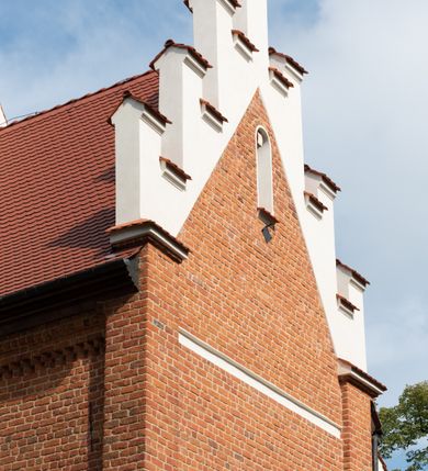 Zdjęcie nr 72: Kościół jest usytuowany w centrum wsi Rudawa, na północ od głównej drogi z Zabierzowa do Chrzanowa. Teren wokół niego jest otoczony wysokim, kamiennym murem z nieregularnych ciosów kamienia, oszkarpowanym, tynkowanym, z wyjątkiem zewnętrznej części muru na zachód od południowej bramki. W murze znajdują się trzy wejścia, od wschodu, południa i zachodu. W części wschodniej muru znajduje się trójosiowa brama wjazdowa, zwieńczona łukiem wklęsło-wypukłym, z trzema przelotami: środkowym wyższym i szerszym, zamkniętym łukiem odcinkowym i bocznymi węższymi i niższymi, zamkniętymi łukiem półkolistym (północne zamurowane). Część środkowa jest flankowana zdwojonymi pilastrami, podtrzymującymi profilowane uskokowe belkowanie z przyczółkiem o profilowanym łuku falistym, zwieńczonym równoramiennym krzyżem. W przyczółku wnęka z figurą św. Floriana. Bramki od strony zachodniej i południowej prostokątne, z przejściem zakończonym płaskim łukiem odcinkowym, z profilowanym gzymsem, zwieńczonym trójkątnym przyczółkiem. Przejścia zamykane drewnianymi ażurowymi i pomalowanymi na ciemnobrązowo jednoskrzydłowymi drzwiami. Poprzez bramkę od zachodu zejście kamiennymi schodami poprowadzonymi wzdłuż muru na dziedziniec plebański, usytuowany poniżej terenu kościelnego. 
W północno-wschodnim narożniku muru niewielka murowana i tynkowana kostnica na planie kwadratu, nakryta dachem namiotowym, łamanym, zakończonym ośmioboczną ślepą latarnią.

Po stronie południowej, poniżej placu kościelnego, do muru przylega murowana, tynkowana, prostokątna i dwukondygnacyjna „zegarowa” wieża bramna nakryta namiotowym dachem z wysoką drewnianą ośmioboczną latarnią o cebulastym hełmie. W wieży znajduje się przejazd wiodący na dziedziniec plebański, z sienią otwartą na przestrzał w dolnej kondygnacji i z lamusem dostępnym od strony placu kościelnego w górnej. 

W południowej części muru, w pobliżu południowo-wschodniego narożnika placu kościelnego, nadbudowana kamienna dzwonnica parawanowa z zawieszonymi czterema dzwonami.  

We wschodniej części placu kościelnego pomiędzy bramką wschodnią a kostnicą znajduje się kamienna ambona, o ośmiobocznej podstawie przechodzącej w szerszy, również ośmioboczny korpus, zakończony kamiennym parapetem, z kamiennymi schodami prowadzącymi na ambonę od strony wschodniej. 

Kościół jest orientowany, prawie w całości zbudowany z cegły, otynkowany z wyjątkiem prezbiterium. Wnętrze kościoła tworzy niewielkie, prostokątne, jednoprzęsłowe prezbiterium zakończone prostą ścianą i nakryte pozornym sklepieniem krzyżowo-żebrowym. Nawa jest szersza, prawie kwadratowa, nakryta drewnianym stropem. Prezbiterium z nawą są połączone szeroką, ostrołukową arkadą w ścianie tęczowej. Od północy do prezbiterium przylega założona na planie prostokąta dwuprzęsłowa zakrystia, nakryta sklepieniem krzyżowym. Wejście do zakrystii zaznaczone gotyckim, kamiennym, sfazowanym portalem zamkniętym łukiem ostrym. Od zachodu do zakrystii przylega niewielkie pomieszczenie gospodarcze, do którego z zakrystii prowadzą ostrołukowe drzwi. Zakrystia oświetlona ostrołukowym oknem w ścianie wschodniej, wypełnionym witrażem z tafelek w kształcie sześciokąta foremnego, ze szkła surowego, tzw. katedralnego. 

Od południa do nawy przylega kaplica o formach renesansowych, dwukondygnacyjna, założona na planie kwadratu. W dolnej kondygnacji sklepiona krzyżowo-żebrowo kruchta otwarta do nawy szeroką, zamkniętą półkoliście arkadą.

Ponad kruchtą kaplica św. Kazimierza, nakryta wspartą na pendentywach kopułą z latarnią. Z kruchty do kaplicy prowadzą kręte kamienne schody umieszczone od zachodu w półkolistej wieżyczce. Prostokątne wejście z krypty na klatkę schodową ujęte kamiennym profilowanym portalem. Kaplica otwarta do nawy szeroką, zamkniętą półkoliście arkadą, o kształcie i wymiarach analogicznych do arkady znajdującej się poniżej. Kaplicę, prócz latarni, oświetla prostokątne okno w ścianie południowej, wypełnione witrażem z tafelek w kształcie gomółek, ze szkła surowego, tzw. katedralnego. Na zachodniej ścianie nawy chór muzyczny, dostępny klatką schodową ukrytą w zewnętrznym aneksie przylegającym do zachodniej elewacji nawy i południowej elewacji wieży-dzwonnicy. 

Nawę i prezbiterium oświetlają umieszczone w południowych ścianach prostokątne, rozglifione okna: jedno w prezbiterium, dwa w nawie. Wszystkie wypełnione witrażami z tafelek w kształcie gomółek, ze szkła surowego, tzw. katedralnego. 

Do kościoła prowadzą dwa wejścia: poprzez arkadę z kruchty południowej oraz szerokie wejście główne prostokątne, zamknięte łukiem odcinkowym, prowadzące do kościoła z obszernej kruchty od strony zachodniej, znajdującej się w murowanym przyziemiu wieży - dzwonnicy. Kruchta, założona na planie kwadratu i nakryta murowanym stropem, doświetlona jest dwoma prostokątnymi oknami umieszczonymi naprzeciw siebie w ścianach północnej i południowej.
 
W zewnętrznej elewacji kościoła widoczny niewysoki kamienny cokół wykonany z nieregularnych ciosów kamienia. Prezbiterium, niższe od nawy, murowane z cegły w układzie wedyjskim, z domieszką układu polskiego. Wschodnie naroża prezbiterium zaakcentowane płaskimi lizenami. We wschodniej ścianie widoczny zarys zamurowanego wydłużonego okna zamkniętego lekko zaostrzonym łukiem, w trójkątnym szczycie znajduje się niewielkie wąskie okienko zakończone łukiem półkolistym. Południowa ściana prezbiterium ozdobiona fryzem z cegieł. Do ściany północnej prezbiterium przylega zakrystia, oszkarpowana, nakryta dachem pulpitowym, z dobudowanym od niej niewielkim aneksem, nakrytym takim samym zadaszeniem. Do wschodniej ściany prezbiterium przylega ogrójec nakryty dachem namiotowym z cebulastym zwieńczeniem, wspartym na sześciu smukłych, profilowanych drewnianych słupach z mieczami, pomiędzy którymi od północy i południa ażurowa drewniana balustrada. 

Nawa oszkarpowana w narożnikach. Elewacje bez podziałów architektonicznych. Od strony południowej do nawy dobudowana dwukondygnacyjna kaplica nakryta kopułą z latarnią, podzielona na dwie kondygnacje. W dolnej kondygnacji od południa wejście do kruchty zaznaczone kamiennym portalem o sfazowanych węgarach i lekko zaostrzonym łuku. Wejście zamykają drewniane dwuskrzydłowe drzwi ozdobione kratownicą z żelaznych listew. Od zachodu do kaplicy przylega półokrągła wieżyczka nakryta daszkiem stożkowym. 

Do zachodniej fasady kościoła dostawiona niska, założona na planie kwadratu trójkondygnacyjna wieża-dzwonnica: w dolnej części murowana, w narożach wzmocniona kamiennymi szkarpami, w górnej drewniana konstrukcji słupowo-ramowej z nadwieszoną izbicą i nakryta dachem półszczytowym. W dolnej, murowanej kondygnacji, na osi kościoła, prostokątne wejście do kruchty zaakcentowane przedsionkiem w kształcie ostrołukowej arkady i czterostopniowymi schodami. Przedsionek nakryty dachem dwuspadowym. Do zachodniej elewacji nawy i południowej elewacji dzwonnicy przylega niewielki, wysoki drewniany aneks, nakryty dachem pulpitowym, mieszczący klatkę schodową prowadzącą na górną kondygnację dzwonnicy i na chór muzyczny w nawie kościoła. Prostokątne wejście w południowej ścianie aneksu, do którego prowadzą pięciostopniowe proste schody. Ponad nimi, na wysokości drugiej kondygnacji dzwonnicy, niewielkie kwadratowe okno. 

Prezbiterium i nawa przykryte stromymi dachami dwuspadowymi, zamkniętymi od wschodu i zachodu szczytami sterczynowymi. Wieżyczka na sygnaturkę ośmioboczna, w dolnej części barokowa, w górnej części nowsza.