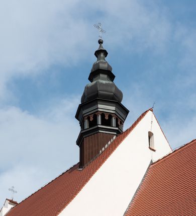 Zdjęcie nr 7: Kościół jest usytuowany w centrum wsi Rudawa, na północ od głównej drogi z Zabierzowa do Chrzanowa. Teren wokół niego jest otoczony wysokim, kamiennym murem z nieregularnych ciosów kamienia, oszkarpowanym, tynkowanym, z wyjątkiem zewnętrznej części muru na zachód od południowej bramki. W murze znajdują się trzy wejścia, od wschodu, południa i zachodu. W części wschodniej muru znajduje się trójosiowa brama wjazdowa, zwieńczona łukiem wklęsło-wypukłym, z trzema przelotami: środkowym wyższym i szerszym, zamkniętym łukiem odcinkowym i bocznymi węższymi i niższymi, zamkniętymi łukiem półkolistym (północne zamurowane). Część środkowa jest flankowana zdwojonymi pilastrami, podtrzymującymi profilowane uskokowe belkowanie z przyczółkiem o profilowanym łuku falistym, zwieńczonym równoramiennym krzyżem. W przyczółku wnęka z figurą św. Floriana. Bramki od strony zachodniej i południowej prostokątne, z przejściem zakończonym płaskim łukiem odcinkowym, z profilowanym gzymsem, zwieńczonym trójkątnym przyczółkiem. Przejścia zamykane drewnianymi ażurowymi i pomalowanymi na ciemnobrązowo jednoskrzydłowymi drzwiami. Poprzez bramkę od zachodu zejście kamiennymi schodami poprowadzonymi wzdłuż muru na dziedziniec plebański, usytuowany poniżej terenu kościelnego. 
W północno-wschodnim narożniku muru niewielka murowana i tynkowana kostnica na planie kwadratu, nakryta dachem namiotowym, łamanym, zakończonym ośmioboczną ślepą latarnią.

Po stronie południowej, poniżej placu kościelnego, do muru przylega murowana, tynkowana, prostokątna i dwukondygnacyjna „zegarowa” wieża bramna nakryta namiotowym dachem z wysoką drewnianą ośmioboczną latarnią o cebulastym hełmie. W wieży znajduje się przejazd wiodący na dziedziniec plebański, z sienią otwartą na przestrzał w dolnej kondygnacji i z lamusem dostępnym od strony placu kościelnego w górnej. 

W południowej części muru, w pobliżu południowo-wschodniego narożnika placu kościelnego, nadbudowana kamienna dzwonnica parawanowa z zawieszonymi czterema dzwonami.  

We wschodniej części placu kościelnego pomiędzy bramką wschodnią a kostnicą znajduje się kamienna ambona, o ośmiobocznej podstawie przechodzącej w szerszy, również ośmioboczny korpus, zakończony kamiennym parapetem, z kamiennymi schodami prowadzącymi na ambonę od strony wschodniej. 

Kościół jest orientowany, prawie w całości zbudowany z cegły, otynkowany z wyjątkiem prezbiterium. Wnętrze kościoła tworzy niewielkie, prostokątne, jednoprzęsłowe prezbiterium zakończone prostą ścianą i nakryte pozornym sklepieniem krzyżowo-żebrowym. Nawa jest szersza, prawie kwadratowa, nakryta drewnianym stropem. Prezbiterium z nawą są połączone szeroką, ostrołukową arkadą w ścianie tęczowej. Od północy do prezbiterium przylega założona na planie prostokąta dwuprzęsłowa zakrystia, nakryta sklepieniem krzyżowym. Wejście do zakrystii zaznaczone gotyckim, kamiennym, sfazowanym portalem zamkniętym łukiem ostrym. Od zachodu do zakrystii przylega niewielkie pomieszczenie gospodarcze, do którego z zakrystii prowadzą ostrołukowe drzwi. Zakrystia oświetlona ostrołukowym oknem w ścianie wschodniej, wypełnionym witrażem z tafelek w kształcie sześciokąta foremnego, ze szkła surowego, tzw. katedralnego. 

Od południa do nawy przylega kaplica o formach renesansowych, dwukondygnacyjna, założona na planie kwadratu. W dolnej kondygnacji sklepiona krzyżowo-żebrowo kruchta otwarta do nawy szeroką, zamkniętą półkoliście arkadą.

Ponad kruchtą kaplica św. Kazimierza, nakryta wspartą na pendentywach kopułą z latarnią. Z kruchty do kaplicy prowadzą kręte kamienne schody umieszczone od zachodu w półkolistej wieżyczce. Prostokątne wejście z krypty na klatkę schodową ujęte kamiennym profilowanym portalem. Kaplica otwarta do nawy szeroką, zamkniętą półkoliście arkadą, o kształcie i wymiarach analogicznych do arkady znajdującej się poniżej. Kaplicę, prócz latarni, oświetla prostokątne okno w ścianie południowej, wypełnione witrażem z tafelek w kształcie gomółek, ze szkła surowego, tzw. katedralnego. Na zachodniej ścianie nawy chór muzyczny, dostępny klatką schodową ukrytą w zewnętrznym aneksie przylegającym do zachodniej elewacji nawy i południowej elewacji wieży-dzwonnicy. 

Nawę i prezbiterium oświetlają umieszczone w południowych ścianach prostokątne, rozglifione okna: jedno w prezbiterium, dwa w nawie. Wszystkie wypełnione witrażami z tafelek w kształcie gomółek, ze szkła surowego, tzw. katedralnego. 

Do kościoła prowadzą dwa wejścia: poprzez arkadę z kruchty południowej oraz szerokie wejście główne prostokątne, zamknięte łukiem odcinkowym, prowadzące do kościoła z obszernej kruchty od strony zachodniej, znajdującej się w murowanym przyziemiu wieży - dzwonnicy. Kruchta, założona na planie kwadratu i nakryta murowanym stropem, doświetlona jest dwoma prostokątnymi oknami umieszczonymi naprzeciw siebie w ścianach północnej i południowej.
 
W zewnętrznej elewacji kościoła widoczny niewysoki kamienny cokół wykonany z nieregularnych ciosów kamienia. Prezbiterium, niższe od nawy, murowane z cegły w układzie wedyjskim, z domieszką układu polskiego. Wschodnie naroża prezbiterium zaakcentowane płaskimi lizenami. We wschodniej ścianie widoczny zarys zamurowanego wydłużonego okna zamkniętego lekko zaostrzonym łukiem, w trójkątnym szczycie znajduje się niewielkie wąskie okienko zakończone łukiem półkolistym. Południowa ściana prezbiterium ozdobiona fryzem z cegieł. Do ściany północnej prezbiterium przylega zakrystia, oszkarpowana, nakryta dachem pulpitowym, z dobudowanym od niej niewielkim aneksem, nakrytym takim samym zadaszeniem. Do wschodniej ściany prezbiterium przylega ogrójec nakryty dachem namiotowym z cebulastym zwieńczeniem, wspartym na sześciu smukłych, profilowanych drewnianych słupach z mieczami, pomiędzy którymi od północy i południa ażurowa drewniana balustrada. 

Nawa oszkarpowana w narożnikach. Elewacje bez podziałów architektonicznych. Od strony południowej do nawy dobudowana dwukondygnacyjna kaplica nakryta kopułą z latarnią, podzielona na dwie kondygnacje. W dolnej kondygnacji od południa wejście do kruchty zaznaczone kamiennym portalem o sfazowanych węgarach i lekko zaostrzonym łuku. Wejście zamykają drewniane dwuskrzydłowe drzwi ozdobione kratownicą z żelaznych listew. Od zachodu do kaplicy przylega półokrągła wieżyczka nakryta daszkiem stożkowym. 

Do zachodniej fasady kościoła dostawiona niska, założona na planie kwadratu trójkondygnacyjna wieża-dzwonnica: w dolnej części murowana, w narożach wzmocniona kamiennymi szkarpami, w górnej drewniana konstrukcji słupowo-ramowej z nadwieszoną izbicą i nakryta dachem półszczytowym. W dolnej, murowanej kondygnacji, na osi kościoła, prostokątne wejście do kruchty zaakcentowane przedsionkiem w kształcie ostrołukowej arkady i czterostopniowymi schodami. Przedsionek nakryty dachem dwuspadowym. Do zachodniej elewacji nawy i południowej elewacji dzwonnicy przylega niewielki, wysoki drewniany aneks, nakryty dachem pulpitowym, mieszczący klatkę schodową prowadzącą na górną kondygnację dzwonnicy i na chór muzyczny w nawie kościoła. Prostokątne wejście w południowej ścianie aneksu, do którego prowadzą pięciostopniowe proste schody. Ponad nimi, na wysokości drugiej kondygnacji dzwonnicy, niewielkie kwadratowe okno. 

Prezbiterium i nawa przykryte stromymi dachami dwuspadowymi, zamkniętymi od wschodu i zachodu szczytami sterczynowymi. Wieżyczka na sygnaturkę ośmioboczna, w dolnej części barokowa, w górnej części nowsza.