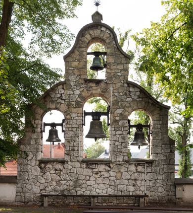 Zdjęcie nr 20: Kościół jest usytuowany w centrum wsi Rudawa, na północ od głównej drogi z Zabierzowa do Chrzanowa. Teren wokół niego jest otoczony wysokim, kamiennym murem z nieregularnych ciosów kamienia, oszkarpowanym, tynkowanym, z wyjątkiem zewnętrznej części muru na zachód od południowej bramki. W murze znajdują się trzy wejścia, od wschodu, południa i zachodu. W części wschodniej muru znajduje się trójosiowa brama wjazdowa, zwieńczona łukiem wklęsło-wypukłym, z trzema przelotami: środkowym wyższym i szerszym, zamkniętym łukiem odcinkowym i bocznymi węższymi i niższymi, zamkniętymi łukiem półkolistym (północne zamurowane). Część środkowa jest flankowana zdwojonymi pilastrami, podtrzymującymi profilowane uskokowe belkowanie z przyczółkiem o profilowanym łuku falistym, zwieńczonym równoramiennym krzyżem. W przyczółku wnęka z figurą św. Floriana. Bramki od strony zachodniej i południowej prostokątne, z przejściem zakończonym płaskim łukiem odcinkowym, z profilowanym gzymsem, zwieńczonym trójkątnym przyczółkiem. Przejścia zamykane drewnianymi ażurowymi i pomalowanymi na ciemnobrązowo jednoskrzydłowymi drzwiami. Poprzez bramkę od zachodu zejście kamiennymi schodami poprowadzonymi wzdłuż muru na dziedziniec plebański, usytuowany poniżej terenu kościelnego. 
W północno-wschodnim narożniku muru niewielka murowana i tynkowana kostnica na planie kwadratu, nakryta dachem namiotowym, łamanym, zakończonym ośmioboczną ślepą latarnią.

Po stronie południowej, poniżej placu kościelnego, do muru przylega murowana, tynkowana, prostokątna i dwukondygnacyjna „zegarowa” wieża bramna nakryta namiotowym dachem z wysoką drewnianą ośmioboczną latarnią o cebulastym hełmie. W wieży znajduje się przejazd wiodący na dziedziniec plebański, z sienią otwartą na przestrzał w dolnej kondygnacji i z lamusem dostępnym od strony placu kościelnego w górnej. 

W południowej części muru, w pobliżu południowo-wschodniego narożnika placu kościelnego, nadbudowana kamienna dzwonnica parawanowa z zawieszonymi czterema dzwonami.  

We wschodniej części placu kościelnego pomiędzy bramką wschodnią a kostnicą znajduje się kamienna ambona, o ośmiobocznej podstawie przechodzącej w szerszy, również ośmioboczny korpus, zakończony kamiennym parapetem, z kamiennymi schodami prowadzącymi na ambonę od strony wschodniej. 

Kościół jest orientowany, prawie w całości zbudowany z cegły, otynkowany z wyjątkiem prezbiterium. Wnętrze kościoła tworzy niewielkie, prostokątne, jednoprzęsłowe prezbiterium zakończone prostą ścianą i nakryte pozornym sklepieniem krzyżowo-żebrowym. Nawa jest szersza, prawie kwadratowa, nakryta drewnianym stropem. Prezbiterium z nawą są połączone szeroką, ostrołukową arkadą w ścianie tęczowej. Od północy do prezbiterium przylega założona na planie prostokąta dwuprzęsłowa zakrystia, nakryta sklepieniem krzyżowym. Wejście do zakrystii zaznaczone gotyckim, kamiennym, sfazowanym portalem zamkniętym łukiem ostrym. Od zachodu do zakrystii przylega niewielkie pomieszczenie gospodarcze, do którego z zakrystii prowadzą ostrołukowe drzwi. Zakrystia oświetlona ostrołukowym oknem w ścianie wschodniej, wypełnionym witrażem z tafelek w kształcie sześciokąta foremnego, ze szkła surowego, tzw. katedralnego. 

Od południa do nawy przylega kaplica o formach renesansowych, dwukondygnacyjna, założona na planie kwadratu. W dolnej kondygnacji sklepiona krzyżowo-żebrowo kruchta otwarta do nawy szeroką, zamkniętą półkoliście arkadą.

Ponad kruchtą kaplica św. Kazimierza, nakryta wspartą na pendentywach kopułą z latarnią. Z kruchty do kaplicy prowadzą kręte kamienne schody umieszczone od zachodu w półkolistej wieżyczce. Prostokątne wejście z krypty na klatkę schodową ujęte kamiennym profilowanym portalem. Kaplica otwarta do nawy szeroką, zamkniętą półkoliście arkadą, o kształcie i wymiarach analogicznych do arkady znajdującej się poniżej. Kaplicę, prócz latarni, oświetla prostokątne okno w ścianie południowej, wypełnione witrażem z tafelek w kształcie gomółek, ze szkła surowego, tzw. katedralnego. Na zachodniej ścianie nawy chór muzyczny, dostępny klatką schodową ukrytą w zewnętrznym aneksie przylegającym do zachodniej elewacji nawy i południowej elewacji wieży-dzwonnicy. 

Nawę i prezbiterium oświetlają umieszczone w południowych ścianach prostokątne, rozglifione okna: jedno w prezbiterium, dwa w nawie. Wszystkie wypełnione witrażami z tafelek w kształcie gomółek, ze szkła surowego, tzw. katedralnego. 

Do kościoła prowadzą dwa wejścia: poprzez arkadę z kruchty południowej oraz szerokie wejście główne prostokątne, zamknięte łukiem odcinkowym, prowadzące do kościoła z obszernej kruchty od strony zachodniej, znajdującej się w murowanym przyziemiu wieży - dzwonnicy. Kruchta, założona na planie kwadratu i nakryta murowanym stropem, doświetlona jest dwoma prostokątnymi oknami umieszczonymi naprzeciw siebie w ścianach północnej i południowej.
 
W zewnętrznej elewacji kościoła widoczny niewysoki kamienny cokół wykonany z nieregularnych ciosów kamienia. Prezbiterium, niższe od nawy, murowane z cegły w układzie wedyjskim, z domieszką układu polskiego. Wschodnie naroża prezbiterium zaakcentowane płaskimi lizenami. We wschodniej ścianie widoczny zarys zamurowanego wydłużonego okna zamkniętego lekko zaostrzonym łukiem, w trójkątnym szczycie znajduje się niewielkie wąskie okienko zakończone łukiem półkolistym. Południowa ściana prezbiterium ozdobiona fryzem z cegieł. Do ściany północnej prezbiterium przylega zakrystia, oszkarpowana, nakryta dachem pulpitowym, z dobudowanym od niej niewielkim aneksem, nakrytym takim samym zadaszeniem. Do wschodniej ściany prezbiterium przylega ogrójec nakryty dachem namiotowym z cebulastym zwieńczeniem, wspartym na sześciu smukłych, profilowanych drewnianych słupach z mieczami, pomiędzy którymi od północy i południa ażurowa drewniana balustrada. 

Nawa oszkarpowana w narożnikach. Elewacje bez podziałów architektonicznych. Od strony południowej do nawy dobudowana dwukondygnacyjna kaplica nakryta kopułą z latarnią, podzielona na dwie kondygnacje. W dolnej kondygnacji od południa wejście do kruchty zaznaczone kamiennym portalem o sfazowanych węgarach i lekko zaostrzonym łuku. Wejście zamykają drewniane dwuskrzydłowe drzwi ozdobione kratownicą z żelaznych listew. Od zachodu do kaplicy przylega półokrągła wieżyczka nakryta daszkiem stożkowym. 

Do zachodniej fasady kościoła dostawiona niska, założona na planie kwadratu trójkondygnacyjna wieża-dzwonnica: w dolnej części murowana, w narożach wzmocniona kamiennymi szkarpami, w górnej drewniana konstrukcji słupowo-ramowej z nadwieszoną izbicą i nakryta dachem półszczytowym. W dolnej, murowanej kondygnacji, na osi kościoła, prostokątne wejście do kruchty zaakcentowane przedsionkiem w kształcie ostrołukowej arkady i czterostopniowymi schodami. Przedsionek nakryty dachem dwuspadowym. Do zachodniej elewacji nawy i południowej elewacji dzwonnicy przylega niewielki, wysoki drewniany aneks, nakryty dachem pulpitowym, mieszczący klatkę schodową prowadzącą na górną kondygnację dzwonnicy i na chór muzyczny w nawie kościoła. Prostokątne wejście w południowej ścianie aneksu, do którego prowadzą pięciostopniowe proste schody. Ponad nimi, na wysokości drugiej kondygnacji dzwonnicy, niewielkie kwadratowe okno. 

Prezbiterium i nawa przykryte stromymi dachami dwuspadowymi, zamkniętymi od wschodu i zachodu szczytami sterczynowymi. Wieżyczka na sygnaturkę ośmioboczna, w dolnej części barokowa, w górnej części nowsza.