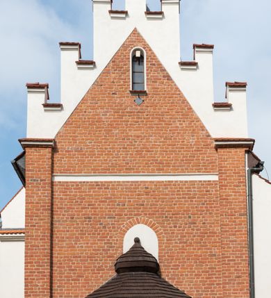 Zdjęcie nr 3: Kościół jest usytuowany w centrum wsi Rudawa, na północ od głównej drogi z Zabierzowa do Chrzanowa. Teren wokół niego jest otoczony wysokim, kamiennym murem z nieregularnych ciosów kamienia, oszkarpowanym, tynkowanym, z wyjątkiem zewnętrznej części muru na zachód od południowej bramki. W murze znajdują się trzy wejścia, od wschodu, południa i zachodu. W części wschodniej muru znajduje się trójosiowa brama wjazdowa, zwieńczona łukiem wklęsło-wypukłym, z trzema przelotami: środkowym wyższym i szerszym, zamkniętym łukiem odcinkowym i bocznymi węższymi i niższymi, zamkniętymi łukiem półkolistym (północne zamurowane). Część środkowa jest flankowana zdwojonymi pilastrami, podtrzymującymi profilowane uskokowe belkowanie z przyczółkiem o profilowanym łuku falistym, zwieńczonym równoramiennym krzyżem. W przyczółku wnęka z figurą św. Floriana. Bramki od strony zachodniej i południowej prostokątne, z przejściem zakończonym płaskim łukiem odcinkowym, z profilowanym gzymsem, zwieńczonym trójkątnym przyczółkiem. Przejścia zamykane drewnianymi ażurowymi i pomalowanymi na ciemnobrązowo jednoskrzydłowymi drzwiami. Poprzez bramkę od zachodu zejście kamiennymi schodami poprowadzonymi wzdłuż muru na dziedziniec plebański, usytuowany poniżej terenu kościelnego. 
W północno-wschodnim narożniku muru niewielka murowana i tynkowana kostnica na planie kwadratu, nakryta dachem namiotowym, łamanym, zakończonym ośmioboczną ślepą latarnią.

Po stronie południowej, poniżej placu kościelnego, do muru przylega murowana, tynkowana, prostokątna i dwukondygnacyjna „zegarowa” wieża bramna nakryta namiotowym dachem z wysoką drewnianą ośmioboczną latarnią o cebulastym hełmie. W wieży znajduje się przejazd wiodący na dziedziniec plebański, z sienią otwartą na przestrzał w dolnej kondygnacji i z lamusem dostępnym od strony placu kościelnego w górnej. 

W południowej części muru, w pobliżu południowo-wschodniego narożnika placu kościelnego, nadbudowana kamienna dzwonnica parawanowa z zawieszonymi czterema dzwonami.  

We wschodniej części placu kościelnego pomiędzy bramką wschodnią a kostnicą znajduje się kamienna ambona, o ośmiobocznej podstawie przechodzącej w szerszy, również ośmioboczny korpus, zakończony kamiennym parapetem, z kamiennymi schodami prowadzącymi na ambonę od strony wschodniej. 

Kościół jest orientowany, prawie w całości zbudowany z cegły, otynkowany z wyjątkiem prezbiterium. Wnętrze kościoła tworzy niewielkie, prostokątne, jednoprzęsłowe prezbiterium zakończone prostą ścianą i nakryte pozornym sklepieniem krzyżowo-żebrowym. Nawa jest szersza, prawie kwadratowa, nakryta drewnianym stropem. Prezbiterium z nawą są połączone szeroką, ostrołukową arkadą w ścianie tęczowej. Od północy do prezbiterium przylega założona na planie prostokąta dwuprzęsłowa zakrystia, nakryta sklepieniem krzyżowym. Wejście do zakrystii zaznaczone gotyckim, kamiennym, sfazowanym portalem zamkniętym łukiem ostrym. Od zachodu do zakrystii przylega niewielkie pomieszczenie gospodarcze, do którego z zakrystii prowadzą ostrołukowe drzwi. Zakrystia oświetlona ostrołukowym oknem w ścianie wschodniej, wypełnionym witrażem z tafelek w kształcie sześciokąta foremnego, ze szkła surowego, tzw. katedralnego. 

Od południa do nawy przylega kaplica o formach renesansowych, dwukondygnacyjna, założona na planie kwadratu. W dolnej kondygnacji sklepiona krzyżowo-żebrowo kruchta otwarta do nawy szeroką, zamkniętą półkoliście arkadą.

Ponad kruchtą kaplica św. Kazimierza, nakryta wspartą na pendentywach kopułą z latarnią. Z kruchty do kaplicy prowadzą kręte kamienne schody umieszczone od zachodu w półkolistej wieżyczce. Prostokątne wejście z krypty na klatkę schodową ujęte kamiennym profilowanym portalem. Kaplica otwarta do nawy szeroką, zamkniętą półkoliście arkadą, o kształcie i wymiarach analogicznych do arkady znajdującej się poniżej. Kaplicę, prócz latarni, oświetla prostokątne okno w ścianie południowej, wypełnione witrażem z tafelek w kształcie gomółek, ze szkła surowego, tzw. katedralnego. Na zachodniej ścianie nawy chór muzyczny, dostępny klatką schodową ukrytą w zewnętrznym aneksie przylegającym do zachodniej elewacji nawy i południowej elewacji wieży-dzwonnicy. 

Nawę i prezbiterium oświetlają umieszczone w południowych ścianach prostokątne, rozglifione okna: jedno w prezbiterium, dwa w nawie. Wszystkie wypełnione witrażami z tafelek w kształcie gomółek, ze szkła surowego, tzw. katedralnego. 

Do kościoła prowadzą dwa wejścia: poprzez arkadę z kruchty południowej oraz szerokie wejście główne prostokątne, zamknięte łukiem odcinkowym, prowadzące do kościoła z obszernej kruchty od strony zachodniej, znajdującej się w murowanym przyziemiu wieży - dzwonnicy. Kruchta, założona na planie kwadratu i nakryta murowanym stropem, doświetlona jest dwoma prostokątnymi oknami umieszczonymi naprzeciw siebie w ścianach północnej i południowej.
 
W zewnętrznej elewacji kościoła widoczny niewysoki kamienny cokół wykonany z nieregularnych ciosów kamienia. Prezbiterium, niższe od nawy, murowane z cegły w układzie wedyjskim, z domieszką układu polskiego. Wschodnie naroża prezbiterium zaakcentowane płaskimi lizenami. We wschodniej ścianie widoczny zarys zamurowanego wydłużonego okna zamkniętego lekko zaostrzonym łukiem, w trójkątnym szczycie znajduje się niewielkie wąskie okienko zakończone łukiem półkolistym. Południowa ściana prezbiterium ozdobiona fryzem z cegieł. Do ściany północnej prezbiterium przylega zakrystia, oszkarpowana, nakryta dachem pulpitowym, z dobudowanym od niej niewielkim aneksem, nakrytym takim samym zadaszeniem. Do wschodniej ściany prezbiterium przylega ogrójec nakryty dachem namiotowym z cebulastym zwieńczeniem, wspartym na sześciu smukłych, profilowanych drewnianych słupach z mieczami, pomiędzy którymi od północy i południa ażurowa drewniana balustrada. 

Nawa oszkarpowana w narożnikach. Elewacje bez podziałów architektonicznych. Od strony południowej do nawy dobudowana dwukondygnacyjna kaplica nakryta kopułą z latarnią, podzielona na dwie kondygnacje. W dolnej kondygnacji od południa wejście do kruchty zaznaczone kamiennym portalem o sfazowanych węgarach i lekko zaostrzonym łuku. Wejście zamykają drewniane dwuskrzydłowe drzwi ozdobione kratownicą z żelaznych listew. Od zachodu do kaplicy przylega półokrągła wieżyczka nakryta daszkiem stożkowym. 

Do zachodniej fasady kościoła dostawiona niska, założona na planie kwadratu trójkondygnacyjna wieża-dzwonnica: w dolnej części murowana, w narożach wzmocniona kamiennymi szkarpami, w górnej drewniana konstrukcji słupowo-ramowej z nadwieszoną izbicą i nakryta dachem półszczytowym. W dolnej, murowanej kondygnacji, na osi kościoła, prostokątne wejście do kruchty zaakcentowane przedsionkiem w kształcie ostrołukowej arkady i czterostopniowymi schodami. Przedsionek nakryty dachem dwuspadowym. Do zachodniej elewacji nawy i południowej elewacji dzwonnicy przylega niewielki, wysoki drewniany aneks, nakryty dachem pulpitowym, mieszczący klatkę schodową prowadzącą na górną kondygnację dzwonnicy i na chór muzyczny w nawie kościoła. Prostokątne wejście w południowej ścianie aneksu, do którego prowadzą pięciostopniowe proste schody. Ponad nimi, na wysokości drugiej kondygnacji dzwonnicy, niewielkie kwadratowe okno. 

Prezbiterium i nawa przykryte stromymi dachami dwuspadowymi, zamkniętymi od wschodu i zachodu szczytami sterczynowymi. Wieżyczka na sygnaturkę ośmioboczna, w dolnej części barokowa, w górnej części nowsza.