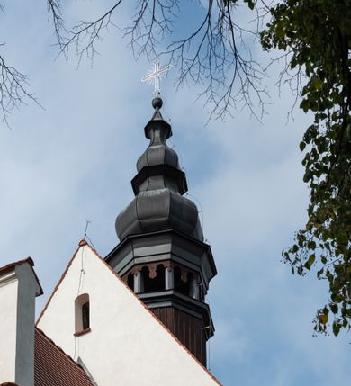 Zdjęcie nr 10: Kościół jest usytuowany w centrum wsi Rudawa, na północ od głównej drogi z Zabierzowa do Chrzanowa. Teren wokół niego jest otoczony wysokim, kamiennym murem z nieregularnych ciosów kamienia, oszkarpowanym, tynkowanym, z wyjątkiem zewnętrznej części muru na zachód od południowej bramki. W murze znajdują się trzy wejścia, od wschodu, południa i zachodu. W części wschodniej muru znajduje się trójosiowa brama wjazdowa, zwieńczona łukiem wklęsło-wypukłym, z trzema przelotami: środkowym wyższym i szerszym, zamkniętym łukiem odcinkowym i bocznymi węższymi i niższymi, zamkniętymi łukiem półkolistym (północne zamurowane). Część środkowa jest flankowana zdwojonymi pilastrami, podtrzymującymi profilowane uskokowe belkowanie z przyczółkiem o profilowanym łuku falistym, zwieńczonym równoramiennym krzyżem. W przyczółku wnęka z figurą św. Floriana. Bramki od strony zachodniej i południowej prostokątne, z przejściem zakończonym płaskim łukiem odcinkowym, z profilowanym gzymsem, zwieńczonym trójkątnym przyczółkiem. Przejścia zamykane drewnianymi ażurowymi i pomalowanymi na ciemnobrązowo jednoskrzydłowymi drzwiami. Poprzez bramkę od zachodu zejście kamiennymi schodami poprowadzonymi wzdłuż muru na dziedziniec plebański, usytuowany poniżej terenu kościelnego. 
W północno-wschodnim narożniku muru niewielka murowana i tynkowana kostnica na planie kwadratu, nakryta dachem namiotowym, łamanym, zakończonym ośmioboczną ślepą latarnią.

Po stronie południowej, poniżej placu kościelnego, do muru przylega murowana, tynkowana, prostokątna i dwukondygnacyjna „zegarowa” wieża bramna nakryta namiotowym dachem z wysoką drewnianą ośmioboczną latarnią o cebulastym hełmie. W wieży znajduje się przejazd wiodący na dziedziniec plebański, z sienią otwartą na przestrzał w dolnej kondygnacji i z lamusem dostępnym od strony placu kościelnego w górnej. 

W południowej części muru, w pobliżu południowo-wschodniego narożnika placu kościelnego, nadbudowana kamienna dzwonnica parawanowa z zawieszonymi czterema dzwonami.  

We wschodniej części placu kościelnego pomiędzy bramką wschodnią a kostnicą znajduje się kamienna ambona, o ośmiobocznej podstawie przechodzącej w szerszy, również ośmioboczny korpus, zakończony kamiennym parapetem, z kamiennymi schodami prowadzącymi na ambonę od strony wschodniej. 

Kościół jest orientowany, prawie w całości zbudowany z cegły, otynkowany z wyjątkiem prezbiterium. Wnętrze kościoła tworzy niewielkie, prostokątne, jednoprzęsłowe prezbiterium zakończone prostą ścianą i nakryte pozornym sklepieniem krzyżowo-żebrowym. Nawa jest szersza, prawie kwadratowa, nakryta drewnianym stropem. Prezbiterium z nawą są połączone szeroką, ostrołukową arkadą w ścianie tęczowej. Od północy do prezbiterium przylega założona na planie prostokąta dwuprzęsłowa zakrystia, nakryta sklepieniem krzyżowym. Wejście do zakrystii zaznaczone gotyckim, kamiennym, sfazowanym portalem zamkniętym łukiem ostrym. Od zachodu do zakrystii przylega niewielkie pomieszczenie gospodarcze, do którego z zakrystii prowadzą ostrołukowe drzwi. Zakrystia oświetlona ostrołukowym oknem w ścianie wschodniej, wypełnionym witrażem z tafelek w kształcie sześciokąta foremnego, ze szkła surowego, tzw. katedralnego. 

Od południa do nawy przylega kaplica o formach renesansowych, dwukondygnacyjna, założona na planie kwadratu. W dolnej kondygnacji sklepiona krzyżowo-żebrowo kruchta otwarta do nawy szeroką, zamkniętą półkoliście arkadą.

Ponad kruchtą kaplica św. Kazimierza, nakryta wspartą na pendentywach kopułą z latarnią. Z kruchty do kaplicy prowadzą kręte kamienne schody umieszczone od zachodu w półkolistej wieżyczce. Prostokątne wejście z krypty na klatkę schodową ujęte kamiennym profilowanym portalem. Kaplica otwarta do nawy szeroką, zamkniętą półkoliście arkadą, o kształcie i wymiarach analogicznych do arkady znajdującej się poniżej. Kaplicę, prócz latarni, oświetla prostokątne okno w ścianie południowej, wypełnione witrażem z tafelek w kształcie gomółek, ze szkła surowego, tzw. katedralnego. Na zachodniej ścianie nawy chór muzyczny, dostępny klatką schodową ukrytą w zewnętrznym aneksie przylegającym do zachodniej elewacji nawy i południowej elewacji wieży-dzwonnicy. 

Nawę i prezbiterium oświetlają umieszczone w południowych ścianach prostokątne, rozglifione okna: jedno w prezbiterium, dwa w nawie. Wszystkie wypełnione witrażami z tafelek w kształcie gomółek, ze szkła surowego, tzw. katedralnego. 

Do kościoła prowadzą dwa wejścia: poprzez arkadę z kruchty południowej oraz szerokie wejście główne prostokątne, zamknięte łukiem odcinkowym, prowadzące do kościoła z obszernej kruchty od strony zachodniej, znajdującej się w murowanym przyziemiu wieży - dzwonnicy. Kruchta, założona na planie kwadratu i nakryta murowanym stropem, doświetlona jest dwoma prostokątnymi oknami umieszczonymi naprzeciw siebie w ścianach północnej i południowej.
 
W zewnętrznej elewacji kościoła widoczny niewysoki kamienny cokół wykonany z nieregularnych ciosów kamienia. Prezbiterium, niższe od nawy, murowane z cegły w układzie wedyjskim, z domieszką układu polskiego. Wschodnie naroża prezbiterium zaakcentowane płaskimi lizenami. We wschodniej ścianie widoczny zarys zamurowanego wydłużonego okna zamkniętego lekko zaostrzonym łukiem, w trójkątnym szczycie znajduje się niewielkie wąskie okienko zakończone łukiem półkolistym. Południowa ściana prezbiterium ozdobiona fryzem z cegieł. Do ściany północnej prezbiterium przylega zakrystia, oszkarpowana, nakryta dachem pulpitowym, z dobudowanym od niej niewielkim aneksem, nakrytym takim samym zadaszeniem. Do wschodniej ściany prezbiterium przylega ogrójec nakryty dachem namiotowym z cebulastym zwieńczeniem, wspartym na sześciu smukłych, profilowanych drewnianych słupach z mieczami, pomiędzy którymi od północy i południa ażurowa drewniana balustrada. 

Nawa oszkarpowana w narożnikach. Elewacje bez podziałów architektonicznych. Od strony południowej do nawy dobudowana dwukondygnacyjna kaplica nakryta kopułą z latarnią, podzielona na dwie kondygnacje. W dolnej kondygnacji od południa wejście do kruchty zaznaczone kamiennym portalem o sfazowanych węgarach i lekko zaostrzonym łuku. Wejście zamykają drewniane dwuskrzydłowe drzwi ozdobione kratownicą z żelaznych listew. Od zachodu do kaplicy przylega półokrągła wieżyczka nakryta daszkiem stożkowym. 

Do zachodniej fasady kościoła dostawiona niska, założona na planie kwadratu trójkondygnacyjna wieża-dzwonnica: w dolnej części murowana, w narożach wzmocniona kamiennymi szkarpami, w górnej drewniana konstrukcji słupowo-ramowej z nadwieszoną izbicą i nakryta dachem półszczytowym. W dolnej, murowanej kondygnacji, na osi kościoła, prostokątne wejście do kruchty zaakcentowane przedsionkiem w kształcie ostrołukowej arkady i czterostopniowymi schodami. Przedsionek nakryty dachem dwuspadowym. Do zachodniej elewacji nawy i południowej elewacji dzwonnicy przylega niewielki, wysoki drewniany aneks, nakryty dachem pulpitowym, mieszczący klatkę schodową prowadzącą na górną kondygnację dzwonnicy i na chór muzyczny w nawie kościoła. Prostokątne wejście w południowej ścianie aneksu, do którego prowadzą pięciostopniowe proste schody. Ponad nimi, na wysokości drugiej kondygnacji dzwonnicy, niewielkie kwadratowe okno. 

Prezbiterium i nawa przykryte stromymi dachami dwuspadowymi, zamkniętymi od wschodu i zachodu szczytami sterczynowymi. Wieżyczka na sygnaturkę ośmioboczna, w dolnej części barokowa, w górnej części nowsza.