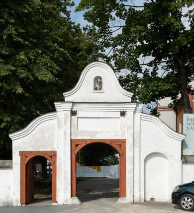 Zdjęcie nr 11: Kościół jest usytuowany w centrum wsi Rudawa, na północ od głównej drogi z Zabierzowa do Chrzanowa. Teren wokół niego jest otoczony wysokim, kamiennym murem z nieregularnych ciosów kamienia, oszkarpowanym, tynkowanym, z wyjątkiem zewnętrznej części muru na zachód od południowej bramki. W murze znajdują się trzy wejścia, od wschodu, południa i zachodu. W części wschodniej muru znajduje się trójosiowa brama wjazdowa, zwieńczona łukiem wklęsło-wypukłym, z trzema przelotami: środkowym wyższym i szerszym, zamkniętym łukiem odcinkowym i bocznymi węższymi i niższymi, zamkniętymi łukiem półkolistym (północne zamurowane). Część środkowa jest flankowana zdwojonymi pilastrami, podtrzymującymi profilowane uskokowe belkowanie z przyczółkiem o profilowanym łuku falistym, zwieńczonym równoramiennym krzyżem. W przyczółku wnęka z figurą św. Floriana. Bramki od strony zachodniej i południowej prostokątne, z przejściem zakończonym płaskim łukiem odcinkowym, z profilowanym gzymsem, zwieńczonym trójkątnym przyczółkiem. Przejścia zamykane drewnianymi ażurowymi i pomalowanymi na ciemnobrązowo jednoskrzydłowymi drzwiami. Poprzez bramkę od zachodu zejście kamiennymi schodami poprowadzonymi wzdłuż muru na dziedziniec plebański, usytuowany poniżej terenu kościelnego. 
W północno-wschodnim narożniku muru niewielka murowana i tynkowana kostnica na planie kwadratu, nakryta dachem namiotowym, łamanym, zakończonym ośmioboczną ślepą latarnią.

Po stronie południowej, poniżej placu kościelnego, do muru przylega murowana, tynkowana, prostokątna i dwukondygnacyjna „zegarowa” wieża bramna nakryta namiotowym dachem z wysoką drewnianą ośmioboczną latarnią o cebulastym hełmie. W wieży znajduje się przejazd wiodący na dziedziniec plebański, z sienią otwartą na przestrzał w dolnej kondygnacji i z lamusem dostępnym od strony placu kościelnego w górnej. 

W południowej części muru, w pobliżu południowo-wschodniego narożnika placu kościelnego, nadbudowana kamienna dzwonnica parawanowa z zawieszonymi czterema dzwonami.  

We wschodniej części placu kościelnego pomiędzy bramką wschodnią a kostnicą znajduje się kamienna ambona, o ośmiobocznej podstawie przechodzącej w szerszy, również ośmioboczny korpus, zakończony kamiennym parapetem, z kamiennymi schodami prowadzącymi na ambonę od strony wschodniej. 

Kościół jest orientowany, prawie w całości zbudowany z cegły, otynkowany z wyjątkiem prezbiterium. Wnętrze kościoła tworzy niewielkie, prostokątne, jednoprzęsłowe prezbiterium zakończone prostą ścianą i nakryte pozornym sklepieniem krzyżowo-żebrowym. Nawa jest szersza, prawie kwadratowa, nakryta drewnianym stropem. Prezbiterium z nawą są połączone szeroką, ostrołukową arkadą w ścianie tęczowej. Od północy do prezbiterium przylega założona na planie prostokąta dwuprzęsłowa zakrystia, nakryta sklepieniem krzyżowym. Wejście do zakrystii zaznaczone gotyckim, kamiennym, sfazowanym portalem zamkniętym łukiem ostrym. Od zachodu do zakrystii przylega niewielkie pomieszczenie gospodarcze, do którego z zakrystii prowadzą ostrołukowe drzwi. Zakrystia oświetlona ostrołukowym oknem w ścianie wschodniej, wypełnionym witrażem z tafelek w kształcie sześciokąta foremnego, ze szkła surowego, tzw. katedralnego. 

Od południa do nawy przylega kaplica o formach renesansowych, dwukondygnacyjna, założona na planie kwadratu. W dolnej kondygnacji sklepiona krzyżowo-żebrowo kruchta otwarta do nawy szeroką, zamkniętą półkoliście arkadą.

Ponad kruchtą kaplica św. Kazimierza, nakryta wspartą na pendentywach kopułą z latarnią. Z kruchty do kaplicy prowadzą kręte kamienne schody umieszczone od zachodu w półkolistej wieżyczce. Prostokątne wejście z krypty na klatkę schodową ujęte kamiennym profilowanym portalem. Kaplica otwarta do nawy szeroką, zamkniętą półkoliście arkadą, o kształcie i wymiarach analogicznych do arkady znajdującej się poniżej. Kaplicę, prócz latarni, oświetla prostokątne okno w ścianie południowej, wypełnione witrażem z tafelek w kształcie gomółek, ze szkła surowego, tzw. katedralnego. Na zachodniej ścianie nawy chór muzyczny, dostępny klatką schodową ukrytą w zewnętrznym aneksie przylegającym do zachodniej elewacji nawy i południowej elewacji wieży-dzwonnicy. 

Nawę i prezbiterium oświetlają umieszczone w południowych ścianach prostokątne, rozglifione okna: jedno w prezbiterium, dwa w nawie. Wszystkie wypełnione witrażami z tafelek w kształcie gomółek, ze szkła surowego, tzw. katedralnego. 

Do kościoła prowadzą dwa wejścia: poprzez arkadę z kruchty południowej oraz szerokie wejście główne prostokątne, zamknięte łukiem odcinkowym, prowadzące do kościoła z obszernej kruchty od strony zachodniej, znajdującej się w murowanym przyziemiu wieży - dzwonnicy. Kruchta, założona na planie kwadratu i nakryta murowanym stropem, doświetlona jest dwoma prostokątnymi oknami umieszczonymi naprzeciw siebie w ścianach północnej i południowej.
 
W zewnętrznej elewacji kościoła widoczny niewysoki kamienny cokół wykonany z nieregularnych ciosów kamienia. Prezbiterium, niższe od nawy, murowane z cegły w układzie wedyjskim, z domieszką układu polskiego. Wschodnie naroża prezbiterium zaakcentowane płaskimi lizenami. We wschodniej ścianie widoczny zarys zamurowanego wydłużonego okna zamkniętego lekko zaostrzonym łukiem, w trójkątnym szczycie znajduje się niewielkie wąskie okienko zakończone łukiem półkolistym. Południowa ściana prezbiterium ozdobiona fryzem z cegieł. Do ściany północnej prezbiterium przylega zakrystia, oszkarpowana, nakryta dachem pulpitowym, z dobudowanym od niej niewielkim aneksem, nakrytym takim samym zadaszeniem. Do wschodniej ściany prezbiterium przylega ogrójec nakryty dachem namiotowym z cebulastym zwieńczeniem, wspartym na sześciu smukłych, profilowanych drewnianych słupach z mieczami, pomiędzy którymi od północy i południa ażurowa drewniana balustrada. 

Nawa oszkarpowana w narożnikach. Elewacje bez podziałów architektonicznych. Od strony południowej do nawy dobudowana dwukondygnacyjna kaplica nakryta kopułą z latarnią, podzielona na dwie kondygnacje. W dolnej kondygnacji od południa wejście do kruchty zaznaczone kamiennym portalem o sfazowanych węgarach i lekko zaostrzonym łuku. Wejście zamykają drewniane dwuskrzydłowe drzwi ozdobione kratownicą z żelaznych listew. Od zachodu do kaplicy przylega półokrągła wieżyczka nakryta daszkiem stożkowym. 

Do zachodniej fasady kościoła dostawiona niska, założona na planie kwadratu trójkondygnacyjna wieża-dzwonnica: w dolnej części murowana, w narożach wzmocniona kamiennymi szkarpami, w górnej drewniana konstrukcji słupowo-ramowej z nadwieszoną izbicą i nakryta dachem półszczytowym. W dolnej, murowanej kondygnacji, na osi kościoła, prostokątne wejście do kruchty zaakcentowane przedsionkiem w kształcie ostrołukowej arkady i czterostopniowymi schodami. Przedsionek nakryty dachem dwuspadowym. Do zachodniej elewacji nawy i południowej elewacji dzwonnicy przylega niewielki, wysoki drewniany aneks, nakryty dachem pulpitowym, mieszczący klatkę schodową prowadzącą na górną kondygnację dzwonnicy i na chór muzyczny w nawie kościoła. Prostokątne wejście w południowej ścianie aneksu, do którego prowadzą pięciostopniowe proste schody. Ponad nimi, na wysokości drugiej kondygnacji dzwonnicy, niewielkie kwadratowe okno. 

Prezbiterium i nawa przykryte stromymi dachami dwuspadowymi, zamkniętymi od wschodu i zachodu szczytami sterczynowymi. Wieżyczka na sygnaturkę ośmioboczna, w dolnej części barokowa, w górnej części nowsza.