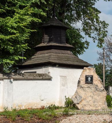 Zdjęcie nr 14: Kościół jest usytuowany w centrum wsi Rudawa, na północ od głównej drogi z Zabierzowa do Chrzanowa. Teren wokół niego jest otoczony wysokim, kamiennym murem z nieregularnych ciosów kamienia, oszkarpowanym, tynkowanym, z wyjątkiem zewnętrznej części muru na zachód od południowej bramki. W murze znajdują się trzy wejścia, od wschodu, południa i zachodu. W części wschodniej muru znajduje się trójosiowa brama wjazdowa, zwieńczona łukiem wklęsło-wypukłym, z trzema przelotami: środkowym wyższym i szerszym, zamkniętym łukiem odcinkowym i bocznymi węższymi i niższymi, zamkniętymi łukiem półkolistym (północne zamurowane). Część środkowa jest flankowana zdwojonymi pilastrami, podtrzymującymi profilowane uskokowe belkowanie z przyczółkiem o profilowanym łuku falistym, zwieńczonym równoramiennym krzyżem. W przyczółku wnęka z figurą św. Floriana. Bramki od strony zachodniej i południowej prostokątne, z przejściem zakończonym płaskim łukiem odcinkowym, z profilowanym gzymsem, zwieńczonym trójkątnym przyczółkiem. Przejścia zamykane drewnianymi ażurowymi i pomalowanymi na ciemnobrązowo jednoskrzydłowymi drzwiami. Poprzez bramkę od zachodu zejście kamiennymi schodami poprowadzonymi wzdłuż muru na dziedziniec plebański, usytuowany poniżej terenu kościelnego. 
W północno-wschodnim narożniku muru niewielka murowana i tynkowana kostnica na planie kwadratu, nakryta dachem namiotowym, łamanym, zakończonym ośmioboczną ślepą latarnią.

Po stronie południowej, poniżej placu kościelnego, do muru przylega murowana, tynkowana, prostokątna i dwukondygnacyjna „zegarowa” wieża bramna nakryta namiotowym dachem z wysoką drewnianą ośmioboczną latarnią o cebulastym hełmie. W wieży znajduje się przejazd wiodący na dziedziniec plebański, z sienią otwartą na przestrzał w dolnej kondygnacji i z lamusem dostępnym od strony placu kościelnego w górnej. 

W południowej części muru, w pobliżu południowo-wschodniego narożnika placu kościelnego, nadbudowana kamienna dzwonnica parawanowa z zawieszonymi czterema dzwonami.  

We wschodniej części placu kościelnego pomiędzy bramką wschodnią a kostnicą znajduje się kamienna ambona, o ośmiobocznej podstawie przechodzącej w szerszy, również ośmioboczny korpus, zakończony kamiennym parapetem, z kamiennymi schodami prowadzącymi na ambonę od strony wschodniej. 

Kościół jest orientowany, prawie w całości zbudowany z cegły, otynkowany z wyjątkiem prezbiterium. Wnętrze kościoła tworzy niewielkie, prostokątne, jednoprzęsłowe prezbiterium zakończone prostą ścianą i nakryte pozornym sklepieniem krzyżowo-żebrowym. Nawa jest szersza, prawie kwadratowa, nakryta drewnianym stropem. Prezbiterium z nawą są połączone szeroką, ostrołukową arkadą w ścianie tęczowej. Od północy do prezbiterium przylega założona na planie prostokąta dwuprzęsłowa zakrystia, nakryta sklepieniem krzyżowym. Wejście do zakrystii zaznaczone gotyckim, kamiennym, sfazowanym portalem zamkniętym łukiem ostrym. Od zachodu do zakrystii przylega niewielkie pomieszczenie gospodarcze, do którego z zakrystii prowadzą ostrołukowe drzwi. Zakrystia oświetlona ostrołukowym oknem w ścianie wschodniej, wypełnionym witrażem z tafelek w kształcie sześciokąta foremnego, ze szkła surowego, tzw. katedralnego. 

Od południa do nawy przylega kaplica o formach renesansowych, dwukondygnacyjna, założona na planie kwadratu. W dolnej kondygnacji sklepiona krzyżowo-żebrowo kruchta otwarta do nawy szeroką, zamkniętą półkoliście arkadą.

Ponad kruchtą kaplica św. Kazimierza, nakryta wspartą na pendentywach kopułą z latarnią. Z kruchty do kaplicy prowadzą kręte kamienne schody umieszczone od zachodu w półkolistej wieżyczce. Prostokątne wejście z krypty na klatkę schodową ujęte kamiennym profilowanym portalem. Kaplica otwarta do nawy szeroką, zamkniętą półkoliście arkadą, o kształcie i wymiarach analogicznych do arkady znajdującej się poniżej. Kaplicę, prócz latarni, oświetla prostokątne okno w ścianie południowej, wypełnione witrażem z tafelek w kształcie gomółek, ze szkła surowego, tzw. katedralnego. Na zachodniej ścianie nawy chór muzyczny, dostępny klatką schodową ukrytą w zewnętrznym aneksie przylegającym do zachodniej elewacji nawy i południowej elewacji wieży-dzwonnicy. 

Nawę i prezbiterium oświetlają umieszczone w południowych ścianach prostokątne, rozglifione okna: jedno w prezbiterium, dwa w nawie. Wszystkie wypełnione witrażami z tafelek w kształcie gomółek, ze szkła surowego, tzw. katedralnego. 

Do kościoła prowadzą dwa wejścia: poprzez arkadę z kruchty południowej oraz szerokie wejście główne prostokątne, zamknięte łukiem odcinkowym, prowadzące do kościoła z obszernej kruchty od strony zachodniej, znajdującej się w murowanym przyziemiu wieży - dzwonnicy. Kruchta, założona na planie kwadratu i nakryta murowanym stropem, doświetlona jest dwoma prostokątnymi oknami umieszczonymi naprzeciw siebie w ścianach północnej i południowej.
 
W zewnętrznej elewacji kościoła widoczny niewysoki kamienny cokół wykonany z nieregularnych ciosów kamienia. Prezbiterium, niższe od nawy, murowane z cegły w układzie wedyjskim, z domieszką układu polskiego. Wschodnie naroża prezbiterium zaakcentowane płaskimi lizenami. We wschodniej ścianie widoczny zarys zamurowanego wydłużonego okna zamkniętego lekko zaostrzonym łukiem, w trójkątnym szczycie znajduje się niewielkie wąskie okienko zakończone łukiem półkolistym. Południowa ściana prezbiterium ozdobiona fryzem z cegieł. Do ściany północnej prezbiterium przylega zakrystia, oszkarpowana, nakryta dachem pulpitowym, z dobudowanym od niej niewielkim aneksem, nakrytym takim samym zadaszeniem. Do wschodniej ściany prezbiterium przylega ogrójec nakryty dachem namiotowym z cebulastym zwieńczeniem, wspartym na sześciu smukłych, profilowanych drewnianych słupach z mieczami, pomiędzy którymi od północy i południa ażurowa drewniana balustrada. 

Nawa oszkarpowana w narożnikach. Elewacje bez podziałów architektonicznych. Od strony południowej do nawy dobudowana dwukondygnacyjna kaplica nakryta kopułą z latarnią, podzielona na dwie kondygnacje. W dolnej kondygnacji od południa wejście do kruchty zaznaczone kamiennym portalem o sfazowanych węgarach i lekko zaostrzonym łuku. Wejście zamykają drewniane dwuskrzydłowe drzwi ozdobione kratownicą z żelaznych listew. Od zachodu do kaplicy przylega półokrągła wieżyczka nakryta daszkiem stożkowym. 

Do zachodniej fasady kościoła dostawiona niska, założona na planie kwadratu trójkondygnacyjna wieża-dzwonnica: w dolnej części murowana, w narożach wzmocniona kamiennymi szkarpami, w górnej drewniana konstrukcji słupowo-ramowej z nadwieszoną izbicą i nakryta dachem półszczytowym. W dolnej, murowanej kondygnacji, na osi kościoła, prostokątne wejście do kruchty zaakcentowane przedsionkiem w kształcie ostrołukowej arkady i czterostopniowymi schodami. Przedsionek nakryty dachem dwuspadowym. Do zachodniej elewacji nawy i południowej elewacji dzwonnicy przylega niewielki, wysoki drewniany aneks, nakryty dachem pulpitowym, mieszczący klatkę schodową prowadzącą na górną kondygnację dzwonnicy i na chór muzyczny w nawie kościoła. Prostokątne wejście w południowej ścianie aneksu, do którego prowadzą pięciostopniowe proste schody. Ponad nimi, na wysokości drugiej kondygnacji dzwonnicy, niewielkie kwadratowe okno. 

Prezbiterium i nawa przykryte stromymi dachami dwuspadowymi, zamkniętymi od wschodu i zachodu szczytami sterczynowymi. Wieżyczka na sygnaturkę ośmioboczna, w dolnej części barokowa, w górnej części nowsza.