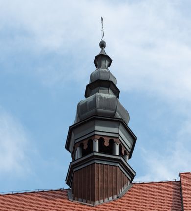 Zdjęcie nr 9: Kościół jest usytuowany w centrum wsi Rudawa, na północ od głównej drogi z Zabierzowa do Chrzanowa. Teren wokół niego jest otoczony wysokim, kamiennym murem z nieregularnych ciosów kamienia, oszkarpowanym, tynkowanym, z wyjątkiem zewnętrznej części muru na zachód od południowej bramki. W murze znajdują się trzy wejścia, od wschodu, południa i zachodu. W części wschodniej muru znajduje się trójosiowa brama wjazdowa, zwieńczona łukiem wklęsło-wypukłym, z trzema przelotami: środkowym wyższym i szerszym, zamkniętym łukiem odcinkowym i bocznymi węższymi i niższymi, zamkniętymi łukiem półkolistym (północne zamurowane). Część środkowa jest flankowana zdwojonymi pilastrami, podtrzymującymi profilowane uskokowe belkowanie z przyczółkiem o profilowanym łuku falistym, zwieńczonym równoramiennym krzyżem. W przyczółku wnęka z figurą św. Floriana. Bramki od strony zachodniej i południowej prostokątne, z przejściem zakończonym płaskim łukiem odcinkowym, z profilowanym gzymsem, zwieńczonym trójkątnym przyczółkiem. Przejścia zamykane drewnianymi ażurowymi i pomalowanymi na ciemnobrązowo jednoskrzydłowymi drzwiami. Poprzez bramkę od zachodu zejście kamiennymi schodami poprowadzonymi wzdłuż muru na dziedziniec plebański, usytuowany poniżej terenu kościelnego. 
W północno-wschodnim narożniku muru niewielka murowana i tynkowana kostnica na planie kwadratu, nakryta dachem namiotowym, łamanym, zakończonym ośmioboczną ślepą latarnią.

Po stronie południowej, poniżej placu kościelnego, do muru przylega murowana, tynkowana, prostokątna i dwukondygnacyjna „zegarowa” wieża bramna nakryta namiotowym dachem z wysoką drewnianą ośmioboczną latarnią o cebulastym hełmie. W wieży znajduje się przejazd wiodący na dziedziniec plebański, z sienią otwartą na przestrzał w dolnej kondygnacji i z lamusem dostępnym od strony placu kościelnego w górnej. 

W południowej części muru, w pobliżu południowo-wschodniego narożnika placu kościelnego, nadbudowana kamienna dzwonnica parawanowa z zawieszonymi czterema dzwonami.  

We wschodniej części placu kościelnego pomiędzy bramką wschodnią a kostnicą znajduje się kamienna ambona, o ośmiobocznej podstawie przechodzącej w szerszy, również ośmioboczny korpus, zakończony kamiennym parapetem, z kamiennymi schodami prowadzącymi na ambonę od strony wschodniej. 

Kościół jest orientowany, prawie w całości zbudowany z cegły, otynkowany z wyjątkiem prezbiterium. Wnętrze kościoła tworzy niewielkie, prostokątne, jednoprzęsłowe prezbiterium zakończone prostą ścianą i nakryte pozornym sklepieniem krzyżowo-żebrowym. Nawa jest szersza, prawie kwadratowa, nakryta drewnianym stropem. Prezbiterium z nawą są połączone szeroką, ostrołukową arkadą w ścianie tęczowej. Od północy do prezbiterium przylega założona na planie prostokąta dwuprzęsłowa zakrystia, nakryta sklepieniem krzyżowym. Wejście do zakrystii zaznaczone gotyckim, kamiennym, sfazowanym portalem zamkniętym łukiem ostrym. Od zachodu do zakrystii przylega niewielkie pomieszczenie gospodarcze, do którego z zakrystii prowadzą ostrołukowe drzwi. Zakrystia oświetlona ostrołukowym oknem w ścianie wschodniej, wypełnionym witrażem z tafelek w kształcie sześciokąta foremnego, ze szkła surowego, tzw. katedralnego. 

Od południa do nawy przylega kaplica o formach renesansowych, dwukondygnacyjna, założona na planie kwadratu. W dolnej kondygnacji sklepiona krzyżowo-żebrowo kruchta otwarta do nawy szeroką, zamkniętą półkoliście arkadą.

Ponad kruchtą kaplica św. Kazimierza, nakryta wspartą na pendentywach kopułą z latarnią. Z kruchty do kaplicy prowadzą kręte kamienne schody umieszczone od zachodu w półkolistej wieżyczce. Prostokątne wejście z krypty na klatkę schodową ujęte kamiennym profilowanym portalem. Kaplica otwarta do nawy szeroką, zamkniętą półkoliście arkadą, o kształcie i wymiarach analogicznych do arkady znajdującej się poniżej. Kaplicę, prócz latarni, oświetla prostokątne okno w ścianie południowej, wypełnione witrażem z tafelek w kształcie gomółek, ze szkła surowego, tzw. katedralnego. Na zachodniej ścianie nawy chór muzyczny, dostępny klatką schodową ukrytą w zewnętrznym aneksie przylegającym do zachodniej elewacji nawy i południowej elewacji wieży-dzwonnicy. 

Nawę i prezbiterium oświetlają umieszczone w południowych ścianach prostokątne, rozglifione okna: jedno w prezbiterium, dwa w nawie. Wszystkie wypełnione witrażami z tafelek w kształcie gomółek, ze szkła surowego, tzw. katedralnego. 

Do kościoła prowadzą dwa wejścia: poprzez arkadę z kruchty południowej oraz szerokie wejście główne prostokątne, zamknięte łukiem odcinkowym, prowadzące do kościoła z obszernej kruchty od strony zachodniej, znajdującej się w murowanym przyziemiu wieży - dzwonnicy. Kruchta, założona na planie kwadratu i nakryta murowanym stropem, doświetlona jest dwoma prostokątnymi oknami umieszczonymi naprzeciw siebie w ścianach północnej i południowej.
 
W zewnętrznej elewacji kościoła widoczny niewysoki kamienny cokół wykonany z nieregularnych ciosów kamienia. Prezbiterium, niższe od nawy, murowane z cegły w układzie wedyjskim, z domieszką układu polskiego. Wschodnie naroża prezbiterium zaakcentowane płaskimi lizenami. We wschodniej ścianie widoczny zarys zamurowanego wydłużonego okna zamkniętego lekko zaostrzonym łukiem, w trójkątnym szczycie znajduje się niewielkie wąskie okienko zakończone łukiem półkolistym. Południowa ściana prezbiterium ozdobiona fryzem z cegieł. Do ściany północnej prezbiterium przylega zakrystia, oszkarpowana, nakryta dachem pulpitowym, z dobudowanym od niej niewielkim aneksem, nakrytym takim samym zadaszeniem. Do wschodniej ściany prezbiterium przylega ogrójec nakryty dachem namiotowym z cebulastym zwieńczeniem, wspartym na sześciu smukłych, profilowanych drewnianych słupach z mieczami, pomiędzy którymi od północy i południa ażurowa drewniana balustrada. 

Nawa oszkarpowana w narożnikach. Elewacje bez podziałów architektonicznych. Od strony południowej do nawy dobudowana dwukondygnacyjna kaplica nakryta kopułą z latarnią, podzielona na dwie kondygnacje. W dolnej kondygnacji od południa wejście do kruchty zaznaczone kamiennym portalem o sfazowanych węgarach i lekko zaostrzonym łuku. Wejście zamykają drewniane dwuskrzydłowe drzwi ozdobione kratownicą z żelaznych listew. Od zachodu do kaplicy przylega półokrągła wieżyczka nakryta daszkiem stożkowym. 

Do zachodniej fasady kościoła dostawiona niska, założona na planie kwadratu trójkondygnacyjna wieża-dzwonnica: w dolnej części murowana, w narożach wzmocniona kamiennymi szkarpami, w górnej drewniana konstrukcji słupowo-ramowej z nadwieszoną izbicą i nakryta dachem półszczytowym. W dolnej, murowanej kondygnacji, na osi kościoła, prostokątne wejście do kruchty zaakcentowane przedsionkiem w kształcie ostrołukowej arkady i czterostopniowymi schodami. Przedsionek nakryty dachem dwuspadowym. Do zachodniej elewacji nawy i południowej elewacji dzwonnicy przylega niewielki, wysoki drewniany aneks, nakryty dachem pulpitowym, mieszczący klatkę schodową prowadzącą na górną kondygnację dzwonnicy i na chór muzyczny w nawie kościoła. Prostokątne wejście w południowej ścianie aneksu, do którego prowadzą pięciostopniowe proste schody. Ponad nimi, na wysokości drugiej kondygnacji dzwonnicy, niewielkie kwadratowe okno. 

Prezbiterium i nawa przykryte stromymi dachami dwuspadowymi, zamkniętymi od wschodu i zachodu szczytami sterczynowymi. Wieżyczka na sygnaturkę ośmioboczna, w dolnej części barokowa, w górnej części nowsza.