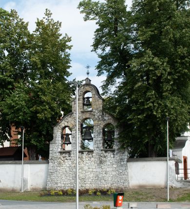 Zdjęcie nr 35: Kościół jest usytuowany w centrum wsi Rudawa, na północ od głównej drogi z Zabierzowa do Chrzanowa. Teren wokół niego jest otoczony wysokim, kamiennym murem z nieregularnych ciosów kamienia, oszkarpowanym, tynkowanym, z wyjątkiem zewnętrznej części muru na zachód od południowej bramki. W murze znajdują się trzy wejścia, od wschodu, południa i zachodu. W części wschodniej muru znajduje się trójosiowa brama wjazdowa, zwieńczona łukiem wklęsło-wypukłym, z trzema przelotami: środkowym wyższym i szerszym, zamkniętym łukiem odcinkowym i bocznymi węższymi i niższymi, zamkniętymi łukiem półkolistym (północne zamurowane). Część środkowa jest flankowana zdwojonymi pilastrami, podtrzymującymi profilowane uskokowe belkowanie z przyczółkiem o profilowanym łuku falistym, zwieńczonym równoramiennym krzyżem. W przyczółku wnęka z figurą św. Floriana. Bramki od strony zachodniej i południowej prostokątne, z przejściem zakończonym płaskim łukiem odcinkowym, z profilowanym gzymsem, zwieńczonym trójkątnym przyczółkiem. Przejścia zamykane drewnianymi ażurowymi i pomalowanymi na ciemnobrązowo jednoskrzydłowymi drzwiami. Poprzez bramkę od zachodu zejście kamiennymi schodami poprowadzonymi wzdłuż muru na dziedziniec plebański, usytuowany poniżej terenu kościelnego. 
W północno-wschodnim narożniku muru niewielka murowana i tynkowana kostnica na planie kwadratu, nakryta dachem namiotowym, łamanym, zakończonym ośmioboczną ślepą latarnią.

Po stronie południowej, poniżej placu kościelnego, do muru przylega murowana, tynkowana, prostokątna i dwukondygnacyjna „zegarowa” wieża bramna nakryta namiotowym dachem z wysoką drewnianą ośmioboczną latarnią o cebulastym hełmie. W wieży znajduje się przejazd wiodący na dziedziniec plebański, z sienią otwartą na przestrzał w dolnej kondygnacji i z lamusem dostępnym od strony placu kościelnego w górnej. 

W południowej części muru, w pobliżu południowo-wschodniego narożnika placu kościelnego, nadbudowana kamienna dzwonnica parawanowa z zawieszonymi czterema dzwonami.  

We wschodniej części placu kościelnego pomiędzy bramką wschodnią a kostnicą znajduje się kamienna ambona, o ośmiobocznej podstawie przechodzącej w szerszy, również ośmioboczny korpus, zakończony kamiennym parapetem, z kamiennymi schodami prowadzącymi na ambonę od strony wschodniej. 

Kościół jest orientowany, prawie w całości zbudowany z cegły, otynkowany z wyjątkiem prezbiterium. Wnętrze kościoła tworzy niewielkie, prostokątne, jednoprzęsłowe prezbiterium zakończone prostą ścianą i nakryte pozornym sklepieniem krzyżowo-żebrowym. Nawa jest szersza, prawie kwadratowa, nakryta drewnianym stropem. Prezbiterium z nawą są połączone szeroką, ostrołukową arkadą w ścianie tęczowej. Od północy do prezbiterium przylega założona na planie prostokąta dwuprzęsłowa zakrystia, nakryta sklepieniem krzyżowym. Wejście do zakrystii zaznaczone gotyckim, kamiennym, sfazowanym portalem zamkniętym łukiem ostrym. Od zachodu do zakrystii przylega niewielkie pomieszczenie gospodarcze, do którego z zakrystii prowadzą ostrołukowe drzwi. Zakrystia oświetlona ostrołukowym oknem w ścianie wschodniej, wypełnionym witrażem z tafelek w kształcie sześciokąta foremnego, ze szkła surowego, tzw. katedralnego. 

Od południa do nawy przylega kaplica o formach renesansowych, dwukondygnacyjna, założona na planie kwadratu. W dolnej kondygnacji sklepiona krzyżowo-żebrowo kruchta otwarta do nawy szeroką, zamkniętą półkoliście arkadą.

Ponad kruchtą kaplica św. Kazimierza, nakryta wspartą na pendentywach kopułą z latarnią. Z kruchty do kaplicy prowadzą kręte kamienne schody umieszczone od zachodu w półkolistej wieżyczce. Prostokątne wejście z krypty na klatkę schodową ujęte kamiennym profilowanym portalem. Kaplica otwarta do nawy szeroką, zamkniętą półkoliście arkadą, o kształcie i wymiarach analogicznych do arkady znajdującej się poniżej. Kaplicę, prócz latarni, oświetla prostokątne okno w ścianie południowej, wypełnione witrażem z tafelek w kształcie gomółek, ze szkła surowego, tzw. katedralnego. Na zachodniej ścianie nawy chór muzyczny, dostępny klatką schodową ukrytą w zewnętrznym aneksie przylegającym do zachodniej elewacji nawy i południowej elewacji wieży-dzwonnicy. 

Nawę i prezbiterium oświetlają umieszczone w południowych ścianach prostokątne, rozglifione okna: jedno w prezbiterium, dwa w nawie. Wszystkie wypełnione witrażami z tafelek w kształcie gomółek, ze szkła surowego, tzw. katedralnego. 

Do kościoła prowadzą dwa wejścia: poprzez arkadę z kruchty południowej oraz szerokie wejście główne prostokątne, zamknięte łukiem odcinkowym, prowadzące do kościoła z obszernej kruchty od strony zachodniej, znajdującej się w murowanym przyziemiu wieży - dzwonnicy. Kruchta, założona na planie kwadratu i nakryta murowanym stropem, doświetlona jest dwoma prostokątnymi oknami umieszczonymi naprzeciw siebie w ścianach północnej i południowej.
 
W zewnętrznej elewacji kościoła widoczny niewysoki kamienny cokół wykonany z nieregularnych ciosów kamienia. Prezbiterium, niższe od nawy, murowane z cegły w układzie wedyjskim, z domieszką układu polskiego. Wschodnie naroża prezbiterium zaakcentowane płaskimi lizenami. We wschodniej ścianie widoczny zarys zamurowanego wydłużonego okna zamkniętego lekko zaostrzonym łukiem, w trójkątnym szczycie znajduje się niewielkie wąskie okienko zakończone łukiem półkolistym. Południowa ściana prezbiterium ozdobiona fryzem z cegieł. Do ściany północnej prezbiterium przylega zakrystia, oszkarpowana, nakryta dachem pulpitowym, z dobudowanym od niej niewielkim aneksem, nakrytym takim samym zadaszeniem. Do wschodniej ściany prezbiterium przylega ogrójec nakryty dachem namiotowym z cebulastym zwieńczeniem, wspartym na sześciu smukłych, profilowanych drewnianych słupach z mieczami, pomiędzy którymi od północy i południa ażurowa drewniana balustrada. 

Nawa oszkarpowana w narożnikach. Elewacje bez podziałów architektonicznych. Od strony południowej do nawy dobudowana dwukondygnacyjna kaplica nakryta kopułą z latarnią, podzielona na dwie kondygnacje. W dolnej kondygnacji od południa wejście do kruchty zaznaczone kamiennym portalem o sfazowanych węgarach i lekko zaostrzonym łuku. Wejście zamykają drewniane dwuskrzydłowe drzwi ozdobione kratownicą z żelaznych listew. Od zachodu do kaplicy przylega półokrągła wieżyczka nakryta daszkiem stożkowym. 

Do zachodniej fasady kościoła dostawiona niska, założona na planie kwadratu trójkondygnacyjna wieża-dzwonnica: w dolnej części murowana, w narożach wzmocniona kamiennymi szkarpami, w górnej drewniana konstrukcji słupowo-ramowej z nadwieszoną izbicą i nakryta dachem półszczytowym. W dolnej, murowanej kondygnacji, na osi kościoła, prostokątne wejście do kruchty zaakcentowane przedsionkiem w kształcie ostrołukowej arkady i czterostopniowymi schodami. Przedsionek nakryty dachem dwuspadowym. Do zachodniej elewacji nawy i południowej elewacji dzwonnicy przylega niewielki, wysoki drewniany aneks, nakryty dachem pulpitowym, mieszczący klatkę schodową prowadzącą na górną kondygnację dzwonnicy i na chór muzyczny w nawie kościoła. Prostokątne wejście w południowej ścianie aneksu, do którego prowadzą pięciostopniowe proste schody. Ponad nimi, na wysokości drugiej kondygnacji dzwonnicy, niewielkie kwadratowe okno. 

Prezbiterium i nawa przykryte stromymi dachami dwuspadowymi, zamkniętymi od wschodu i zachodu szczytami sterczynowymi. Wieżyczka na sygnaturkę ośmioboczna, w dolnej części barokowa, w górnej części nowsza.