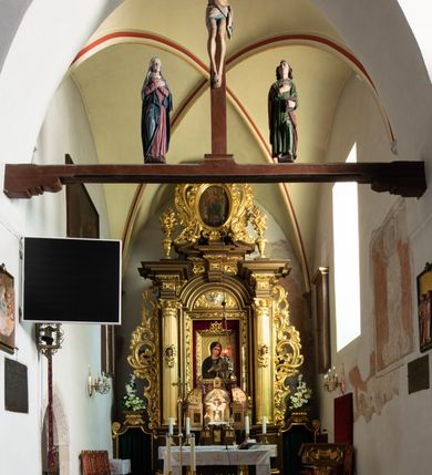 Zdjęcie nr 47: Kościół jest usytuowany w centrum wsi Rudawa, na północ od głównej drogi z Zabierzowa do Chrzanowa. Teren wokół niego jest otoczony wysokim, kamiennym murem z nieregularnych ciosów kamienia, oszkarpowanym, tynkowanym, z wyjątkiem zewnętrznej części muru na zachód od południowej bramki. W murze znajdują się trzy wejścia, od wschodu, południa i zachodu. W części wschodniej muru znajduje się trójosiowa brama wjazdowa, zwieńczona łukiem wklęsło-wypukłym, z trzema przelotami: środkowym wyższym i szerszym, zamkniętym łukiem odcinkowym i bocznymi węższymi i niższymi, zamkniętymi łukiem półkolistym (północne zamurowane). Część środkowa jest flankowana zdwojonymi pilastrami, podtrzymującymi profilowane uskokowe belkowanie z przyczółkiem o profilowanym łuku falistym, zwieńczonym równoramiennym krzyżem. W przyczółku wnęka z figurą św. Floriana. Bramki od strony zachodniej i południowej prostokątne, z przejściem zakończonym płaskim łukiem odcinkowym, z profilowanym gzymsem, zwieńczonym trójkątnym przyczółkiem. Przejścia zamykane drewnianymi ażurowymi i pomalowanymi na ciemnobrązowo jednoskrzydłowymi drzwiami. Poprzez bramkę od zachodu zejście kamiennymi schodami poprowadzonymi wzdłuż muru na dziedziniec plebański, usytuowany poniżej terenu kościelnego. 
W północno-wschodnim narożniku muru niewielka murowana i tynkowana kostnica na planie kwadratu, nakryta dachem namiotowym, łamanym, zakończonym ośmioboczną ślepą latarnią.

Po stronie południowej, poniżej placu kościelnego, do muru przylega murowana, tynkowana, prostokątna i dwukondygnacyjna „zegarowa” wieża bramna nakryta namiotowym dachem z wysoką drewnianą ośmioboczną latarnią o cebulastym hełmie. W wieży znajduje się przejazd wiodący na dziedziniec plebański, z sienią otwartą na przestrzał w dolnej kondygnacji i z lamusem dostępnym od strony placu kościelnego w górnej. 

W południowej części muru, w pobliżu południowo-wschodniego narożnika placu kościelnego, nadbudowana kamienna dzwonnica parawanowa z zawieszonymi czterema dzwonami.  

We wschodniej części placu kościelnego pomiędzy bramką wschodnią a kostnicą znajduje się kamienna ambona, o ośmiobocznej podstawie przechodzącej w szerszy, również ośmioboczny korpus, zakończony kamiennym parapetem, z kamiennymi schodami prowadzącymi na ambonę od strony wschodniej. 

Kościół jest orientowany, prawie w całości zbudowany z cegły, otynkowany z wyjątkiem prezbiterium. Wnętrze kościoła tworzy niewielkie, prostokątne, jednoprzęsłowe prezbiterium zakończone prostą ścianą i nakryte pozornym sklepieniem krzyżowo-żebrowym. Nawa jest szersza, prawie kwadratowa, nakryta drewnianym stropem. Prezbiterium z nawą są połączone szeroką, ostrołukową arkadą w ścianie tęczowej. Od północy do prezbiterium przylega założona na planie prostokąta dwuprzęsłowa zakrystia, nakryta sklepieniem krzyżowym. Wejście do zakrystii zaznaczone gotyckim, kamiennym, sfazowanym portalem zamkniętym łukiem ostrym. Od zachodu do zakrystii przylega niewielkie pomieszczenie gospodarcze, do którego z zakrystii prowadzą ostrołukowe drzwi. Zakrystia oświetlona ostrołukowym oknem w ścianie wschodniej, wypełnionym witrażem z tafelek w kształcie sześciokąta foremnego, ze szkła surowego, tzw. katedralnego. 

Od południa do nawy przylega kaplica o formach renesansowych, dwukondygnacyjna, założona na planie kwadratu. W dolnej kondygnacji sklepiona krzyżowo-żebrowo kruchta otwarta do nawy szeroką, zamkniętą półkoliście arkadą.

Ponad kruchtą kaplica św. Kazimierza, nakryta wspartą na pendentywach kopułą z latarnią. Z kruchty do kaplicy prowadzą kręte kamienne schody umieszczone od zachodu w półkolistej wieżyczce. Prostokątne wejście z krypty na klatkę schodową ujęte kamiennym profilowanym portalem. Kaplica otwarta do nawy szeroką, zamkniętą półkoliście arkadą, o kształcie i wymiarach analogicznych do arkady znajdującej się poniżej. Kaplicę, prócz latarni, oświetla prostokątne okno w ścianie południowej, wypełnione witrażem z tafelek w kształcie gomółek, ze szkła surowego, tzw. katedralnego. Na zachodniej ścianie nawy chór muzyczny, dostępny klatką schodową ukrytą w zewnętrznym aneksie przylegającym do zachodniej elewacji nawy i południowej elewacji wieży-dzwonnicy. 

Nawę i prezbiterium oświetlają umieszczone w południowych ścianach prostokątne, rozglifione okna: jedno w prezbiterium, dwa w nawie. Wszystkie wypełnione witrażami z tafelek w kształcie gomółek, ze szkła surowego, tzw. katedralnego. 

Do kościoła prowadzą dwa wejścia: poprzez arkadę z kruchty południowej oraz szerokie wejście główne prostokątne, zamknięte łukiem odcinkowym, prowadzące do kościoła z obszernej kruchty od strony zachodniej, znajdującej się w murowanym przyziemiu wieży - dzwonnicy. Kruchta, założona na planie kwadratu i nakryta murowanym stropem, doświetlona jest dwoma prostokątnymi oknami umieszczonymi naprzeciw siebie w ścianach północnej i południowej.
 
W zewnętrznej elewacji kościoła widoczny niewysoki kamienny cokół wykonany z nieregularnych ciosów kamienia. Prezbiterium, niższe od nawy, murowane z cegły w układzie wedyjskim, z domieszką układu polskiego. Wschodnie naroża prezbiterium zaakcentowane płaskimi lizenami. We wschodniej ścianie widoczny zarys zamurowanego wydłużonego okna zamkniętego lekko zaostrzonym łukiem, w trójkątnym szczycie znajduje się niewielkie wąskie okienko zakończone łukiem półkolistym. Południowa ściana prezbiterium ozdobiona fryzem z cegieł. Do ściany północnej prezbiterium przylega zakrystia, oszkarpowana, nakryta dachem pulpitowym, z dobudowanym od niej niewielkim aneksem, nakrytym takim samym zadaszeniem. Do wschodniej ściany prezbiterium przylega ogrójec nakryty dachem namiotowym z cebulastym zwieńczeniem, wspartym na sześciu smukłych, profilowanych drewnianych słupach z mieczami, pomiędzy którymi od północy i południa ażurowa drewniana balustrada. 

Nawa oszkarpowana w narożnikach. Elewacje bez podziałów architektonicznych. Od strony południowej do nawy dobudowana dwukondygnacyjna kaplica nakryta kopułą z latarnią, podzielona na dwie kondygnacje. W dolnej kondygnacji od południa wejście do kruchty zaznaczone kamiennym portalem o sfazowanych węgarach i lekko zaostrzonym łuku. Wejście zamykają drewniane dwuskrzydłowe drzwi ozdobione kratownicą z żelaznych listew. Od zachodu do kaplicy przylega półokrągła wieżyczka nakryta daszkiem stożkowym. 

Do zachodniej fasady kościoła dostawiona niska, założona na planie kwadratu trójkondygnacyjna wieża-dzwonnica: w dolnej części murowana, w narożach wzmocniona kamiennymi szkarpami, w górnej drewniana konstrukcji słupowo-ramowej z nadwieszoną izbicą i nakryta dachem półszczytowym. W dolnej, murowanej kondygnacji, na osi kościoła, prostokątne wejście do kruchty zaakcentowane przedsionkiem w kształcie ostrołukowej arkady i czterostopniowymi schodami. Przedsionek nakryty dachem dwuspadowym. Do zachodniej elewacji nawy i południowej elewacji dzwonnicy przylega niewielki, wysoki drewniany aneks, nakryty dachem pulpitowym, mieszczący klatkę schodową prowadzącą na górną kondygnację dzwonnicy i na chór muzyczny w nawie kościoła. Prostokątne wejście w południowej ścianie aneksu, do którego prowadzą pięciostopniowe proste schody. Ponad nimi, na wysokości drugiej kondygnacji dzwonnicy, niewielkie kwadratowe okno. 

Prezbiterium i nawa przykryte stromymi dachami dwuspadowymi, zamkniętymi od wschodu i zachodu szczytami sterczynowymi. Wieżyczka na sygnaturkę ośmioboczna, w dolnej części barokowa, w górnej części nowsza.