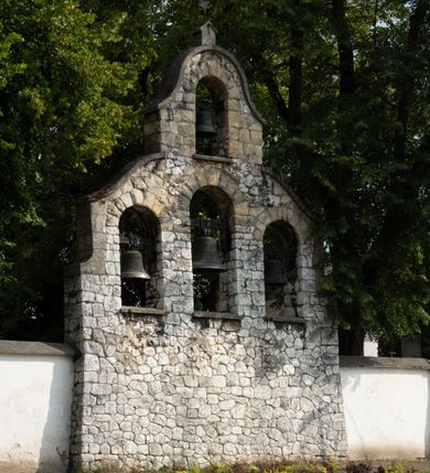 Zdjęcie nr 45: Kościół jest usytuowany w centrum wsi Rudawa, na północ od głównej drogi z Zabierzowa do Chrzanowa. Teren wokół niego jest otoczony wysokim, kamiennym murem z nieregularnych ciosów kamienia, oszkarpowanym, tynkowanym, z wyjątkiem zewnętrznej części muru na zachód od południowej bramki. W murze znajdują się trzy wejścia, od wschodu, południa i zachodu. W części wschodniej muru znajduje się trójosiowa brama wjazdowa, zwieńczona łukiem wklęsło-wypukłym, z trzema przelotami: środkowym wyższym i szerszym, zamkniętym łukiem odcinkowym i bocznymi węższymi i niższymi, zamkniętymi łukiem półkolistym (północne zamurowane). Część środkowa jest flankowana zdwojonymi pilastrami, podtrzymującymi profilowane uskokowe belkowanie z przyczółkiem o profilowanym łuku falistym, zwieńczonym równoramiennym krzyżem. W przyczółku wnęka z figurą św. Floriana. Bramki od strony zachodniej i południowej prostokątne, z przejściem zakończonym płaskim łukiem odcinkowym, z profilowanym gzymsem, zwieńczonym trójkątnym przyczółkiem. Przejścia zamykane drewnianymi ażurowymi i pomalowanymi na ciemnobrązowo jednoskrzydłowymi drzwiami. Poprzez bramkę od zachodu zejście kamiennymi schodami poprowadzonymi wzdłuż muru na dziedziniec plebański, usytuowany poniżej terenu kościelnego. 
W północno-wschodnim narożniku muru niewielka murowana i tynkowana kostnica na planie kwadratu, nakryta dachem namiotowym, łamanym, zakończonym ośmioboczną ślepą latarnią.

Po stronie południowej, poniżej placu kościelnego, do muru przylega murowana, tynkowana, prostokątna i dwukondygnacyjna „zegarowa” wieża bramna nakryta namiotowym dachem z wysoką drewnianą ośmioboczną latarnią o cebulastym hełmie. W wieży znajduje się przejazd wiodący na dziedziniec plebański, z sienią otwartą na przestrzał w dolnej kondygnacji i z lamusem dostępnym od strony placu kościelnego w górnej. 

W południowej części muru, w pobliżu południowo-wschodniego narożnika placu kościelnego, nadbudowana kamienna dzwonnica parawanowa z zawieszonymi czterema dzwonami.  

We wschodniej części placu kościelnego pomiędzy bramką wschodnią a kostnicą znajduje się kamienna ambona, o ośmiobocznej podstawie przechodzącej w szerszy, również ośmioboczny korpus, zakończony kamiennym parapetem, z kamiennymi schodami prowadzącymi na ambonę od strony wschodniej. 

Kościół jest orientowany, prawie w całości zbudowany z cegły, otynkowany z wyjątkiem prezbiterium. Wnętrze kościoła tworzy niewielkie, prostokątne, jednoprzęsłowe prezbiterium zakończone prostą ścianą i nakryte pozornym sklepieniem krzyżowo-żebrowym. Nawa jest szersza, prawie kwadratowa, nakryta drewnianym stropem. Prezbiterium z nawą są połączone szeroką, ostrołukową arkadą w ścianie tęczowej. Od północy do prezbiterium przylega założona na planie prostokąta dwuprzęsłowa zakrystia, nakryta sklepieniem krzyżowym. Wejście do zakrystii zaznaczone gotyckim, kamiennym, sfazowanym portalem zamkniętym łukiem ostrym. Od zachodu do zakrystii przylega niewielkie pomieszczenie gospodarcze, do którego z zakrystii prowadzą ostrołukowe drzwi. Zakrystia oświetlona ostrołukowym oknem w ścianie wschodniej, wypełnionym witrażem z tafelek w kształcie sześciokąta foremnego, ze szkła surowego, tzw. katedralnego. 

Od południa do nawy przylega kaplica o formach renesansowych, dwukondygnacyjna, założona na planie kwadratu. W dolnej kondygnacji sklepiona krzyżowo-żebrowo kruchta otwarta do nawy szeroką, zamkniętą półkoliście arkadą.

Ponad kruchtą kaplica św. Kazimierza, nakryta wspartą na pendentywach kopułą z latarnią. Z kruchty do kaplicy prowadzą kręte kamienne schody umieszczone od zachodu w półkolistej wieżyczce. Prostokątne wejście z krypty na klatkę schodową ujęte kamiennym profilowanym portalem. Kaplica otwarta do nawy szeroką, zamkniętą półkoliście arkadą, o kształcie i wymiarach analogicznych do arkady znajdującej się poniżej. Kaplicę, prócz latarni, oświetla prostokątne okno w ścianie południowej, wypełnione witrażem z tafelek w kształcie gomółek, ze szkła surowego, tzw. katedralnego. Na zachodniej ścianie nawy chór muzyczny, dostępny klatką schodową ukrytą w zewnętrznym aneksie przylegającym do zachodniej elewacji nawy i południowej elewacji wieży-dzwonnicy. 

Nawę i prezbiterium oświetlają umieszczone w południowych ścianach prostokątne, rozglifione okna: jedno w prezbiterium, dwa w nawie. Wszystkie wypełnione witrażami z tafelek w kształcie gomółek, ze szkła surowego, tzw. katedralnego. 

Do kościoła prowadzą dwa wejścia: poprzez arkadę z kruchty południowej oraz szerokie wejście główne prostokątne, zamknięte łukiem odcinkowym, prowadzące do kościoła z obszernej kruchty od strony zachodniej, znajdującej się w murowanym przyziemiu wieży - dzwonnicy. Kruchta, założona na planie kwadratu i nakryta murowanym stropem, doświetlona jest dwoma prostokątnymi oknami umieszczonymi naprzeciw siebie w ścianach północnej i południowej.
 
W zewnętrznej elewacji kościoła widoczny niewysoki kamienny cokół wykonany z nieregularnych ciosów kamienia. Prezbiterium, niższe od nawy, murowane z cegły w układzie wedyjskim, z domieszką układu polskiego. Wschodnie naroża prezbiterium zaakcentowane płaskimi lizenami. We wschodniej ścianie widoczny zarys zamurowanego wydłużonego okna zamkniętego lekko zaostrzonym łukiem, w trójkątnym szczycie znajduje się niewielkie wąskie okienko zakończone łukiem półkolistym. Południowa ściana prezbiterium ozdobiona fryzem z cegieł. Do ściany północnej prezbiterium przylega zakrystia, oszkarpowana, nakryta dachem pulpitowym, z dobudowanym od niej niewielkim aneksem, nakrytym takim samym zadaszeniem. Do wschodniej ściany prezbiterium przylega ogrójec nakryty dachem namiotowym z cebulastym zwieńczeniem, wspartym na sześciu smukłych, profilowanych drewnianych słupach z mieczami, pomiędzy którymi od północy i południa ażurowa drewniana balustrada. 

Nawa oszkarpowana w narożnikach. Elewacje bez podziałów architektonicznych. Od strony południowej do nawy dobudowana dwukondygnacyjna kaplica nakryta kopułą z latarnią, podzielona na dwie kondygnacje. W dolnej kondygnacji od południa wejście do kruchty zaznaczone kamiennym portalem o sfazowanych węgarach i lekko zaostrzonym łuku. Wejście zamykają drewniane dwuskrzydłowe drzwi ozdobione kratownicą z żelaznych listew. Od zachodu do kaplicy przylega półokrągła wieżyczka nakryta daszkiem stożkowym. 

Do zachodniej fasady kościoła dostawiona niska, założona na planie kwadratu trójkondygnacyjna wieża-dzwonnica: w dolnej części murowana, w narożach wzmocniona kamiennymi szkarpami, w górnej drewniana konstrukcji słupowo-ramowej z nadwieszoną izbicą i nakryta dachem półszczytowym. W dolnej, murowanej kondygnacji, na osi kościoła, prostokątne wejście do kruchty zaakcentowane przedsionkiem w kształcie ostrołukowej arkady i czterostopniowymi schodami. Przedsionek nakryty dachem dwuspadowym. Do zachodniej elewacji nawy i południowej elewacji dzwonnicy przylega niewielki, wysoki drewniany aneks, nakryty dachem pulpitowym, mieszczący klatkę schodową prowadzącą na górną kondygnację dzwonnicy i na chór muzyczny w nawie kościoła. Prostokątne wejście w południowej ścianie aneksu, do którego prowadzą pięciostopniowe proste schody. Ponad nimi, na wysokości drugiej kondygnacji dzwonnicy, niewielkie kwadratowe okno. 

Prezbiterium i nawa przykryte stromymi dachami dwuspadowymi, zamkniętymi od wschodu i zachodu szczytami sterczynowymi. Wieżyczka na sygnaturkę ośmioboczna, w dolnej części barokowa, w górnej części nowsza.