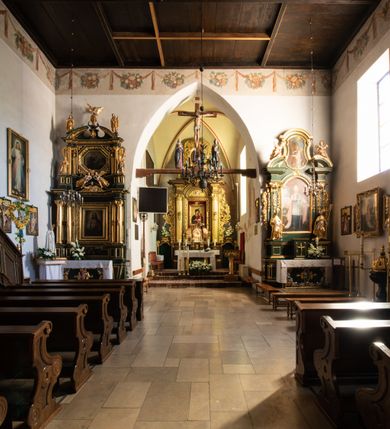 Zdjęcie nr 51: Kościół jest usytuowany w centrum wsi Rudawa, na północ od głównej drogi z Zabierzowa do Chrzanowa. Teren wokół niego jest otoczony wysokim, kamiennym murem z nieregularnych ciosów kamienia, oszkarpowanym, tynkowanym, z wyjątkiem zewnętrznej części muru na zachód od południowej bramki. W murze znajdują się trzy wejścia, od wschodu, południa i zachodu. W części wschodniej muru znajduje się trójosiowa brama wjazdowa, zwieńczona łukiem wklęsło-wypukłym, z trzema przelotami: środkowym wyższym i szerszym, zamkniętym łukiem odcinkowym i bocznymi węższymi i niższymi, zamkniętymi łukiem półkolistym (północne zamurowane). Część środkowa jest flankowana zdwojonymi pilastrami, podtrzymującymi profilowane uskokowe belkowanie z przyczółkiem o profilowanym łuku falistym, zwieńczonym równoramiennym krzyżem. W przyczółku wnęka z figurą św. Floriana. Bramki od strony zachodniej i południowej prostokątne, z przejściem zakończonym płaskim łukiem odcinkowym, z profilowanym gzymsem, zwieńczonym trójkątnym przyczółkiem. Przejścia zamykane drewnianymi ażurowymi i pomalowanymi na ciemnobrązowo jednoskrzydłowymi drzwiami. Poprzez bramkę od zachodu zejście kamiennymi schodami poprowadzonymi wzdłuż muru na dziedziniec plebański, usytuowany poniżej terenu kościelnego. 
W północno-wschodnim narożniku muru niewielka murowana i tynkowana kostnica na planie kwadratu, nakryta dachem namiotowym, łamanym, zakończonym ośmioboczną ślepą latarnią.

Po stronie południowej, poniżej placu kościelnego, do muru przylega murowana, tynkowana, prostokątna i dwukondygnacyjna „zegarowa” wieża bramna nakryta namiotowym dachem z wysoką drewnianą ośmioboczną latarnią o cebulastym hełmie. W wieży znajduje się przejazd wiodący na dziedziniec plebański, z sienią otwartą na przestrzał w dolnej kondygnacji i z lamusem dostępnym od strony placu kościelnego w górnej. 

W południowej części muru, w pobliżu południowo-wschodniego narożnika placu kościelnego, nadbudowana kamienna dzwonnica parawanowa z zawieszonymi czterema dzwonami.  

We wschodniej części placu kościelnego pomiędzy bramką wschodnią a kostnicą znajduje się kamienna ambona, o ośmiobocznej podstawie przechodzącej w szerszy, również ośmioboczny korpus, zakończony kamiennym parapetem, z kamiennymi schodami prowadzącymi na ambonę od strony wschodniej. 

Kościół jest orientowany, prawie w całości zbudowany z cegły, otynkowany z wyjątkiem prezbiterium. Wnętrze kościoła tworzy niewielkie, prostokątne, jednoprzęsłowe prezbiterium zakończone prostą ścianą i nakryte pozornym sklepieniem krzyżowo-żebrowym. Nawa jest szersza, prawie kwadratowa, nakryta drewnianym stropem. Prezbiterium z nawą są połączone szeroką, ostrołukową arkadą w ścianie tęczowej. Od północy do prezbiterium przylega założona na planie prostokąta dwuprzęsłowa zakrystia, nakryta sklepieniem krzyżowym. Wejście do zakrystii zaznaczone gotyckim, kamiennym, sfazowanym portalem zamkniętym łukiem ostrym. Od zachodu do zakrystii przylega niewielkie pomieszczenie gospodarcze, do którego z zakrystii prowadzą ostrołukowe drzwi. Zakrystia oświetlona ostrołukowym oknem w ścianie wschodniej, wypełnionym witrażem z tafelek w kształcie sześciokąta foremnego, ze szkła surowego, tzw. katedralnego. 

Od południa do nawy przylega kaplica o formach renesansowych, dwukondygnacyjna, założona na planie kwadratu. W dolnej kondygnacji sklepiona krzyżowo-żebrowo kruchta otwarta do nawy szeroką, zamkniętą półkoliście arkadą.

Ponad kruchtą kaplica św. Kazimierza, nakryta wspartą na pendentywach kopułą z latarnią. Z kruchty do kaplicy prowadzą kręte kamienne schody umieszczone od zachodu w półkolistej wieżyczce. Prostokątne wejście z krypty na klatkę schodową ujęte kamiennym profilowanym portalem. Kaplica otwarta do nawy szeroką, zamkniętą półkoliście arkadą, o kształcie i wymiarach analogicznych do arkady znajdującej się poniżej. Kaplicę, prócz latarni, oświetla prostokątne okno w ścianie południowej, wypełnione witrażem z tafelek w kształcie gomółek, ze szkła surowego, tzw. katedralnego. Na zachodniej ścianie nawy chór muzyczny, dostępny klatką schodową ukrytą w zewnętrznym aneksie przylegającym do zachodniej elewacji nawy i południowej elewacji wieży-dzwonnicy. 

Nawę i prezbiterium oświetlają umieszczone w południowych ścianach prostokątne, rozglifione okna: jedno w prezbiterium, dwa w nawie. Wszystkie wypełnione witrażami z tafelek w kształcie gomółek, ze szkła surowego, tzw. katedralnego. 

Do kościoła prowadzą dwa wejścia: poprzez arkadę z kruchty południowej oraz szerokie wejście główne prostokątne, zamknięte łukiem odcinkowym, prowadzące do kościoła z obszernej kruchty od strony zachodniej, znajdującej się w murowanym przyziemiu wieży - dzwonnicy. Kruchta, założona na planie kwadratu i nakryta murowanym stropem, doświetlona jest dwoma prostokątnymi oknami umieszczonymi naprzeciw siebie w ścianach północnej i południowej.
 
W zewnętrznej elewacji kościoła widoczny niewysoki kamienny cokół wykonany z nieregularnych ciosów kamienia. Prezbiterium, niższe od nawy, murowane z cegły w układzie wedyjskim, z domieszką układu polskiego. Wschodnie naroża prezbiterium zaakcentowane płaskimi lizenami. We wschodniej ścianie widoczny zarys zamurowanego wydłużonego okna zamkniętego lekko zaostrzonym łukiem, w trójkątnym szczycie znajduje się niewielkie wąskie okienko zakończone łukiem półkolistym. Południowa ściana prezbiterium ozdobiona fryzem z cegieł. Do ściany północnej prezbiterium przylega zakrystia, oszkarpowana, nakryta dachem pulpitowym, z dobudowanym od niej niewielkim aneksem, nakrytym takim samym zadaszeniem. Do wschodniej ściany prezbiterium przylega ogrójec nakryty dachem namiotowym z cebulastym zwieńczeniem, wspartym na sześciu smukłych, profilowanych drewnianych słupach z mieczami, pomiędzy którymi od północy i południa ażurowa drewniana balustrada. 

Nawa oszkarpowana w narożnikach. Elewacje bez podziałów architektonicznych. Od strony południowej do nawy dobudowana dwukondygnacyjna kaplica nakryta kopułą z latarnią, podzielona na dwie kondygnacje. W dolnej kondygnacji od południa wejście do kruchty zaznaczone kamiennym portalem o sfazowanych węgarach i lekko zaostrzonym łuku. Wejście zamykają drewniane dwuskrzydłowe drzwi ozdobione kratownicą z żelaznych listew. Od zachodu do kaplicy przylega półokrągła wieżyczka nakryta daszkiem stożkowym. 

Do zachodniej fasady kościoła dostawiona niska, założona na planie kwadratu trójkondygnacyjna wieża-dzwonnica: w dolnej części murowana, w narożach wzmocniona kamiennymi szkarpami, w górnej drewniana konstrukcji słupowo-ramowej z nadwieszoną izbicą i nakryta dachem półszczytowym. W dolnej, murowanej kondygnacji, na osi kościoła, prostokątne wejście do kruchty zaakcentowane przedsionkiem w kształcie ostrołukowej arkady i czterostopniowymi schodami. Przedsionek nakryty dachem dwuspadowym. Do zachodniej elewacji nawy i południowej elewacji dzwonnicy przylega niewielki, wysoki drewniany aneks, nakryty dachem pulpitowym, mieszczący klatkę schodową prowadzącą na górną kondygnację dzwonnicy i na chór muzyczny w nawie kościoła. Prostokątne wejście w południowej ścianie aneksu, do którego prowadzą pięciostopniowe proste schody. Ponad nimi, na wysokości drugiej kondygnacji dzwonnicy, niewielkie kwadratowe okno. 

Prezbiterium i nawa przykryte stromymi dachami dwuspadowymi, zamkniętymi od wschodu i zachodu szczytami sterczynowymi. Wieżyczka na sygnaturkę ośmioboczna, w dolnej części barokowa, w górnej części nowsza.