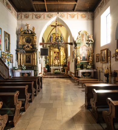 Zdjęcie nr 55: Kościół jest usytuowany w centrum wsi Rudawa, na północ od głównej drogi z Zabierzowa do Chrzanowa. Teren wokół niego jest otoczony wysokim, kamiennym murem z nieregularnych ciosów kamienia, oszkarpowanym, tynkowanym, z wyjątkiem zewnętrznej części muru na zachód od południowej bramki. W murze znajdują się trzy wejścia, od wschodu, południa i zachodu. W części wschodniej muru znajduje się trójosiowa brama wjazdowa, zwieńczona łukiem wklęsło-wypukłym, z trzema przelotami: środkowym wyższym i szerszym, zamkniętym łukiem odcinkowym i bocznymi węższymi i niższymi, zamkniętymi łukiem półkolistym (północne zamurowane). Część środkowa jest flankowana zdwojonymi pilastrami, podtrzymującymi profilowane uskokowe belkowanie z przyczółkiem o profilowanym łuku falistym, zwieńczonym równoramiennym krzyżem. W przyczółku wnęka z figurą św. Floriana. Bramki od strony zachodniej i południowej prostokątne, z przejściem zakończonym płaskim łukiem odcinkowym, z profilowanym gzymsem, zwieńczonym trójkątnym przyczółkiem. Przejścia zamykane drewnianymi ażurowymi i pomalowanymi na ciemnobrązowo jednoskrzydłowymi drzwiami. Poprzez bramkę od zachodu zejście kamiennymi schodami poprowadzonymi wzdłuż muru na dziedziniec plebański, usytuowany poniżej terenu kościelnego. 
W północno-wschodnim narożniku muru niewielka murowana i tynkowana kostnica na planie kwadratu, nakryta dachem namiotowym, łamanym, zakończonym ośmioboczną ślepą latarnią.

Po stronie południowej, poniżej placu kościelnego, do muru przylega murowana, tynkowana, prostokątna i dwukondygnacyjna „zegarowa” wieża bramna nakryta namiotowym dachem z wysoką drewnianą ośmioboczną latarnią o cebulastym hełmie. W wieży znajduje się przejazd wiodący na dziedziniec plebański, z sienią otwartą na przestrzał w dolnej kondygnacji i z lamusem dostępnym od strony placu kościelnego w górnej. 

W południowej części muru, w pobliżu południowo-wschodniego narożnika placu kościelnego, nadbudowana kamienna dzwonnica parawanowa z zawieszonymi czterema dzwonami.  

We wschodniej części placu kościelnego pomiędzy bramką wschodnią a kostnicą znajduje się kamienna ambona, o ośmiobocznej podstawie przechodzącej w szerszy, również ośmioboczny korpus, zakończony kamiennym parapetem, z kamiennymi schodami prowadzącymi na ambonę od strony wschodniej. 

Kościół jest orientowany, prawie w całości zbudowany z cegły, otynkowany z wyjątkiem prezbiterium. Wnętrze kościoła tworzy niewielkie, prostokątne, jednoprzęsłowe prezbiterium zakończone prostą ścianą i nakryte pozornym sklepieniem krzyżowo-żebrowym. Nawa jest szersza, prawie kwadratowa, nakryta drewnianym stropem. Prezbiterium z nawą są połączone szeroką, ostrołukową arkadą w ścianie tęczowej. Od północy do prezbiterium przylega założona na planie prostokąta dwuprzęsłowa zakrystia, nakryta sklepieniem krzyżowym. Wejście do zakrystii zaznaczone gotyckim, kamiennym, sfazowanym portalem zamkniętym łukiem ostrym. Od zachodu do zakrystii przylega niewielkie pomieszczenie gospodarcze, do którego z zakrystii prowadzą ostrołukowe drzwi. Zakrystia oświetlona ostrołukowym oknem w ścianie wschodniej, wypełnionym witrażem z tafelek w kształcie sześciokąta foremnego, ze szkła surowego, tzw. katedralnego. 

Od południa do nawy przylega kaplica o formach renesansowych, dwukondygnacyjna, założona na planie kwadratu. W dolnej kondygnacji sklepiona krzyżowo-żebrowo kruchta otwarta do nawy szeroką, zamkniętą półkoliście arkadą.

Ponad kruchtą kaplica św. Kazimierza, nakryta wspartą na pendentywach kopułą z latarnią. Z kruchty do kaplicy prowadzą kręte kamienne schody umieszczone od zachodu w półkolistej wieżyczce. Prostokątne wejście z krypty na klatkę schodową ujęte kamiennym profilowanym portalem. Kaplica otwarta do nawy szeroką, zamkniętą półkoliście arkadą, o kształcie i wymiarach analogicznych do arkady znajdującej się poniżej. Kaplicę, prócz latarni, oświetla prostokątne okno w ścianie południowej, wypełnione witrażem z tafelek w kształcie gomółek, ze szkła surowego, tzw. katedralnego. Na zachodniej ścianie nawy chór muzyczny, dostępny klatką schodową ukrytą w zewnętrznym aneksie przylegającym do zachodniej elewacji nawy i południowej elewacji wieży-dzwonnicy. 

Nawę i prezbiterium oświetlają umieszczone w południowych ścianach prostokątne, rozglifione okna: jedno w prezbiterium, dwa w nawie. Wszystkie wypełnione witrażami z tafelek w kształcie gomółek, ze szkła surowego, tzw. katedralnego. 

Do kościoła prowadzą dwa wejścia: poprzez arkadę z kruchty południowej oraz szerokie wejście główne prostokątne, zamknięte łukiem odcinkowym, prowadzące do kościoła z obszernej kruchty od strony zachodniej, znajdującej się w murowanym przyziemiu wieży - dzwonnicy. Kruchta, założona na planie kwadratu i nakryta murowanym stropem, doświetlona jest dwoma prostokątnymi oknami umieszczonymi naprzeciw siebie w ścianach północnej i południowej.
 
W zewnętrznej elewacji kościoła widoczny niewysoki kamienny cokół wykonany z nieregularnych ciosów kamienia. Prezbiterium, niższe od nawy, murowane z cegły w układzie wedyjskim, z domieszką układu polskiego. Wschodnie naroża prezbiterium zaakcentowane płaskimi lizenami. We wschodniej ścianie widoczny zarys zamurowanego wydłużonego okna zamkniętego lekko zaostrzonym łukiem, w trójkątnym szczycie znajduje się niewielkie wąskie okienko zakończone łukiem półkolistym. Południowa ściana prezbiterium ozdobiona fryzem z cegieł. Do ściany północnej prezbiterium przylega zakrystia, oszkarpowana, nakryta dachem pulpitowym, z dobudowanym od niej niewielkim aneksem, nakrytym takim samym zadaszeniem. Do wschodniej ściany prezbiterium przylega ogrójec nakryty dachem namiotowym z cebulastym zwieńczeniem, wspartym na sześciu smukłych, profilowanych drewnianych słupach z mieczami, pomiędzy którymi od północy i południa ażurowa drewniana balustrada. 

Nawa oszkarpowana w narożnikach. Elewacje bez podziałów architektonicznych. Od strony południowej do nawy dobudowana dwukondygnacyjna kaplica nakryta kopułą z latarnią, podzielona na dwie kondygnacje. W dolnej kondygnacji od południa wejście do kruchty zaznaczone kamiennym portalem o sfazowanych węgarach i lekko zaostrzonym łuku. Wejście zamykają drewniane dwuskrzydłowe drzwi ozdobione kratownicą z żelaznych listew. Od zachodu do kaplicy przylega półokrągła wieżyczka nakryta daszkiem stożkowym. 

Do zachodniej fasady kościoła dostawiona niska, założona na planie kwadratu trójkondygnacyjna wieża-dzwonnica: w dolnej części murowana, w narożach wzmocniona kamiennymi szkarpami, w górnej drewniana konstrukcji słupowo-ramowej z nadwieszoną izbicą i nakryta dachem półszczytowym. W dolnej, murowanej kondygnacji, na osi kościoła, prostokątne wejście do kruchty zaakcentowane przedsionkiem w kształcie ostrołukowej arkady i czterostopniowymi schodami. Przedsionek nakryty dachem dwuspadowym. Do zachodniej elewacji nawy i południowej elewacji dzwonnicy przylega niewielki, wysoki drewniany aneks, nakryty dachem pulpitowym, mieszczący klatkę schodową prowadzącą na górną kondygnację dzwonnicy i na chór muzyczny w nawie kościoła. Prostokątne wejście w południowej ścianie aneksu, do którego prowadzą pięciostopniowe proste schody. Ponad nimi, na wysokości drugiej kondygnacji dzwonnicy, niewielkie kwadratowe okno. 

Prezbiterium i nawa przykryte stromymi dachami dwuspadowymi, zamkniętymi od wschodu i zachodu szczytami sterczynowymi. Wieżyczka na sygnaturkę ośmioboczna, w dolnej części barokowa, w górnej części nowsza.