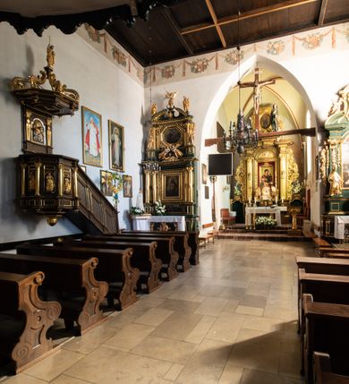 Zdjęcie nr 54: Kościół jest usytuowany w centrum wsi Rudawa, na północ od głównej drogi z Zabierzowa do Chrzanowa. Teren wokół niego jest otoczony wysokim, kamiennym murem z nieregularnych ciosów kamienia, oszkarpowanym, tynkowanym, z wyjątkiem zewnętrznej części muru na zachód od południowej bramki. W murze znajdują się trzy wejścia, od wschodu, południa i zachodu. W części wschodniej muru znajduje się trójosiowa brama wjazdowa, zwieńczona łukiem wklęsło-wypukłym, z trzema przelotami: środkowym wyższym i szerszym, zamkniętym łukiem odcinkowym i bocznymi węższymi i niższymi, zamkniętymi łukiem półkolistym (północne zamurowane). Część środkowa jest flankowana zdwojonymi pilastrami, podtrzymującymi profilowane uskokowe belkowanie z przyczółkiem o profilowanym łuku falistym, zwieńczonym równoramiennym krzyżem. W przyczółku wnęka z figurą św. Floriana. Bramki od strony zachodniej i południowej prostokątne, z przejściem zakończonym płaskim łukiem odcinkowym, z profilowanym gzymsem, zwieńczonym trójkątnym przyczółkiem. Przejścia zamykane drewnianymi ażurowymi i pomalowanymi na ciemnobrązowo jednoskrzydłowymi drzwiami. Poprzez bramkę od zachodu zejście kamiennymi schodami poprowadzonymi wzdłuż muru na dziedziniec plebański, usytuowany poniżej terenu kościelnego. 
W północno-wschodnim narożniku muru niewielka murowana i tynkowana kostnica na planie kwadratu, nakryta dachem namiotowym, łamanym, zakończonym ośmioboczną ślepą latarnią.

Po stronie południowej, poniżej placu kościelnego, do muru przylega murowana, tynkowana, prostokątna i dwukondygnacyjna „zegarowa” wieża bramna nakryta namiotowym dachem z wysoką drewnianą ośmioboczną latarnią o cebulastym hełmie. W wieży znajduje się przejazd wiodący na dziedziniec plebański, z sienią otwartą na przestrzał w dolnej kondygnacji i z lamusem dostępnym od strony placu kościelnego w górnej. 

W południowej części muru, w pobliżu południowo-wschodniego narożnika placu kościelnego, nadbudowana kamienna dzwonnica parawanowa z zawieszonymi czterema dzwonami.  

We wschodniej części placu kościelnego pomiędzy bramką wschodnią a kostnicą znajduje się kamienna ambona, o ośmiobocznej podstawie przechodzącej w szerszy, również ośmioboczny korpus, zakończony kamiennym parapetem, z kamiennymi schodami prowadzącymi na ambonę od strony wschodniej. 

Kościół jest orientowany, prawie w całości zbudowany z cegły, otynkowany z wyjątkiem prezbiterium. Wnętrze kościoła tworzy niewielkie, prostokątne, jednoprzęsłowe prezbiterium zakończone prostą ścianą i nakryte pozornym sklepieniem krzyżowo-żebrowym. Nawa jest szersza, prawie kwadratowa, nakryta drewnianym stropem. Prezbiterium z nawą są połączone szeroką, ostrołukową arkadą w ścianie tęczowej. Od północy do prezbiterium przylega założona na planie prostokąta dwuprzęsłowa zakrystia, nakryta sklepieniem krzyżowym. Wejście do zakrystii zaznaczone gotyckim, kamiennym, sfazowanym portalem zamkniętym łukiem ostrym. Od zachodu do zakrystii przylega niewielkie pomieszczenie gospodarcze, do którego z zakrystii prowadzą ostrołukowe drzwi. Zakrystia oświetlona ostrołukowym oknem w ścianie wschodniej, wypełnionym witrażem z tafelek w kształcie sześciokąta foremnego, ze szkła surowego, tzw. katedralnego. 

Od południa do nawy przylega kaplica o formach renesansowych, dwukondygnacyjna, założona na planie kwadratu. W dolnej kondygnacji sklepiona krzyżowo-żebrowo kruchta otwarta do nawy szeroką, zamkniętą półkoliście arkadą.

Ponad kruchtą kaplica św. Kazimierza, nakryta wspartą na pendentywach kopułą z latarnią. Z kruchty do kaplicy prowadzą kręte kamienne schody umieszczone od zachodu w półkolistej wieżyczce. Prostokątne wejście z krypty na klatkę schodową ujęte kamiennym profilowanym portalem. Kaplica otwarta do nawy szeroką, zamkniętą półkoliście arkadą, o kształcie i wymiarach analogicznych do arkady znajdującej się poniżej. Kaplicę, prócz latarni, oświetla prostokątne okno w ścianie południowej, wypełnione witrażem z tafelek w kształcie gomółek, ze szkła surowego, tzw. katedralnego. Na zachodniej ścianie nawy chór muzyczny, dostępny klatką schodową ukrytą w zewnętrznym aneksie przylegającym do zachodniej elewacji nawy i południowej elewacji wieży-dzwonnicy. 

Nawę i prezbiterium oświetlają umieszczone w południowych ścianach prostokątne, rozglifione okna: jedno w prezbiterium, dwa w nawie. Wszystkie wypełnione witrażami z tafelek w kształcie gomółek, ze szkła surowego, tzw. katedralnego. 

Do kościoła prowadzą dwa wejścia: poprzez arkadę z kruchty południowej oraz szerokie wejście główne prostokątne, zamknięte łukiem odcinkowym, prowadzące do kościoła z obszernej kruchty od strony zachodniej, znajdującej się w murowanym przyziemiu wieży - dzwonnicy. Kruchta, założona na planie kwadratu i nakryta murowanym stropem, doświetlona jest dwoma prostokątnymi oknami umieszczonymi naprzeciw siebie w ścianach północnej i południowej.
 
W zewnętrznej elewacji kościoła widoczny niewysoki kamienny cokół wykonany z nieregularnych ciosów kamienia. Prezbiterium, niższe od nawy, murowane z cegły w układzie wedyjskim, z domieszką układu polskiego. Wschodnie naroża prezbiterium zaakcentowane płaskimi lizenami. We wschodniej ścianie widoczny zarys zamurowanego wydłużonego okna zamkniętego lekko zaostrzonym łukiem, w trójkątnym szczycie znajduje się niewielkie wąskie okienko zakończone łukiem półkolistym. Południowa ściana prezbiterium ozdobiona fryzem z cegieł. Do ściany północnej prezbiterium przylega zakrystia, oszkarpowana, nakryta dachem pulpitowym, z dobudowanym od niej niewielkim aneksem, nakrytym takim samym zadaszeniem. Do wschodniej ściany prezbiterium przylega ogrójec nakryty dachem namiotowym z cebulastym zwieńczeniem, wspartym na sześciu smukłych, profilowanych drewnianych słupach z mieczami, pomiędzy którymi od północy i południa ażurowa drewniana balustrada. 

Nawa oszkarpowana w narożnikach. Elewacje bez podziałów architektonicznych. Od strony południowej do nawy dobudowana dwukondygnacyjna kaplica nakryta kopułą z latarnią, podzielona na dwie kondygnacje. W dolnej kondygnacji od południa wejście do kruchty zaznaczone kamiennym portalem o sfazowanych węgarach i lekko zaostrzonym łuku. Wejście zamykają drewniane dwuskrzydłowe drzwi ozdobione kratownicą z żelaznych listew. Od zachodu do kaplicy przylega półokrągła wieżyczka nakryta daszkiem stożkowym. 

Do zachodniej fasady kościoła dostawiona niska, założona na planie kwadratu trójkondygnacyjna wieża-dzwonnica: w dolnej części murowana, w narożach wzmocniona kamiennymi szkarpami, w górnej drewniana konstrukcji słupowo-ramowej z nadwieszoną izbicą i nakryta dachem półszczytowym. W dolnej, murowanej kondygnacji, na osi kościoła, prostokątne wejście do kruchty zaakcentowane przedsionkiem w kształcie ostrołukowej arkady i czterostopniowymi schodami. Przedsionek nakryty dachem dwuspadowym. Do zachodniej elewacji nawy i południowej elewacji dzwonnicy przylega niewielki, wysoki drewniany aneks, nakryty dachem pulpitowym, mieszczący klatkę schodową prowadzącą na górną kondygnację dzwonnicy i na chór muzyczny w nawie kościoła. Prostokątne wejście w południowej ścianie aneksu, do którego prowadzą pięciostopniowe proste schody. Ponad nimi, na wysokości drugiej kondygnacji dzwonnicy, niewielkie kwadratowe okno. 

Prezbiterium i nawa przykryte stromymi dachami dwuspadowymi, zamkniętymi od wschodu i zachodu szczytami sterczynowymi. Wieżyczka na sygnaturkę ośmioboczna, w dolnej części barokowa, w górnej części nowsza.