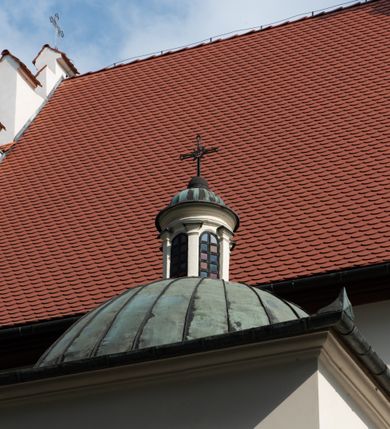 Zdjęcie nr 59: Kościół jest usytuowany w centrum wsi Rudawa, na północ od głównej drogi z Zabierzowa do Chrzanowa. Teren wokół niego jest otoczony wysokim, kamiennym murem z nieregularnych ciosów kamienia, oszkarpowanym, tynkowanym, z wyjątkiem zewnętrznej części muru na zachód od południowej bramki. W murze znajdują się trzy wejścia, od wschodu, południa i zachodu. W części wschodniej muru znajduje się trójosiowa brama wjazdowa, zwieńczona łukiem wklęsło-wypukłym, z trzema przelotami: środkowym wyższym i szerszym, zamkniętym łukiem odcinkowym i bocznymi węższymi i niższymi, zamkniętymi łukiem półkolistym (północne zamurowane). Część środkowa jest flankowana zdwojonymi pilastrami, podtrzymującymi profilowane uskokowe belkowanie z przyczółkiem o profilowanym łuku falistym, zwieńczonym równoramiennym krzyżem. W przyczółku wnęka z figurą św. Floriana. Bramki od strony zachodniej i południowej prostokątne, z przejściem zakończonym płaskim łukiem odcinkowym, z profilowanym gzymsem, zwieńczonym trójkątnym przyczółkiem. Przejścia zamykane drewnianymi ażurowymi i pomalowanymi na ciemnobrązowo jednoskrzydłowymi drzwiami. Poprzez bramkę od zachodu zejście kamiennymi schodami poprowadzonymi wzdłuż muru na dziedziniec plebański, usytuowany poniżej terenu kościelnego. 
W północno-wschodnim narożniku muru niewielka murowana i tynkowana kostnica na planie kwadratu, nakryta dachem namiotowym, łamanym, zakończonym ośmioboczną ślepą latarnią.

Po stronie południowej, poniżej placu kościelnego, do muru przylega murowana, tynkowana, prostokątna i dwukondygnacyjna „zegarowa” wieża bramna nakryta namiotowym dachem z wysoką drewnianą ośmioboczną latarnią o cebulastym hełmie. W wieży znajduje się przejazd wiodący na dziedziniec plebański, z sienią otwartą na przestrzał w dolnej kondygnacji i z lamusem dostępnym od strony placu kościelnego w górnej. 

W południowej części muru, w pobliżu południowo-wschodniego narożnika placu kościelnego, nadbudowana kamienna dzwonnica parawanowa z zawieszonymi czterema dzwonami.  

We wschodniej części placu kościelnego pomiędzy bramką wschodnią a kostnicą znajduje się kamienna ambona, o ośmiobocznej podstawie przechodzącej w szerszy, również ośmioboczny korpus, zakończony kamiennym parapetem, z kamiennymi schodami prowadzącymi na ambonę od strony wschodniej. 

Kościół jest orientowany, prawie w całości zbudowany z cegły, otynkowany z wyjątkiem prezbiterium. Wnętrze kościoła tworzy niewielkie, prostokątne, jednoprzęsłowe prezbiterium zakończone prostą ścianą i nakryte pozornym sklepieniem krzyżowo-żebrowym. Nawa jest szersza, prawie kwadratowa, nakryta drewnianym stropem. Prezbiterium z nawą są połączone szeroką, ostrołukową arkadą w ścianie tęczowej. Od północy do prezbiterium przylega założona na planie prostokąta dwuprzęsłowa zakrystia, nakryta sklepieniem krzyżowym. Wejście do zakrystii zaznaczone gotyckim, kamiennym, sfazowanym portalem zamkniętym łukiem ostrym. Od zachodu do zakrystii przylega niewielkie pomieszczenie gospodarcze, do którego z zakrystii prowadzą ostrołukowe drzwi. Zakrystia oświetlona ostrołukowym oknem w ścianie wschodniej, wypełnionym witrażem z tafelek w kształcie sześciokąta foremnego, ze szkła surowego, tzw. katedralnego. 

Od południa do nawy przylega kaplica o formach renesansowych, dwukondygnacyjna, założona na planie kwadratu. W dolnej kondygnacji sklepiona krzyżowo-żebrowo kruchta otwarta do nawy szeroką, zamkniętą półkoliście arkadą.

Ponad kruchtą kaplica św. Kazimierza, nakryta wspartą na pendentywach kopułą z latarnią. Z kruchty do kaplicy prowadzą kręte kamienne schody umieszczone od zachodu w półkolistej wieżyczce. Prostokątne wejście z krypty na klatkę schodową ujęte kamiennym profilowanym portalem. Kaplica otwarta do nawy szeroką, zamkniętą półkoliście arkadą, o kształcie i wymiarach analogicznych do arkady znajdującej się poniżej. Kaplicę, prócz latarni, oświetla prostokątne okno w ścianie południowej, wypełnione witrażem z tafelek w kształcie gomółek, ze szkła surowego, tzw. katedralnego. Na zachodniej ścianie nawy chór muzyczny, dostępny klatką schodową ukrytą w zewnętrznym aneksie przylegającym do zachodniej elewacji nawy i południowej elewacji wieży-dzwonnicy. 

Nawę i prezbiterium oświetlają umieszczone w południowych ścianach prostokątne, rozglifione okna: jedno w prezbiterium, dwa w nawie. Wszystkie wypełnione witrażami z tafelek w kształcie gomółek, ze szkła surowego, tzw. katedralnego. 

Do kościoła prowadzą dwa wejścia: poprzez arkadę z kruchty południowej oraz szerokie wejście główne prostokątne, zamknięte łukiem odcinkowym, prowadzące do kościoła z obszernej kruchty od strony zachodniej, znajdującej się w murowanym przyziemiu wieży - dzwonnicy. Kruchta, założona na planie kwadratu i nakryta murowanym stropem, doświetlona jest dwoma prostokątnymi oknami umieszczonymi naprzeciw siebie w ścianach północnej i południowej.
 
W zewnętrznej elewacji kościoła widoczny niewysoki kamienny cokół wykonany z nieregularnych ciosów kamienia. Prezbiterium, niższe od nawy, murowane z cegły w układzie wedyjskim, z domieszką układu polskiego. Wschodnie naroża prezbiterium zaakcentowane płaskimi lizenami. We wschodniej ścianie widoczny zarys zamurowanego wydłużonego okna zamkniętego lekko zaostrzonym łukiem, w trójkątnym szczycie znajduje się niewielkie wąskie okienko zakończone łukiem półkolistym. Południowa ściana prezbiterium ozdobiona fryzem z cegieł. Do ściany północnej prezbiterium przylega zakrystia, oszkarpowana, nakryta dachem pulpitowym, z dobudowanym od niej niewielkim aneksem, nakrytym takim samym zadaszeniem. Do wschodniej ściany prezbiterium przylega ogrójec nakryty dachem namiotowym z cebulastym zwieńczeniem, wspartym na sześciu smukłych, profilowanych drewnianych słupach z mieczami, pomiędzy którymi od północy i południa ażurowa drewniana balustrada. 

Nawa oszkarpowana w narożnikach. Elewacje bez podziałów architektonicznych. Od strony południowej do nawy dobudowana dwukondygnacyjna kaplica nakryta kopułą z latarnią, podzielona na dwie kondygnacje. W dolnej kondygnacji od południa wejście do kruchty zaznaczone kamiennym portalem o sfazowanych węgarach i lekko zaostrzonym łuku. Wejście zamykają drewniane dwuskrzydłowe drzwi ozdobione kratownicą z żelaznych listew. Od zachodu do kaplicy przylega półokrągła wieżyczka nakryta daszkiem stożkowym. 

Do zachodniej fasady kościoła dostawiona niska, założona na planie kwadratu trójkondygnacyjna wieża-dzwonnica: w dolnej części murowana, w narożach wzmocniona kamiennymi szkarpami, w górnej drewniana konstrukcji słupowo-ramowej z nadwieszoną izbicą i nakryta dachem półszczytowym. W dolnej, murowanej kondygnacji, na osi kościoła, prostokątne wejście do kruchty zaakcentowane przedsionkiem w kształcie ostrołukowej arkady i czterostopniowymi schodami. Przedsionek nakryty dachem dwuspadowym. Do zachodniej elewacji nawy i południowej elewacji dzwonnicy przylega niewielki, wysoki drewniany aneks, nakryty dachem pulpitowym, mieszczący klatkę schodową prowadzącą na górną kondygnację dzwonnicy i na chór muzyczny w nawie kościoła. Prostokątne wejście w południowej ścianie aneksu, do którego prowadzą pięciostopniowe proste schody. Ponad nimi, na wysokości drugiej kondygnacji dzwonnicy, niewielkie kwadratowe okno. 

Prezbiterium i nawa przykryte stromymi dachami dwuspadowymi, zamkniętymi od wschodu i zachodu szczytami sterczynowymi. Wieżyczka na sygnaturkę ośmioboczna, w dolnej części barokowa, w górnej części nowsza.