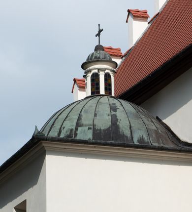 Zdjęcie nr 61: Kościół jest usytuowany w centrum wsi Rudawa, na północ od głównej drogi z Zabierzowa do Chrzanowa. Teren wokół niego jest otoczony wysokim, kamiennym murem z nieregularnych ciosów kamienia, oszkarpowanym, tynkowanym, z wyjątkiem zewnętrznej części muru na zachód od południowej bramki. W murze znajdują się trzy wejścia, od wschodu, południa i zachodu. W części wschodniej muru znajduje się trójosiowa brama wjazdowa, zwieńczona łukiem wklęsło-wypukłym, z trzema przelotami: środkowym wyższym i szerszym, zamkniętym łukiem odcinkowym i bocznymi węższymi i niższymi, zamkniętymi łukiem półkolistym (północne zamurowane). Część środkowa jest flankowana zdwojonymi pilastrami, podtrzymującymi profilowane uskokowe belkowanie z przyczółkiem o profilowanym łuku falistym, zwieńczonym równoramiennym krzyżem. W przyczółku wnęka z figurą św. Floriana. Bramki od strony zachodniej i południowej prostokątne, z przejściem zakończonym płaskim łukiem odcinkowym, z profilowanym gzymsem, zwieńczonym trójkątnym przyczółkiem. Przejścia zamykane drewnianymi ażurowymi i pomalowanymi na ciemnobrązowo jednoskrzydłowymi drzwiami. Poprzez bramkę od zachodu zejście kamiennymi schodami poprowadzonymi wzdłuż muru na dziedziniec plebański, usytuowany poniżej terenu kościelnego. 
W północno-wschodnim narożniku muru niewielka murowana i tynkowana kostnica na planie kwadratu, nakryta dachem namiotowym, łamanym, zakończonym ośmioboczną ślepą latarnią.

Po stronie południowej, poniżej placu kościelnego, do muru przylega murowana, tynkowana, prostokątna i dwukondygnacyjna „zegarowa” wieża bramna nakryta namiotowym dachem z wysoką drewnianą ośmioboczną latarnią o cebulastym hełmie. W wieży znajduje się przejazd wiodący na dziedziniec plebański, z sienią otwartą na przestrzał w dolnej kondygnacji i z lamusem dostępnym od strony placu kościelnego w górnej. 

W południowej części muru, w pobliżu południowo-wschodniego narożnika placu kościelnego, nadbudowana kamienna dzwonnica parawanowa z zawieszonymi czterema dzwonami.  

We wschodniej części placu kościelnego pomiędzy bramką wschodnią a kostnicą znajduje się kamienna ambona, o ośmiobocznej podstawie przechodzącej w szerszy, również ośmioboczny korpus, zakończony kamiennym parapetem, z kamiennymi schodami prowadzącymi na ambonę od strony wschodniej. 

Kościół jest orientowany, prawie w całości zbudowany z cegły, otynkowany z wyjątkiem prezbiterium. Wnętrze kościoła tworzy niewielkie, prostokątne, jednoprzęsłowe prezbiterium zakończone prostą ścianą i nakryte pozornym sklepieniem krzyżowo-żebrowym. Nawa jest szersza, prawie kwadratowa, nakryta drewnianym stropem. Prezbiterium z nawą są połączone szeroką, ostrołukową arkadą w ścianie tęczowej. Od północy do prezbiterium przylega założona na planie prostokąta dwuprzęsłowa zakrystia, nakryta sklepieniem krzyżowym. Wejście do zakrystii zaznaczone gotyckim, kamiennym, sfazowanym portalem zamkniętym łukiem ostrym. Od zachodu do zakrystii przylega niewielkie pomieszczenie gospodarcze, do którego z zakrystii prowadzą ostrołukowe drzwi. Zakrystia oświetlona ostrołukowym oknem w ścianie wschodniej, wypełnionym witrażem z tafelek w kształcie sześciokąta foremnego, ze szkła surowego, tzw. katedralnego. 

Od południa do nawy przylega kaplica o formach renesansowych, dwukondygnacyjna, założona na planie kwadratu. W dolnej kondygnacji sklepiona krzyżowo-żebrowo kruchta otwarta do nawy szeroką, zamkniętą półkoliście arkadą.

Ponad kruchtą kaplica św. Kazimierza, nakryta wspartą na pendentywach kopułą z latarnią. Z kruchty do kaplicy prowadzą kręte kamienne schody umieszczone od zachodu w półkolistej wieżyczce. Prostokątne wejście z krypty na klatkę schodową ujęte kamiennym profilowanym portalem. Kaplica otwarta do nawy szeroką, zamkniętą półkoliście arkadą, o kształcie i wymiarach analogicznych do arkady znajdującej się poniżej. Kaplicę, prócz latarni, oświetla prostokątne okno w ścianie południowej, wypełnione witrażem z tafelek w kształcie gomółek, ze szkła surowego, tzw. katedralnego. Na zachodniej ścianie nawy chór muzyczny, dostępny klatką schodową ukrytą w zewnętrznym aneksie przylegającym do zachodniej elewacji nawy i południowej elewacji wieży-dzwonnicy. 

Nawę i prezbiterium oświetlają umieszczone w południowych ścianach prostokątne, rozglifione okna: jedno w prezbiterium, dwa w nawie. Wszystkie wypełnione witrażami z tafelek w kształcie gomółek, ze szkła surowego, tzw. katedralnego. 

Do kościoła prowadzą dwa wejścia: poprzez arkadę z kruchty południowej oraz szerokie wejście główne prostokątne, zamknięte łukiem odcinkowym, prowadzące do kościoła z obszernej kruchty od strony zachodniej, znajdującej się w murowanym przyziemiu wieży - dzwonnicy. Kruchta, założona na planie kwadratu i nakryta murowanym stropem, doświetlona jest dwoma prostokątnymi oknami umieszczonymi naprzeciw siebie w ścianach północnej i południowej.
 
W zewnętrznej elewacji kościoła widoczny niewysoki kamienny cokół wykonany z nieregularnych ciosów kamienia. Prezbiterium, niższe od nawy, murowane z cegły w układzie wedyjskim, z domieszką układu polskiego. Wschodnie naroża prezbiterium zaakcentowane płaskimi lizenami. We wschodniej ścianie widoczny zarys zamurowanego wydłużonego okna zamkniętego lekko zaostrzonym łukiem, w trójkątnym szczycie znajduje się niewielkie wąskie okienko zakończone łukiem półkolistym. Południowa ściana prezbiterium ozdobiona fryzem z cegieł. Do ściany północnej prezbiterium przylega zakrystia, oszkarpowana, nakryta dachem pulpitowym, z dobudowanym od niej niewielkim aneksem, nakrytym takim samym zadaszeniem. Do wschodniej ściany prezbiterium przylega ogrójec nakryty dachem namiotowym z cebulastym zwieńczeniem, wspartym na sześciu smukłych, profilowanych drewnianych słupach z mieczami, pomiędzy którymi od północy i południa ażurowa drewniana balustrada. 

Nawa oszkarpowana w narożnikach. Elewacje bez podziałów architektonicznych. Od strony południowej do nawy dobudowana dwukondygnacyjna kaplica nakryta kopułą z latarnią, podzielona na dwie kondygnacje. W dolnej kondygnacji od południa wejście do kruchty zaznaczone kamiennym portalem o sfazowanych węgarach i lekko zaostrzonym łuku. Wejście zamykają drewniane dwuskrzydłowe drzwi ozdobione kratownicą z żelaznych listew. Od zachodu do kaplicy przylega półokrągła wieżyczka nakryta daszkiem stożkowym. 

Do zachodniej fasady kościoła dostawiona niska, założona na planie kwadratu trójkondygnacyjna wieża-dzwonnica: w dolnej części murowana, w narożach wzmocniona kamiennymi szkarpami, w górnej drewniana konstrukcji słupowo-ramowej z nadwieszoną izbicą i nakryta dachem półszczytowym. W dolnej, murowanej kondygnacji, na osi kościoła, prostokątne wejście do kruchty zaakcentowane przedsionkiem w kształcie ostrołukowej arkady i czterostopniowymi schodami. Przedsionek nakryty dachem dwuspadowym. Do zachodniej elewacji nawy i południowej elewacji dzwonnicy przylega niewielki, wysoki drewniany aneks, nakryty dachem pulpitowym, mieszczący klatkę schodową prowadzącą na górną kondygnację dzwonnicy i na chór muzyczny w nawie kościoła. Prostokątne wejście w południowej ścianie aneksu, do którego prowadzą pięciostopniowe proste schody. Ponad nimi, na wysokości drugiej kondygnacji dzwonnicy, niewielkie kwadratowe okno. 

Prezbiterium i nawa przykryte stromymi dachami dwuspadowymi, zamkniętymi od wschodu i zachodu szczytami sterczynowymi. Wieżyczka na sygnaturkę ośmioboczna, w dolnej części barokowa, w górnej części nowsza.