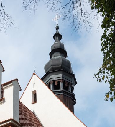 Zdjęcie nr 66: Kościół jest usytuowany w centrum wsi Rudawa, na północ od głównej drogi z Zabierzowa do Chrzanowa. Teren wokół niego jest otoczony wysokim, kamiennym murem z nieregularnych ciosów kamienia, oszkarpowanym, tynkowanym, z wyjątkiem zewnętrznej części muru na zachód od południowej bramki. W murze znajdują się trzy wejścia, od wschodu, południa i zachodu. W części wschodniej muru znajduje się trójosiowa brama wjazdowa, zwieńczona łukiem wklęsło-wypukłym, z trzema przelotami: środkowym wyższym i szerszym, zamkniętym łukiem odcinkowym i bocznymi węższymi i niższymi, zamkniętymi łukiem półkolistym (północne zamurowane). Część środkowa jest flankowana zdwojonymi pilastrami, podtrzymującymi profilowane uskokowe belkowanie z przyczółkiem o profilowanym łuku falistym, zwieńczonym równoramiennym krzyżem. W przyczółku wnęka z figurą św. Floriana. Bramki od strony zachodniej i południowej prostokątne, z przejściem zakończonym płaskim łukiem odcinkowym, z profilowanym gzymsem, zwieńczonym trójkątnym przyczółkiem. Przejścia zamykane drewnianymi ażurowymi i pomalowanymi na ciemnobrązowo jednoskrzydłowymi drzwiami. Poprzez bramkę od zachodu zejście kamiennymi schodami poprowadzonymi wzdłuż muru na dziedziniec plebański, usytuowany poniżej terenu kościelnego. 
W północno-wschodnim narożniku muru niewielka murowana i tynkowana kostnica na planie kwadratu, nakryta dachem namiotowym, łamanym, zakończonym ośmioboczną ślepą latarnią.

Po stronie południowej, poniżej placu kościelnego, do muru przylega murowana, tynkowana, prostokątna i dwukondygnacyjna „zegarowa” wieża bramna nakryta namiotowym dachem z wysoką drewnianą ośmioboczną latarnią o cebulastym hełmie. W wieży znajduje się przejazd wiodący na dziedziniec plebański, z sienią otwartą na przestrzał w dolnej kondygnacji i z lamusem dostępnym od strony placu kościelnego w górnej. 

W południowej części muru, w pobliżu południowo-wschodniego narożnika placu kościelnego, nadbudowana kamienna dzwonnica parawanowa z zawieszonymi czterema dzwonami.  

We wschodniej części placu kościelnego pomiędzy bramką wschodnią a kostnicą znajduje się kamienna ambona, o ośmiobocznej podstawie przechodzącej w szerszy, również ośmioboczny korpus, zakończony kamiennym parapetem, z kamiennymi schodami prowadzącymi na ambonę od strony wschodniej. 

Kościół jest orientowany, prawie w całości zbudowany z cegły, otynkowany z wyjątkiem prezbiterium. Wnętrze kościoła tworzy niewielkie, prostokątne, jednoprzęsłowe prezbiterium zakończone prostą ścianą i nakryte pozornym sklepieniem krzyżowo-żebrowym. Nawa jest szersza, prawie kwadratowa, nakryta drewnianym stropem. Prezbiterium z nawą są połączone szeroką, ostrołukową arkadą w ścianie tęczowej. Od północy do prezbiterium przylega założona na planie prostokąta dwuprzęsłowa zakrystia, nakryta sklepieniem krzyżowym. Wejście do zakrystii zaznaczone gotyckim, kamiennym, sfazowanym portalem zamkniętym łukiem ostrym. Od zachodu do zakrystii przylega niewielkie pomieszczenie gospodarcze, do którego z zakrystii prowadzą ostrołukowe drzwi. Zakrystia oświetlona ostrołukowym oknem w ścianie wschodniej, wypełnionym witrażem z tafelek w kształcie sześciokąta foremnego, ze szkła surowego, tzw. katedralnego. 

Od południa do nawy przylega kaplica o formach renesansowych, dwukondygnacyjna, założona na planie kwadratu. W dolnej kondygnacji sklepiona krzyżowo-żebrowo kruchta otwarta do nawy szeroką, zamkniętą półkoliście arkadą.

Ponad kruchtą kaplica św. Kazimierza, nakryta wspartą na pendentywach kopułą z latarnią. Z kruchty do kaplicy prowadzą kręte kamienne schody umieszczone od zachodu w półkolistej wieżyczce. Prostokątne wejście z krypty na klatkę schodową ujęte kamiennym profilowanym portalem. Kaplica otwarta do nawy szeroką, zamkniętą półkoliście arkadą, o kształcie i wymiarach analogicznych do arkady znajdującej się poniżej. Kaplicę, prócz latarni, oświetla prostokątne okno w ścianie południowej, wypełnione witrażem z tafelek w kształcie gomółek, ze szkła surowego, tzw. katedralnego. Na zachodniej ścianie nawy chór muzyczny, dostępny klatką schodową ukrytą w zewnętrznym aneksie przylegającym do zachodniej elewacji nawy i południowej elewacji wieży-dzwonnicy. 

Nawę i prezbiterium oświetlają umieszczone w południowych ścianach prostokątne, rozglifione okna: jedno w prezbiterium, dwa w nawie. Wszystkie wypełnione witrażami z tafelek w kształcie gomółek, ze szkła surowego, tzw. katedralnego. 

Do kościoła prowadzą dwa wejścia: poprzez arkadę z kruchty południowej oraz szerokie wejście główne prostokątne, zamknięte łukiem odcinkowym, prowadzące do kościoła z obszernej kruchty od strony zachodniej, znajdującej się w murowanym przyziemiu wieży - dzwonnicy. Kruchta, założona na planie kwadratu i nakryta murowanym stropem, doświetlona jest dwoma prostokątnymi oknami umieszczonymi naprzeciw siebie w ścianach północnej i południowej.
 
W zewnętrznej elewacji kościoła widoczny niewysoki kamienny cokół wykonany z nieregularnych ciosów kamienia. Prezbiterium, niższe od nawy, murowane z cegły w układzie wedyjskim, z domieszką układu polskiego. Wschodnie naroża prezbiterium zaakcentowane płaskimi lizenami. We wschodniej ścianie widoczny zarys zamurowanego wydłużonego okna zamkniętego lekko zaostrzonym łukiem, w trójkątnym szczycie znajduje się niewielkie wąskie okienko zakończone łukiem półkolistym. Południowa ściana prezbiterium ozdobiona fryzem z cegieł. Do ściany północnej prezbiterium przylega zakrystia, oszkarpowana, nakryta dachem pulpitowym, z dobudowanym od niej niewielkim aneksem, nakrytym takim samym zadaszeniem. Do wschodniej ściany prezbiterium przylega ogrójec nakryty dachem namiotowym z cebulastym zwieńczeniem, wspartym na sześciu smukłych, profilowanych drewnianych słupach z mieczami, pomiędzy którymi od północy i południa ażurowa drewniana balustrada. 

Nawa oszkarpowana w narożnikach. Elewacje bez podziałów architektonicznych. Od strony południowej do nawy dobudowana dwukondygnacyjna kaplica nakryta kopułą z latarnią, podzielona na dwie kondygnacje. W dolnej kondygnacji od południa wejście do kruchty zaznaczone kamiennym portalem o sfazowanych węgarach i lekko zaostrzonym łuku. Wejście zamykają drewniane dwuskrzydłowe drzwi ozdobione kratownicą z żelaznych listew. Od zachodu do kaplicy przylega półokrągła wieżyczka nakryta daszkiem stożkowym. 

Do zachodniej fasady kościoła dostawiona niska, założona na planie kwadratu trójkondygnacyjna wieża-dzwonnica: w dolnej części murowana, w narożach wzmocniona kamiennymi szkarpami, w górnej drewniana konstrukcji słupowo-ramowej z nadwieszoną izbicą i nakryta dachem półszczytowym. W dolnej, murowanej kondygnacji, na osi kościoła, prostokątne wejście do kruchty zaakcentowane przedsionkiem w kształcie ostrołukowej arkady i czterostopniowymi schodami. Przedsionek nakryty dachem dwuspadowym. Do zachodniej elewacji nawy i południowej elewacji dzwonnicy przylega niewielki, wysoki drewniany aneks, nakryty dachem pulpitowym, mieszczący klatkę schodową prowadzącą na górną kondygnację dzwonnicy i na chór muzyczny w nawie kościoła. Prostokątne wejście w południowej ścianie aneksu, do którego prowadzą pięciostopniowe proste schody. Ponad nimi, na wysokości drugiej kondygnacji dzwonnicy, niewielkie kwadratowe okno. 

Prezbiterium i nawa przykryte stromymi dachami dwuspadowymi, zamkniętymi od wschodu i zachodu szczytami sterczynowymi. Wieżyczka na sygnaturkę ośmioboczna, w dolnej części barokowa, w górnej części nowsza.