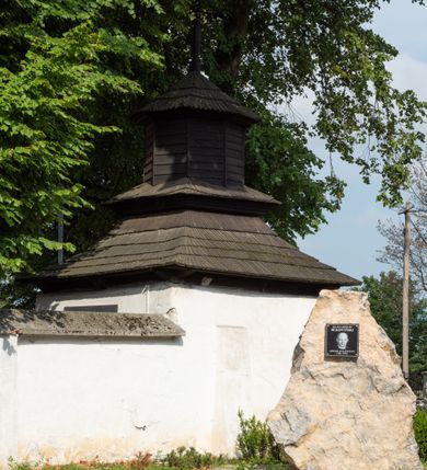 Zdjęcie nr 68: Kościół jest usytuowany w centrum wsi Rudawa, na północ od głównej drogi z Zabierzowa do Chrzanowa. Teren wokół niego jest otoczony wysokim, kamiennym murem z nieregularnych ciosów kamienia, oszkarpowanym, tynkowanym, z wyjątkiem zewnętrznej części muru na zachód od południowej bramki. W murze znajdują się trzy wejścia, od wschodu, południa i zachodu. W części wschodniej muru znajduje się trójosiowa brama wjazdowa, zwieńczona łukiem wklęsło-wypukłym, z trzema przelotami: środkowym wyższym i szerszym, zamkniętym łukiem odcinkowym i bocznymi węższymi i niższymi, zamkniętymi łukiem półkolistym (północne zamurowane). Część środkowa jest flankowana zdwojonymi pilastrami, podtrzymującymi profilowane uskokowe belkowanie z przyczółkiem o profilowanym łuku falistym, zwieńczonym równoramiennym krzyżem. W przyczółku wnęka z figurą św. Floriana. Bramki od strony zachodniej i południowej prostokątne, z przejściem zakończonym płaskim łukiem odcinkowym, z profilowanym gzymsem, zwieńczonym trójkątnym przyczółkiem. Przejścia zamykane drewnianymi ażurowymi i pomalowanymi na ciemnobrązowo jednoskrzydłowymi drzwiami. Poprzez bramkę od zachodu zejście kamiennymi schodami poprowadzonymi wzdłuż muru na dziedziniec plebański, usytuowany poniżej terenu kościelnego. 
W północno-wschodnim narożniku muru niewielka murowana i tynkowana kostnica na planie kwadratu, nakryta dachem namiotowym, łamanym, zakończonym ośmioboczną ślepą latarnią.

Po stronie południowej, poniżej placu kościelnego, do muru przylega murowana, tynkowana, prostokątna i dwukondygnacyjna „zegarowa” wieża bramna nakryta namiotowym dachem z wysoką drewnianą ośmioboczną latarnią o cebulastym hełmie. W wieży znajduje się przejazd wiodący na dziedziniec plebański, z sienią otwartą na przestrzał w dolnej kondygnacji i z lamusem dostępnym od strony placu kościelnego w górnej. 

W południowej części muru, w pobliżu południowo-wschodniego narożnika placu kościelnego, nadbudowana kamienna dzwonnica parawanowa z zawieszonymi czterema dzwonami.  

We wschodniej części placu kościelnego pomiędzy bramką wschodnią a kostnicą znajduje się kamienna ambona, o ośmiobocznej podstawie przechodzącej w szerszy, również ośmioboczny korpus, zakończony kamiennym parapetem, z kamiennymi schodami prowadzącymi na ambonę od strony wschodniej. 

Kościół jest orientowany, prawie w całości zbudowany z cegły, otynkowany z wyjątkiem prezbiterium. Wnętrze kościoła tworzy niewielkie, prostokątne, jednoprzęsłowe prezbiterium zakończone prostą ścianą i nakryte pozornym sklepieniem krzyżowo-żebrowym. Nawa jest szersza, prawie kwadratowa, nakryta drewnianym stropem. Prezbiterium z nawą są połączone szeroką, ostrołukową arkadą w ścianie tęczowej. Od północy do prezbiterium przylega założona na planie prostokąta dwuprzęsłowa zakrystia, nakryta sklepieniem krzyżowym. Wejście do zakrystii zaznaczone gotyckim, kamiennym, sfazowanym portalem zamkniętym łukiem ostrym. Od zachodu do zakrystii przylega niewielkie pomieszczenie gospodarcze, do którego z zakrystii prowadzą ostrołukowe drzwi. Zakrystia oświetlona ostrołukowym oknem w ścianie wschodniej, wypełnionym witrażem z tafelek w kształcie sześciokąta foremnego, ze szkła surowego, tzw. katedralnego. 

Od południa do nawy przylega kaplica o formach renesansowych, dwukondygnacyjna, założona na planie kwadratu. W dolnej kondygnacji sklepiona krzyżowo-żebrowo kruchta otwarta do nawy szeroką, zamkniętą półkoliście arkadą.

Ponad kruchtą kaplica św. Kazimierza, nakryta wspartą na pendentywach kopułą z latarnią. Z kruchty do kaplicy prowadzą kręte kamienne schody umieszczone od zachodu w półkolistej wieżyczce. Prostokątne wejście z krypty na klatkę schodową ujęte kamiennym profilowanym portalem. Kaplica otwarta do nawy szeroką, zamkniętą półkoliście arkadą, o kształcie i wymiarach analogicznych do arkady znajdującej się poniżej. Kaplicę, prócz latarni, oświetla prostokątne okno w ścianie południowej, wypełnione witrażem z tafelek w kształcie gomółek, ze szkła surowego, tzw. katedralnego. Na zachodniej ścianie nawy chór muzyczny, dostępny klatką schodową ukrytą w zewnętrznym aneksie przylegającym do zachodniej elewacji nawy i południowej elewacji wieży-dzwonnicy. 

Nawę i prezbiterium oświetlają umieszczone w południowych ścianach prostokątne, rozglifione okna: jedno w prezbiterium, dwa w nawie. Wszystkie wypełnione witrażami z tafelek w kształcie gomółek, ze szkła surowego, tzw. katedralnego. 

Do kościoła prowadzą dwa wejścia: poprzez arkadę z kruchty południowej oraz szerokie wejście główne prostokątne, zamknięte łukiem odcinkowym, prowadzące do kościoła z obszernej kruchty od strony zachodniej, znajdującej się w murowanym przyziemiu wieży - dzwonnicy. Kruchta, założona na planie kwadratu i nakryta murowanym stropem, doświetlona jest dwoma prostokątnymi oknami umieszczonymi naprzeciw siebie w ścianach północnej i południowej.
 
W zewnętrznej elewacji kościoła widoczny niewysoki kamienny cokół wykonany z nieregularnych ciosów kamienia. Prezbiterium, niższe od nawy, murowane z cegły w układzie wedyjskim, z domieszką układu polskiego. Wschodnie naroża prezbiterium zaakcentowane płaskimi lizenami. We wschodniej ścianie widoczny zarys zamurowanego wydłużonego okna zamkniętego lekko zaostrzonym łukiem, w trójkątnym szczycie znajduje się niewielkie wąskie okienko zakończone łukiem półkolistym. Południowa ściana prezbiterium ozdobiona fryzem z cegieł. Do ściany północnej prezbiterium przylega zakrystia, oszkarpowana, nakryta dachem pulpitowym, z dobudowanym od niej niewielkim aneksem, nakrytym takim samym zadaszeniem. Do wschodniej ściany prezbiterium przylega ogrójec nakryty dachem namiotowym z cebulastym zwieńczeniem, wspartym na sześciu smukłych, profilowanych drewnianych słupach z mieczami, pomiędzy którymi od północy i południa ażurowa drewniana balustrada. 

Nawa oszkarpowana w narożnikach. Elewacje bez podziałów architektonicznych. Od strony południowej do nawy dobudowana dwukondygnacyjna kaplica nakryta kopułą z latarnią, podzielona na dwie kondygnacje. W dolnej kondygnacji od południa wejście do kruchty zaznaczone kamiennym portalem o sfazowanych węgarach i lekko zaostrzonym łuku. Wejście zamykają drewniane dwuskrzydłowe drzwi ozdobione kratownicą z żelaznych listew. Od zachodu do kaplicy przylega półokrągła wieżyczka nakryta daszkiem stożkowym. 

Do zachodniej fasady kościoła dostawiona niska, założona na planie kwadratu trójkondygnacyjna wieża-dzwonnica: w dolnej części murowana, w narożach wzmocniona kamiennymi szkarpami, w górnej drewniana konstrukcji słupowo-ramowej z nadwieszoną izbicą i nakryta dachem półszczytowym. W dolnej, murowanej kondygnacji, na osi kościoła, prostokątne wejście do kruchty zaakcentowane przedsionkiem w kształcie ostrołukowej arkady i czterostopniowymi schodami. Przedsionek nakryty dachem dwuspadowym. Do zachodniej elewacji nawy i południowej elewacji dzwonnicy przylega niewielki, wysoki drewniany aneks, nakryty dachem pulpitowym, mieszczący klatkę schodową prowadzącą na górną kondygnację dzwonnicy i na chór muzyczny w nawie kościoła. Prostokątne wejście w południowej ścianie aneksu, do którego prowadzą pięciostopniowe proste schody. Ponad nimi, na wysokości drugiej kondygnacji dzwonnicy, niewielkie kwadratowe okno. 

Prezbiterium i nawa przykryte stromymi dachami dwuspadowymi, zamkniętymi od wschodu i zachodu szczytami sterczynowymi. Wieżyczka na sygnaturkę ośmioboczna, w dolnej części barokowa, w górnej części nowsza.