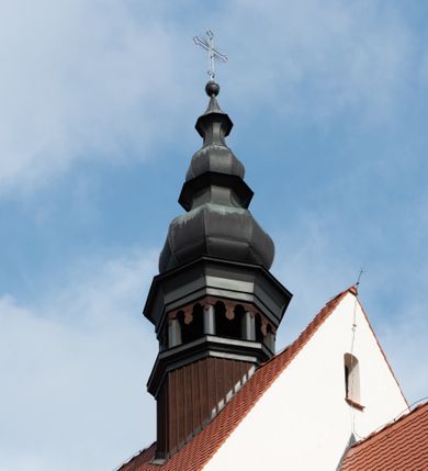 Zdjęcie nr 65: Kościół jest usytuowany w centrum wsi Rudawa, na północ od głównej drogi z Zabierzowa do Chrzanowa. Teren wokół niego jest otoczony wysokim, kamiennym murem z nieregularnych ciosów kamienia, oszkarpowanym, tynkowanym, z wyjątkiem zewnętrznej części muru na zachód od południowej bramki. W murze znajdują się trzy wejścia, od wschodu, południa i zachodu. W części wschodniej muru znajduje się trójosiowa brama wjazdowa, zwieńczona łukiem wklęsło-wypukłym, z trzema przelotami: środkowym wyższym i szerszym, zamkniętym łukiem odcinkowym i bocznymi węższymi i niższymi, zamkniętymi łukiem półkolistym (północne zamurowane). Część środkowa jest flankowana zdwojonymi pilastrami, podtrzymującymi profilowane uskokowe belkowanie z przyczółkiem o profilowanym łuku falistym, zwieńczonym równoramiennym krzyżem. W przyczółku wnęka z figurą św. Floriana. Bramki od strony zachodniej i południowej prostokątne, z przejściem zakończonym płaskim łukiem odcinkowym, z profilowanym gzymsem, zwieńczonym trójkątnym przyczółkiem. Przejścia zamykane drewnianymi ażurowymi i pomalowanymi na ciemnobrązowo jednoskrzydłowymi drzwiami. Poprzez bramkę od zachodu zejście kamiennymi schodami poprowadzonymi wzdłuż muru na dziedziniec plebański, usytuowany poniżej terenu kościelnego. 
W północno-wschodnim narożniku muru niewielka murowana i tynkowana kostnica na planie kwadratu, nakryta dachem namiotowym, łamanym, zakończonym ośmioboczną ślepą latarnią.

Po stronie południowej, poniżej placu kościelnego, do muru przylega murowana, tynkowana, prostokątna i dwukondygnacyjna „zegarowa” wieża bramna nakryta namiotowym dachem z wysoką drewnianą ośmioboczną latarnią o cebulastym hełmie. W wieży znajduje się przejazd wiodący na dziedziniec plebański, z sienią otwartą na przestrzał w dolnej kondygnacji i z lamusem dostępnym od strony placu kościelnego w górnej. 

W południowej części muru, w pobliżu południowo-wschodniego narożnika placu kościelnego, nadbudowana kamienna dzwonnica parawanowa z zawieszonymi czterema dzwonami.  

We wschodniej części placu kościelnego pomiędzy bramką wschodnią a kostnicą znajduje się kamienna ambona, o ośmiobocznej podstawie przechodzącej w szerszy, również ośmioboczny korpus, zakończony kamiennym parapetem, z kamiennymi schodami prowadzącymi na ambonę od strony wschodniej. 

Kościół jest orientowany, prawie w całości zbudowany z cegły, otynkowany z wyjątkiem prezbiterium. Wnętrze kościoła tworzy niewielkie, prostokątne, jednoprzęsłowe prezbiterium zakończone prostą ścianą i nakryte pozornym sklepieniem krzyżowo-żebrowym. Nawa jest szersza, prawie kwadratowa, nakryta drewnianym stropem. Prezbiterium z nawą są połączone szeroką, ostrołukową arkadą w ścianie tęczowej. Od północy do prezbiterium przylega założona na planie prostokąta dwuprzęsłowa zakrystia, nakryta sklepieniem krzyżowym. Wejście do zakrystii zaznaczone gotyckim, kamiennym, sfazowanym portalem zamkniętym łukiem ostrym. Od zachodu do zakrystii przylega niewielkie pomieszczenie gospodarcze, do którego z zakrystii prowadzą ostrołukowe drzwi. Zakrystia oświetlona ostrołukowym oknem w ścianie wschodniej, wypełnionym witrażem z tafelek w kształcie sześciokąta foremnego, ze szkła surowego, tzw. katedralnego. 

Od południa do nawy przylega kaplica o formach renesansowych, dwukondygnacyjna, założona na planie kwadratu. W dolnej kondygnacji sklepiona krzyżowo-żebrowo kruchta otwarta do nawy szeroką, zamkniętą półkoliście arkadą.

Ponad kruchtą kaplica św. Kazimierza, nakryta wspartą na pendentywach kopułą z latarnią. Z kruchty do kaplicy prowadzą kręte kamienne schody umieszczone od zachodu w półkolistej wieżyczce. Prostokątne wejście z krypty na klatkę schodową ujęte kamiennym profilowanym portalem. Kaplica otwarta do nawy szeroką, zamkniętą półkoliście arkadą, o kształcie i wymiarach analogicznych do arkady znajdującej się poniżej. Kaplicę, prócz latarni, oświetla prostokątne okno w ścianie południowej, wypełnione witrażem z tafelek w kształcie gomółek, ze szkła surowego, tzw. katedralnego. Na zachodniej ścianie nawy chór muzyczny, dostępny klatką schodową ukrytą w zewnętrznym aneksie przylegającym do zachodniej elewacji nawy i południowej elewacji wieży-dzwonnicy. 

Nawę i prezbiterium oświetlają umieszczone w południowych ścianach prostokątne, rozglifione okna: jedno w prezbiterium, dwa w nawie. Wszystkie wypełnione witrażami z tafelek w kształcie gomółek, ze szkła surowego, tzw. katedralnego. 

Do kościoła prowadzą dwa wejścia: poprzez arkadę z kruchty południowej oraz szerokie wejście główne prostokątne, zamknięte łukiem odcinkowym, prowadzące do kościoła z obszernej kruchty od strony zachodniej, znajdującej się w murowanym przyziemiu wieży - dzwonnicy. Kruchta, założona na planie kwadratu i nakryta murowanym stropem, doświetlona jest dwoma prostokątnymi oknami umieszczonymi naprzeciw siebie w ścianach północnej i południowej.
 
W zewnętrznej elewacji kościoła widoczny niewysoki kamienny cokół wykonany z nieregularnych ciosów kamienia. Prezbiterium, niższe od nawy, murowane z cegły w układzie wedyjskim, z domieszką układu polskiego. Wschodnie naroża prezbiterium zaakcentowane płaskimi lizenami. We wschodniej ścianie widoczny zarys zamurowanego wydłużonego okna zamkniętego lekko zaostrzonym łukiem, w trójkątnym szczycie znajduje się niewielkie wąskie okienko zakończone łukiem półkolistym. Południowa ściana prezbiterium ozdobiona fryzem z cegieł. Do ściany północnej prezbiterium przylega zakrystia, oszkarpowana, nakryta dachem pulpitowym, z dobudowanym od niej niewielkim aneksem, nakrytym takim samym zadaszeniem. Do wschodniej ściany prezbiterium przylega ogrójec nakryty dachem namiotowym z cebulastym zwieńczeniem, wspartym na sześciu smukłych, profilowanych drewnianych słupach z mieczami, pomiędzy którymi od północy i południa ażurowa drewniana balustrada. 

Nawa oszkarpowana w narożnikach. Elewacje bez podziałów architektonicznych. Od strony południowej do nawy dobudowana dwukondygnacyjna kaplica nakryta kopułą z latarnią, podzielona na dwie kondygnacje. W dolnej kondygnacji od południa wejście do kruchty zaznaczone kamiennym portalem o sfazowanych węgarach i lekko zaostrzonym łuku. Wejście zamykają drewniane dwuskrzydłowe drzwi ozdobione kratownicą z żelaznych listew. Od zachodu do kaplicy przylega półokrągła wieżyczka nakryta daszkiem stożkowym. 

Do zachodniej fasady kościoła dostawiona niska, założona na planie kwadratu trójkondygnacyjna wieża-dzwonnica: w dolnej części murowana, w narożach wzmocniona kamiennymi szkarpami, w górnej drewniana konstrukcji słupowo-ramowej z nadwieszoną izbicą i nakryta dachem półszczytowym. W dolnej, murowanej kondygnacji, na osi kościoła, prostokątne wejście do kruchty zaakcentowane przedsionkiem w kształcie ostrołukowej arkady i czterostopniowymi schodami. Przedsionek nakryty dachem dwuspadowym. Do zachodniej elewacji nawy i południowej elewacji dzwonnicy przylega niewielki, wysoki drewniany aneks, nakryty dachem pulpitowym, mieszczący klatkę schodową prowadzącą na górną kondygnację dzwonnicy i na chór muzyczny w nawie kościoła. Prostokątne wejście w południowej ścianie aneksu, do którego prowadzą pięciostopniowe proste schody. Ponad nimi, na wysokości drugiej kondygnacji dzwonnicy, niewielkie kwadratowe okno. 

Prezbiterium i nawa przykryte stromymi dachami dwuspadowymi, zamkniętymi od wschodu i zachodu szczytami sterczynowymi. Wieżyczka na sygnaturkę ośmioboczna, w dolnej części barokowa, w górnej części nowsza.