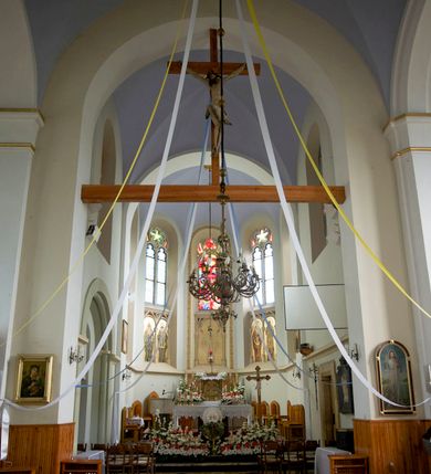 Zdjęcie nr 31: Kościół orientowany, murowany, trójnawowy, czteroprzęsłowy, z jednoprzęsłowym prezbiterium zakończonym wielobocznie. Do prezbiterium dostawione symetrycznie aneksy, od zachodu kruchta, w przyziemiu wieża flankowana dwiema klatkami schodowymi (pomieszczeniem gospodarczym?). Nawy oddzielone od siebie masywnymi filarami opilastrowanymi, z uproszczonymi kapitelami, podtrzymującymi arkady. Nawy i prezbiterium nakryte sklepieniem krzyżowym na gurtach, pięcioboczne zamknięcie prezbiterium sklepieniem parasolowatym. Nawę i prezbiterium oświetlają wysokie, prostokątne okna zakończone półkoliście z oknami trójrzędowymi dwuosiowymi, zakończonymi maswerkami. Układ komunikacyjny zaznaczony kamiennymi portalami o sfazowanych węgarach. Do kościoła prowadzą duże prostokątne drzwi, w kruchcie zakończone półkoliście. Tam też prostokątne wejścia do aneksów bocznych. W południowo-zachodniej ścianie prostokątne wejście zamknięte ściętym łukiem nadwieszonym. Takie samo wejście do aneksu południowego przy prezbiterium. Do aneksu północnego przy prezbiterium prostokątne wejście zamknięte łukiem odcinkowym, ujęte kamiennym portalem, zamkniętym półkoliście. Wejście w ścianie nawy południowej zaznaczone kamiennym portalem zamkniętym łukiem ostrym. W skrajnym przęśle nawy od zachodu chór muzyczny wsparty na dwóch filarach międzynawowych. W części chóru nad kruchtą wnęka otwarta kamienną rozetą. Fasada kościoła trójosiowa, dwukondygnacyjna, ujęta szkarpami z uskokami. Szkarpy z uskokami wydzielają także środkową oś fasady. W jej dolnej kondygnacji znajduje się kamienny portal główny, ujęty uskokowo ustawionymi półkolumnami i zakończony półkolistym tympanonem wypełnionym płaskorzeźbą ze sceną Zesłania Ducha Świętego. Powyżej wypełniona maswerkiem rozeta w profilowanej ramie. Między nią a biforium niewielki herb rodziny Potockich. Szczyt dekoruje fryz arkadkowy. W osiach bocznych wysokie, dwudzielne okna z maswerkiem. Budynek ustawiony na kamiennym cokole, oszkarpowany, z kamiennymi detalami, dekorowany fryzem arkadkowym, z otwartym od zewnątrz obejściem prezbiterium. W obejściu płaskorzeźbiona grupa Ukrzyżowania. Dachy kryte blachą – nawy i wieży dwuspadowe, przybudówek przy prezbiterium pulpitowe, nad obejściem i prezbiterium wieloboczne. Na kalenicy wieżyczka na sygnaturkę z latarnią i wielobocznym dachem. 