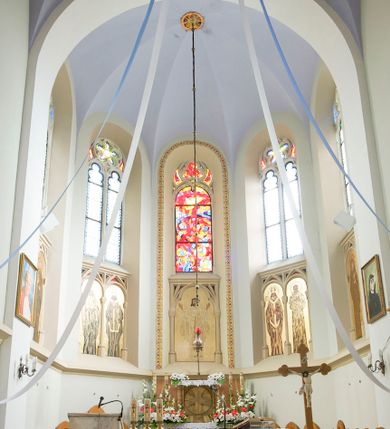 Zdjęcie nr 28: Kościół orientowany, murowany, trójnawowy, czteroprzęsłowy, z jednoprzęsłowym prezbiterium zakończonym wielobocznie. Do prezbiterium dostawione symetrycznie aneksy, od zachodu kruchta, w przyziemiu wieża flankowana dwiema klatkami schodowymi (pomieszczeniem gospodarczym?). Nawy oddzielone od siebie masywnymi filarami opilastrowanymi, z uproszczonymi kapitelami, podtrzymującymi arkady. Nawy i prezbiterium nakryte sklepieniem krzyżowym na gurtach, pięcioboczne zamknięcie prezbiterium sklepieniem parasolowatym. Nawę i prezbiterium oświetlają wysokie, prostokątne okna zakończone półkoliście z oknami trójrzędowymi dwuosiowymi, zakończonymi maswerkami. Układ komunikacyjny zaznaczony kamiennymi portalami o sfazowanych węgarach. Do kościoła prowadzą duże prostokątne drzwi, w kruchcie zakończone półkoliście. Tam też prostokątne wejścia do aneksów bocznych. W południowo-zachodniej ścianie prostokątne wejście zamknięte ściętym łukiem nadwieszonym. Takie samo wejście do aneksu południowego przy prezbiterium. Do aneksu północnego przy prezbiterium prostokątne wejście zamknięte łukiem odcinkowym, ujęte kamiennym portalem, zamkniętym półkoliście. Wejście w ścianie nawy południowej zaznaczone kamiennym portalem zamkniętym łukiem ostrym. W skrajnym przęśle nawy od zachodu chór muzyczny wsparty na dwóch filarach międzynawowych. W części chóru nad kruchtą wnęka otwarta kamienną rozetą. Fasada kościoła trójosiowa, dwukondygnacyjna, ujęta szkarpami z uskokami. Szkarpy z uskokami wydzielają także środkową oś fasady. W jej dolnej kondygnacji znajduje się kamienny portal główny, ujęty uskokowo ustawionymi półkolumnami i zakończony półkolistym tympanonem wypełnionym płaskorzeźbą ze sceną Zesłania Ducha Świętego. Powyżej wypełniona maswerkiem rozeta w profilowanej ramie. Między nią a biforium niewielki herb rodziny Potockich. Szczyt dekoruje fryz arkadkowy. W osiach bocznych wysokie, dwudzielne okna z maswerkiem. Budynek ustawiony na kamiennym cokole, oszkarpowany, z kamiennymi detalami, dekorowany fryzem arkadkowym, z otwartym od zewnątrz obejściem prezbiterium. W obejściu płaskorzeźbiona grupa Ukrzyżowania. Dachy kryte blachą – nawy i wieży dwuspadowe, przybudówek przy prezbiterium pulpitowe, nad obejściem i prezbiterium wieloboczne. Na kalenicy wieżyczka na sygnaturkę z latarnią i wielobocznym dachem. 