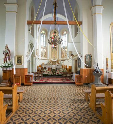 Zdjęcie nr 29: Kościół orientowany, murowany, trójnawowy, czteroprzęsłowy, z jednoprzęsłowym prezbiterium zakończonym wielobocznie. Do prezbiterium dostawione symetrycznie aneksy, od zachodu kruchta, w przyziemiu wieża flankowana dwiema klatkami schodowymi (pomieszczeniem gospodarczym?). Nawy oddzielone od siebie masywnymi filarami opilastrowanymi, z uproszczonymi kapitelami, podtrzymującymi arkady. Nawy i prezbiterium nakryte sklepieniem krzyżowym na gurtach, pięcioboczne zamknięcie prezbiterium sklepieniem parasolowatym. Nawę i prezbiterium oświetlają wysokie, prostokątne okna zakończone półkoliście z oknami trójrzędowymi dwuosiowymi, zakończonymi maswerkami. Układ komunikacyjny zaznaczony kamiennymi portalami o sfazowanych węgarach. Do kościoła prowadzą duże prostokątne drzwi, w kruchcie zakończone półkoliście. Tam też prostokątne wejścia do aneksów bocznych. W południowo-zachodniej ścianie prostokątne wejście zamknięte ściętym łukiem nadwieszonym. Takie samo wejście do aneksu południowego przy prezbiterium. Do aneksu północnego przy prezbiterium prostokątne wejście zamknięte łukiem odcinkowym, ujęte kamiennym portalem, zamkniętym półkoliście. Wejście w ścianie nawy południowej zaznaczone kamiennym portalem zamkniętym łukiem ostrym. W skrajnym przęśle nawy od zachodu chór muzyczny wsparty na dwóch filarach międzynawowych. W części chóru nad kruchtą wnęka otwarta kamienną rozetą. Fasada kościoła trójosiowa, dwukondygnacyjna, ujęta szkarpami z uskokami. Szkarpy z uskokami wydzielają także środkową oś fasady. W jej dolnej kondygnacji znajduje się kamienny portal główny, ujęty uskokowo ustawionymi półkolumnami i zakończony półkolistym tympanonem wypełnionym płaskorzeźbą ze sceną Zesłania Ducha Świętego. Powyżej wypełniona maswerkiem rozeta w profilowanej ramie. Między nią a biforium niewielki herb rodziny Potockich. Szczyt dekoruje fryz arkadkowy. W osiach bocznych wysokie, dwudzielne okna z maswerkiem. Budynek ustawiony na kamiennym cokole, oszkarpowany, z kamiennymi detalami, dekorowany fryzem arkadkowym, z otwartym od zewnątrz obejściem prezbiterium. W obejściu płaskorzeźbiona grupa Ukrzyżowania. Dachy kryte blachą – nawy i wieży dwuspadowe, przybudówek przy prezbiterium pulpitowe, nad obejściem i prezbiterium wieloboczne. Na kalenicy wieżyczka na sygnaturkę z latarnią i wielobocznym dachem. 